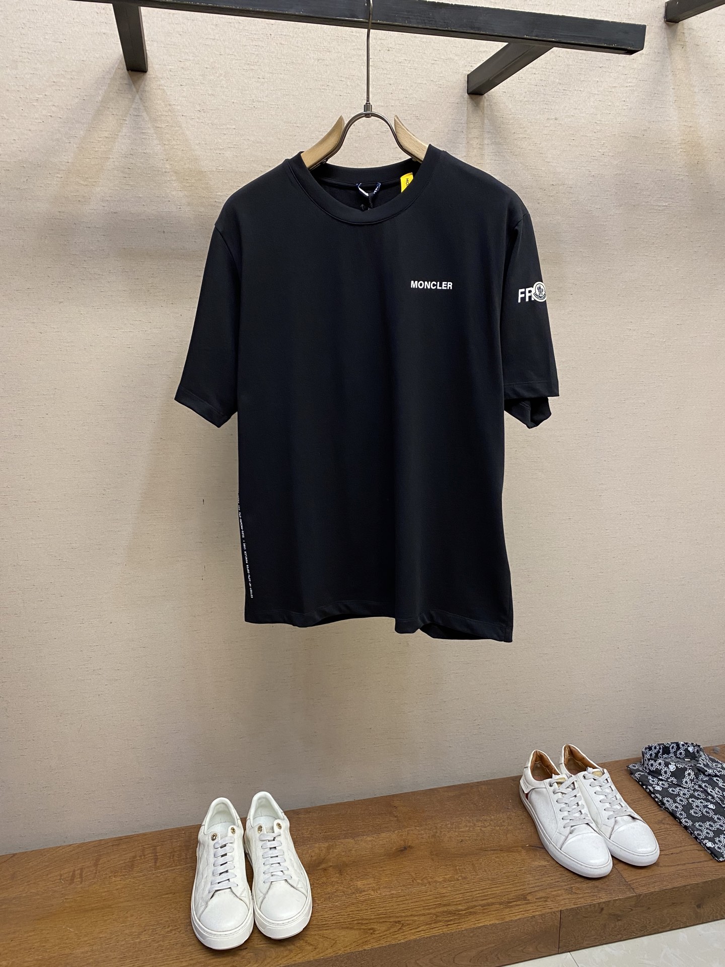 NO:455786,Moncler and Hiro Fujiwara jointly made short-sleeved T-shirt fabric selection. The fabric is made of double-strand cotton plain-woven fabric. The warp and weft yarns are interwoven in one way up and down to form a uniform square texture with a tight but thin structure. The cotton fiber has natural breathability and skin-friendliness. Combined with the pore structure of the plain-weave weave, it is suitable for daily sweating needs and has a good sense of wear. There are many interweaving points, which strengthens tear resistance and can still maintain the shape after multiple washings. Process 1 The fabric is presented with 4 high-saturation patterns through glue printing, and the scraper pressure is uniform. Scratch printing is used to ensure that the glue is fully penetrated and covered. After high-temperature curing, the pigment and cotton fibers are firmly combined. The ink-absorbing and penetration characteristics of the cotton fibers make the pattern not easily fall off due to friction. Process 2  By actively intervening in the shrinking potential of cotton fibers, the fabric has achieved a leap from volatile to stable, improving dimensional stability, and not easily deforming or wrinkling. Size S-XL, T-shirt,tees, t-shirt,alexander wang19860909Moncler、藤原浩联名短袖T恤 面料选择 采用双股棉平纹面料打造而成.经纬纱线以一上一下的方式交织而成,形成均匀的方格状纹理,结构紧密但轻薄.棉纤维具有天然的透气性和亲肤性,结合平纹织法的孔隙结构,适合日常排汗需求的同时兼具良好的穿着舒适感.纱线交织点多,强化抗撕裂能力,多次洗涤仍能保持形态. 工艺1 通过胶浆印花在面料上呈现4处高饱和度图案,刮刀压力均匀,分3次刮印确保胶浆充分渗透并覆盖.再通过高温固化后,颜料与棉纤维结合牢固,棉纤维的吸墨渗透特性使图案不易因摩擦导致脱落. 工艺2 通过主动干预棉纤维收缩潜能,实现了面料从易变到稳定的跨越,提升了尺寸稳定性,同时不易变形,褶皱. 尺码S-XL,,T-shirt,tees，t-shirt,alexander wang,Men's clothing