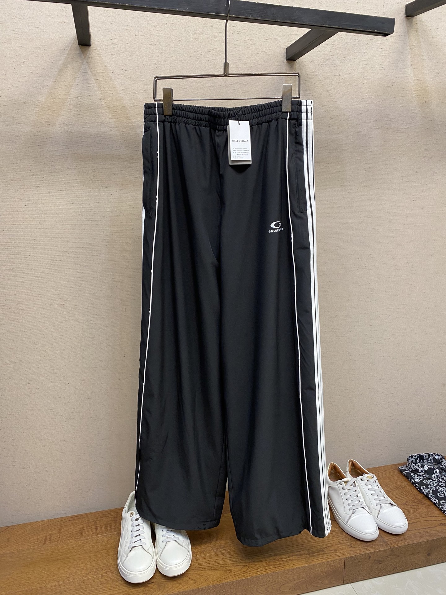 NO:483882,Balenciaga BA white side bar sports trousers, original, 600 purchase; elastic polyester fiber, mid-waist elastic waist, 2 oblique pockets with zippers, contrasting color yak, left leg embroidery with loop sports icon embroidery, full set of auxiliary materials are equipped with # elastic polyester fiber fabric material The polyester fiber itself has good elasticity, the fabric is blended with polyester fiber and elastic fiber to enhance the four-way stretching ability of the fabric, taking into account flexibility and support. The hydrophobic properties of polyester fiber make it difficult to absorb water, can quickly lead to sweat and evaporate, keep the body dry. Durability and easy care, wrinkle resistance, wear resistance and strong shape-containing, suitable for frequent wear and machine washing. # Lining is equipped with mesh fabric  Mesh cloth is known as a bird's eye cloth. It uses the changes in jacquard tissue or pendant method. The warp yarn has three tines as a group of tines, and can also weave fabrics with small holes on the surface of the cloth. Its most important function is moisture-absorbing and sweating. The principle of sweating is carried out through small holes on its surface. It can achieve the effect of moisture-absorbing and sweating well. # The front is embroidered with artwork. The embroidery is made of tatami embroidery and is made on both sides of the front and back. This process is a decorative process for applying embroidery on tatami mats. It uses mechanical imitation and hand-embroidery to increase its aesthetics and decorativeness. For custom-made embroidery thread materials for plates and colors, it is necessary to choose a suitable rice mat as the base material for embroidery to ensure that its surface is flat, smooth and suitable for embroidery. Draw the line outline on the fabric according to the embroidery drawing so that it can be accurately embroidered according to the outline when embroidery. # Contrast color Yuke Design  Contrast color Yuke design creates a strong visual impact through the splicing of the strips, breaking the dullness of a single tone. It not only retains the vitality of movement, but also combines color collision and visual layers. The side contrasting color stripes extend the leg lines, match with high elastic fabrics, and combine vertical cutting technology to create a three-dimensional silhouette to provide motion support. Size XS-L, balenciaga, alexander wang19860909Balenciaga BA 白侧杠运动长裤 原,600购买；弹力聚酯纤维、中腰弹性腰头、2个斜口袋设有拉链、撞色育克、左腿饰以loop sports icon刺绣、全套辅料配备 # 弹力聚酯纤维面料材质 聚酯纤维本身具有较好的弹性,面料即采用聚酯纤维与弹性纤维混纺技术,提升面料的四向拉伸能力,兼顾灵活性与支撑性.聚酯纤维的疏水特性使其不易吸水,能快速导出汗水并蒸发,保持身体干爽.耐用性与易护理抗皱、耐磨且保形性强,适合频繁穿着和机洗. # 内衬设有网布织物 网布具有吸湿排汗鸟眼布之称,利用提花组织或穿筘方法的变化,经纱以三根为一组个筘齿,也可织出布面有小孔的织物.它最重要的作用就是吸湿排汗,其排汗的原理就是通过它表面上的小孔进行的,它能很好的达到吸湿排汗的效果. # 正面饰以艺术品绣花 绣花整体采用榻榻米绣花,正反两面制作而成；这种工艺是一种将绣花应用于榻榻米垫上的装饰工艺.采用机械仿手工刺绣方式,以增加其美观性和装饰性. 对版对色定做绣线材质,需要选择合适的米垫作为刺绣的基材,确保其表面平整、光滑且适合刺绣.根据绣图在面料上画出线条轮廓,以便在刺绣时能够准确地按照轮廓进行绣制. # 撞色育克设计 撞色育克设计通过间条拼接,形成强烈视觉冲击,打破单一色调的沉闷感.既保留运动活力,又具有色彩碰撞与视觉层次结合.侧身撞色条纹拉长腿部线条,搭配高弹力面料,结合立裁工艺打造立体廓形,提供运动支撑力. 尺码XS-L,,balenciaga,alexander wang,Men's clothing