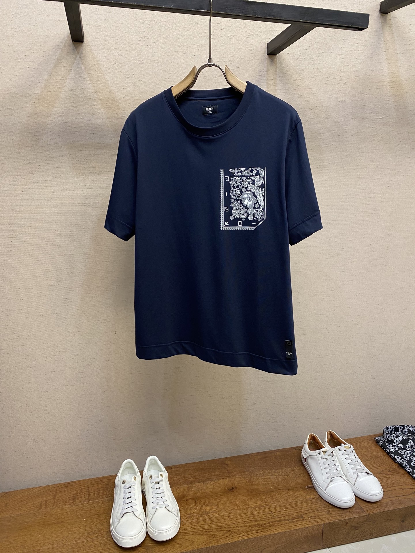 NO:411860,Fendi, Coral Printed Short-sleeved T-shirt Fabric Selection: It is made of high-stretched long-length cotton. The warp and weft density can reach 1,000 pieces/inch. The cloth surface is tight and flat, and the touch is smooth like silk. The high-density structure enhances the durability of the fabric, is not easy to pill and deform, and has good wrinkle resistance. Cotton fibers are naturally skin-friendly, breathable and hygroscopic, and are soft and non-irritating. Process 1 The coral flower pattern is presented on the fabric through glue printing, with uniform spatula pressure. The chest patch sheet is scratched by the printer for 30 times to ensure that the printing thickness presents a micro three-dimensional convex structure, and the glue is fully penetrated and covered. The back sheet printing is relatively thin after 7 scratches, but it does not hinder its beauty and firmness. Finally, after high-temperature curing, the pigment is firmly combined with the cotton fiber, and the ink-absorbing characteristics of the cotton fiber make the pattern not easily fall off due to friction.  Process 2 The fabric is uniformly humidified by steam, squeezed with a heated roller and an elastic rubber blanket, forcing the fibers to retract, and finally cooled down through cold air to fix the form. After treatment, the shrinkage rate is controlled within 3. Sizes S-XL,,fendi,T-shirt,tees,t-shirt,alexander wang19860909Fendi,珊瑚花印花短袖T恤 面料选择 选用高支长绒棉编织而成 ,经纬密度可达1000根/英寸,布面紧密平整,触感光滑如丝绸,高密度结构增强了面料的耐用性,不易起球变形,且有良好的抗皱性.棉纤维具有天然的亲肤性,透气性和吸湿性并存,贴身柔软,无刺激. 工艺1 通过胶浆印花在面料上呈现珊瑚花图案,刮刀压力均匀,胸贴袋片经过印花师30次刮印确保印花厚度呈现微立体凸起结构,并使胶浆充分渗透并覆盖.后片印花经过7次刮印相对较薄,但同样不妨碍其美感和牢固度.最后通过高温固化后,颜料与棉纤维结合牢固,棉纤维的吸墨渗透特性使图案不易因摩擦导致脱落. 工艺2 面料经蒸汽均匀加湿,用加热后的辊筒与弹性橡胶毯挤压,迫使纤维回缩,最后通过冷风降温固定形态.经过处理之后将缩水率控制在3以内. 尺码S-XL,,fendi,T-shirt,tees，t-shirt,alexander wang,Men's clothing