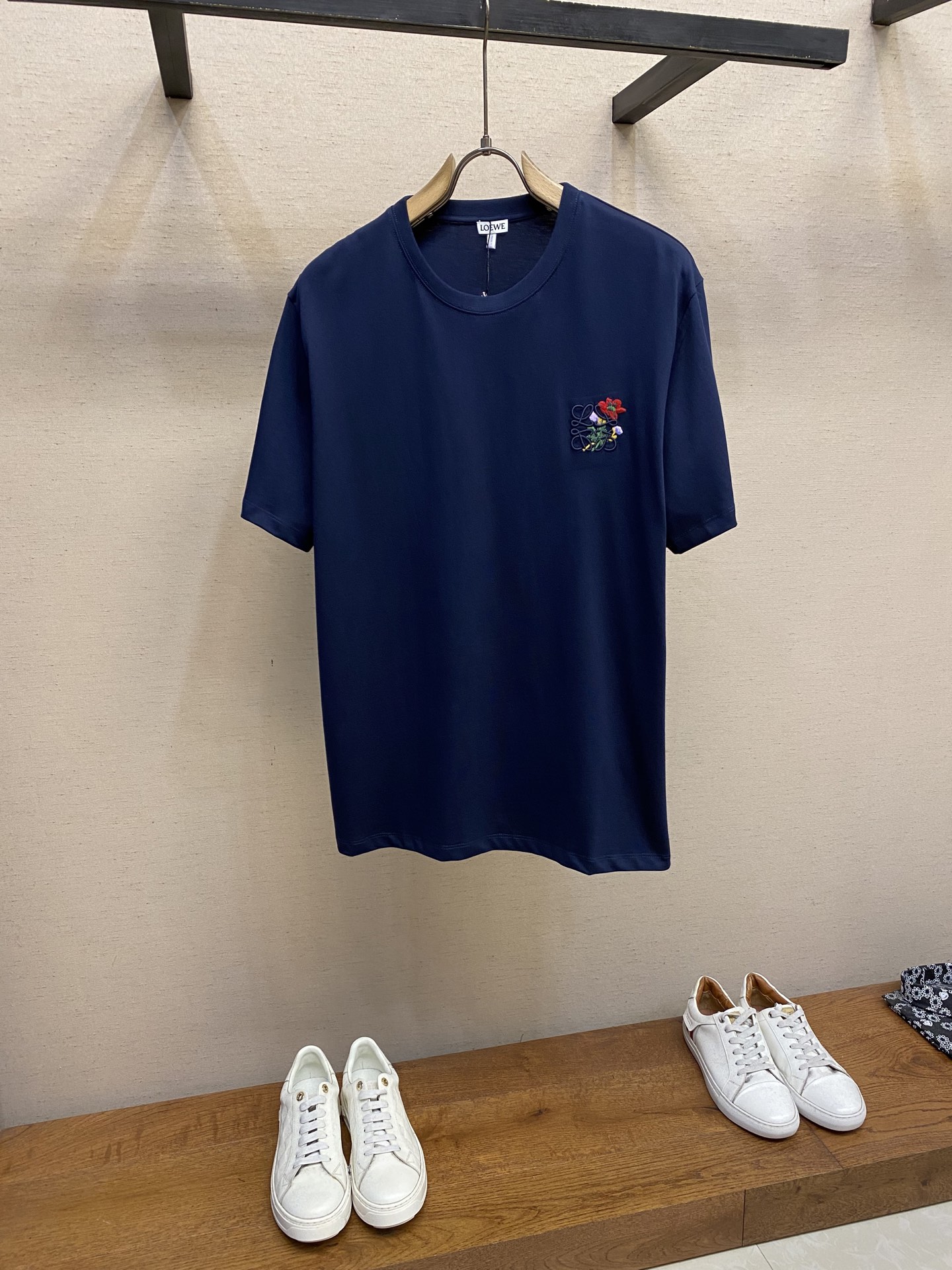 NO:483854,Loewe, small red logo embroidery short sleeves Original, 800 purchase; light cotton T-shirt with blended yarn floral embroidery on the chest, loose fitting, standard length, round neck design # Lightweight pure cotton fabric uses 15S fine cotton plain pattern, 230g; matched with 32S double yarn thread, 350g. Fine cotton fabric usually has good moisture absorption, breathability, warmth and wear resistance, and is also soft and smooth. Retro fine cotton fabric has thicker cotton fabric, with retro style tones, and has fine processing and processing, with excellent texture and performance. Due to fine processing, the fine cotton fabric is lighter and thin, soft and comfortable to touch, and it is very suitable for the skin when worn. # Logo logo embroidery  The logo adopts three-dimensional embroidery technology, and the logo clearly restores the spacing curve. The shiny woven embroidery thread is selected. The machine combines complex embroidery needlework and fine detail processing to create the embroidery effect of three-dimensional relief. Classic trademark letter design, fine embroidery needlework is dense, the font is clear and the line feel is strong. The floral pattern adopts the needle embroidery process, and the needle is a bit similar to the needle. The needle is interwoven by different lengths and short needles. The embroidery surface is specially treated, and its delicateness makes the thread smooth, and then the overall embroidery pattern is finished with the method of flat embroidery. # Simple vertical round neck short sleeves  The paper pattern is developed with minimal body cutting. The knitted material has certain extension performance and the upper body will not be tightly tied. The round neck is the same color ribbed splicing neckline, and the inner sticking process of the back neckline effectively prevents the neckline from deformation after multiple washes, fit shoulder line, bottom swing and cuff special machine clamp and car open line edge. Size XS-L,,loewe,T-shirt,tees,t-shirt,alexander wang19860909Loewe,小红花徽标刺绣短袖 原,800购买；轻盈棉质T恤、胸前设有混纺纱花卉刺绣、宽松版型、标准长度、圆领设计 # 轻盈质地纯棉质面料 采用15S精棉平纹,230g；搭配 32S双纱拉架螺纹,350g.精棉面料通常具有较好的吸湿性、透气性、保暖性和耐磨性,同时也比较柔软和光滑.复古精棉面料比较厚实的棉质面料,具有复古风格的色调,同时经过精细加工和处理,具有优良的质地和性能.由于经过了精细加工,精棉面料的质地比较轻薄,手感柔软舒适,穿着起来非常贴合皮肤. # 标志徽标刺绣 徽标采用立体刺绣工艺,徽标清晰还原间距曲线.精选具有光泽感的丝光绣线进行,机结合复杂刺绣针艺,精细的细节处理,造就了立体浮雕的刺绣效果.经典商标字母设计,刺绣精细针法绵密,字体清晰且线条感和立体感强. 花卉图案采用插针刺绣工艺,插针有点类似于挨针,插针由不同长短针相互交织而达到的不均匀效果.刺绣表面进行特殊处理,其细腻度使丝线平整顺滑,接着利用平绣的针法,进行整体刺绣图案收尾. # 简约垂直圆领短袖版型 对版纸样开发极简直身剪裁,针织材质具有一定延展性能,上身不会紧紧束身.圆领同色罗纹拼接领口,后领口内贴条工艺,有效防止多次穿洗后领口变形,合身肩线,底摆与袖口专机坎车明线收边. 尺码XS-L,,loewe,T-shirt,tees，t-shirt,alexander wang,Men's clothing