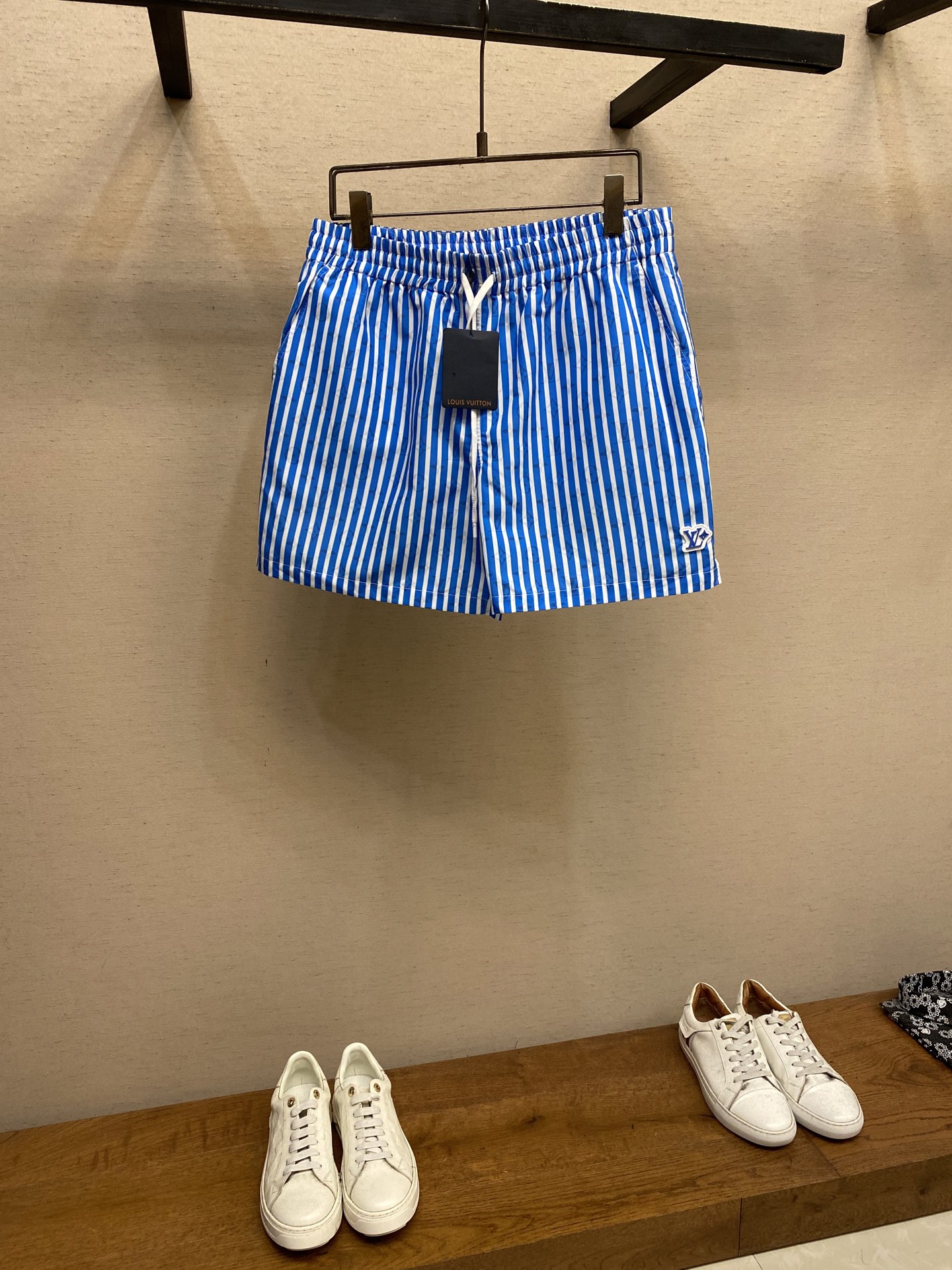 NO:449805,1V, blue and white striped printed beach shorts Original, 550-plus; nylon woven fabric, standard version, logo printing, mesh lining, drawstring waist, side pocket, zippered back pocket, left leg embellishment rubber logo patch, full set of auxiliary materials equipped # High elastic cotton-elastic fabric material Cotton-elastic fabric is a lightweight fabric with wear resistance first among all kinds of fabrics, and its durability is excellent. The wicking performance of cotton-elastic fiber is very strong. The absorbed water vapor is quickly eliminated through the capillaries in the fiber, allowing the fabric to have good softness and keep warm and wet, improving the comfort performance of clothing. Cotton-elastic fiber also has the characteristics of antibacteriality. # The lining is equipped with mesh fabric  Mesh cloth is known as a bird's eye cloth for moisture absorption and sweating. It uses changes in jacquard tissue or pendant method. The warp yarn uses three tines as a group of tines, and can also weave fabrics with small holes on the surface of the cloth. Its most important function is moisture absorption and sweating. The principle of sweating is carried out through small holes on its surface. It can achieve the effect of moisture absorption and sweating well. # Full presbyop pattern with fresh stripes. Select the brand's classic presbyop pattern as the shading to cover the whole shorts to enhance recognition. The base color is beige, and the vertical pinstripes are paired with light sky blue stripes to penetrate Monogram horizontally to form a visual layer to avoid thickening and create a refreshing feeling.  Full-frame digital direct injection process can directly print complex details and gradient stripes, support Pantone color library, and accurately present the transparent superposition effect of light-colored stripes and shading. The fabric after printing maintains the original softness, which is suitable for the close-fitting and comfortable needs of beach shorts. # Sports shorts style Fully elastic and high waist can adjust the waist size, and the front end of the elastic waist rope has a lettering hardware hanging bell. The inner layer of the waist is fixed by multiple traces and external materials, and it will not cause the rubber to flip through and wash. The obliquely inserted zipper pocket design on both sides; the pocket ends are knotted, strong, durable and washable. Size XS-L, shorts, alexander wang198609091V、蓝白条印花沙滩短裤 原,550购买；锦纶梭织面料、标准版型、标识印花、网格内衬、抽绳腰部、侧袋、拉链后袋、左腿点缀橡胶标识贴饰、全套辅料配备 # 高弹棉纶面料材质 棉纶面料属轻型织物,耐磨性能居各类面料之首,其耐用性极佳.棉纶纤维的芯吸性能很强,通过纤维中的毛细管来将吸收的水汽快速排除,让面料拥有良好的柔软性既保暖又导湿,提高服装的舒适性能,棉纶纤维还具有抗菌的特点. # 内衬设有网布织物 网布具有吸湿排汗鸟眼布之称,利用提花组织或穿筘方法的变化,经纱以三根为一组个筘齿,也可织出布面有小孔的织物.它最重要的作用就是吸湿排汗,其排汗的原理就是通过它表面上的小孔进行的,它能很好的达到吸湿排汗的效果. # 全幅老花图案叠加清新条纹 选择品牌经典老花图案作为底纹,覆盖整条短裤强化辨识度.底色选用米白,搭配竖向细条纹以浅色天蓝条纹横向贯穿Monogram,形成视觉层次,避免厚重感营造清爽感. 采用全幅数码直喷工艺,可直接打印复杂细节与渐变条纹,支持Pantone色库,能精准呈现浅色条纹与底纹的透明叠加效果.喷印后面料保持原有柔软度,适合沙滩短裤的贴身舒适需求. # 运动短裤版型 全松紧高腰可调节腰围大小,松紧腰绳前端带有刻字五金吊钟.腰间内层橡筋通过多道走线与外料固定,穿洗均不会造成橡筋翻转.两侧斜插式的拉链口袋设计；兜口两端专机打结,结实耐穿耐洗. 尺码XS-L,,shorts,alexander wang,Men's clothing