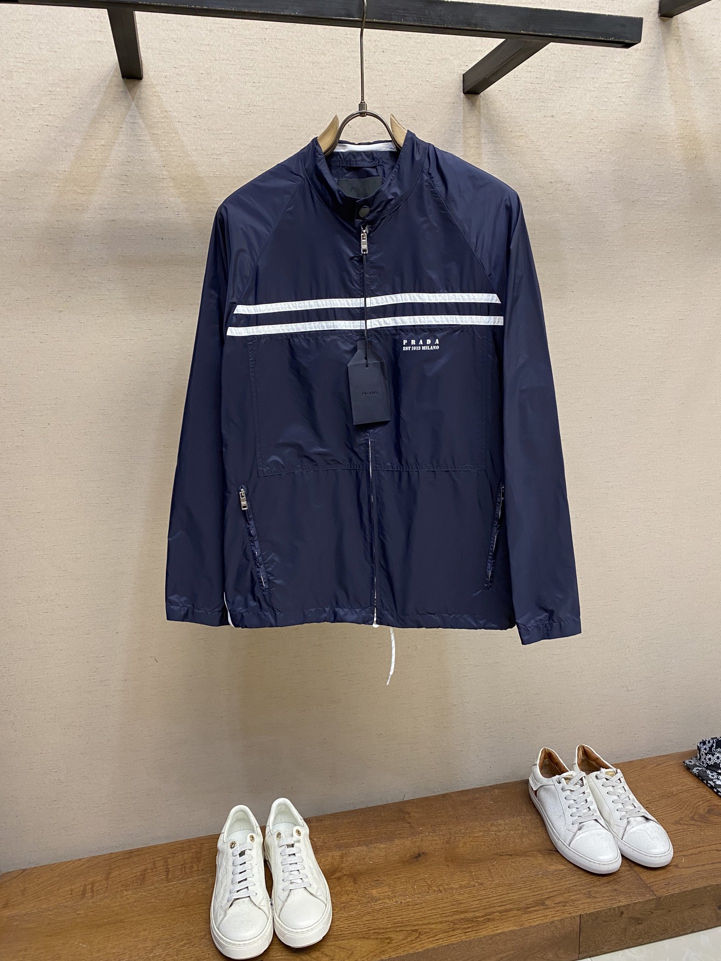 NO:480284,Prada, recycled nylon printed logo jacket Fabric selection Use the brand's iconic recycled nylon fabric, which is comparable to traditional nylon. After the anti-fouling, waterproof and tear-resistant composite process, the surface presents a unique silk gloss touch, taking into account the characteristics of high strength, tear resistance, wear resistance, etc. The overall texture is light, wrinkle-resistant, and quick-drying characteristics are also easy to take care of and maintain. The process is decorated with letter logos at the front sheet through the glue printing process, and the scraper pressure is uniform. After 5 scrapings, the printing thickness is ensured to have a micro three-dimensional convex structure, and the glue is fully penetrated and covered. Finally, after high-temperature curing, the pigment and the fabric are firmly combined, which is not easy to fall off due to friction. Details  Unlined single-layer structure, relying on the high-density braiding characteristics of recycled nylon, makes it breathable and protective. It adopts a standing collar structure to fit the neck lines, taking into account windproof function and capable temperament. The hood is removable to meet the needs of multiple scenarios. Size S-XL, prada, jackets & coats, hats, alexander wang19860909Prada,再生尼龙印花徽标夹克 面料选择 选用品牌标志性的再生尼龙面料,与传统尼龙性能相当,通过防污防水抗撕裂复合工艺处理之后,表面呈现独特的丝绸光泽触感,兼顾高强度,抗撕裂,耐磨损等特性,整体质地轻盈,抗皱,快干的特点也易于日常打理维护. 工艺 通过胶浆印花工艺在前片处饰以字母徽标,刮刀压力均匀,经过5次刮印确保印花厚度呈现微立体凸起结构,并使胶浆充分渗透并覆盖.最后通过高温固化后,颜料与面料结合牢固,不易因摩擦导致脱落. 细节 无衬里单层结构,依托再生尼龙的高密度编织特性,使其透气性与防护性并存.采用立领结构,贴合颈部线条,兼顾防风功能和干练气质.可拆卸兜帽,满足多场景需求. 尺码S-XL,,prada,jackets & coats,hats,alexander wang,Men's clothing