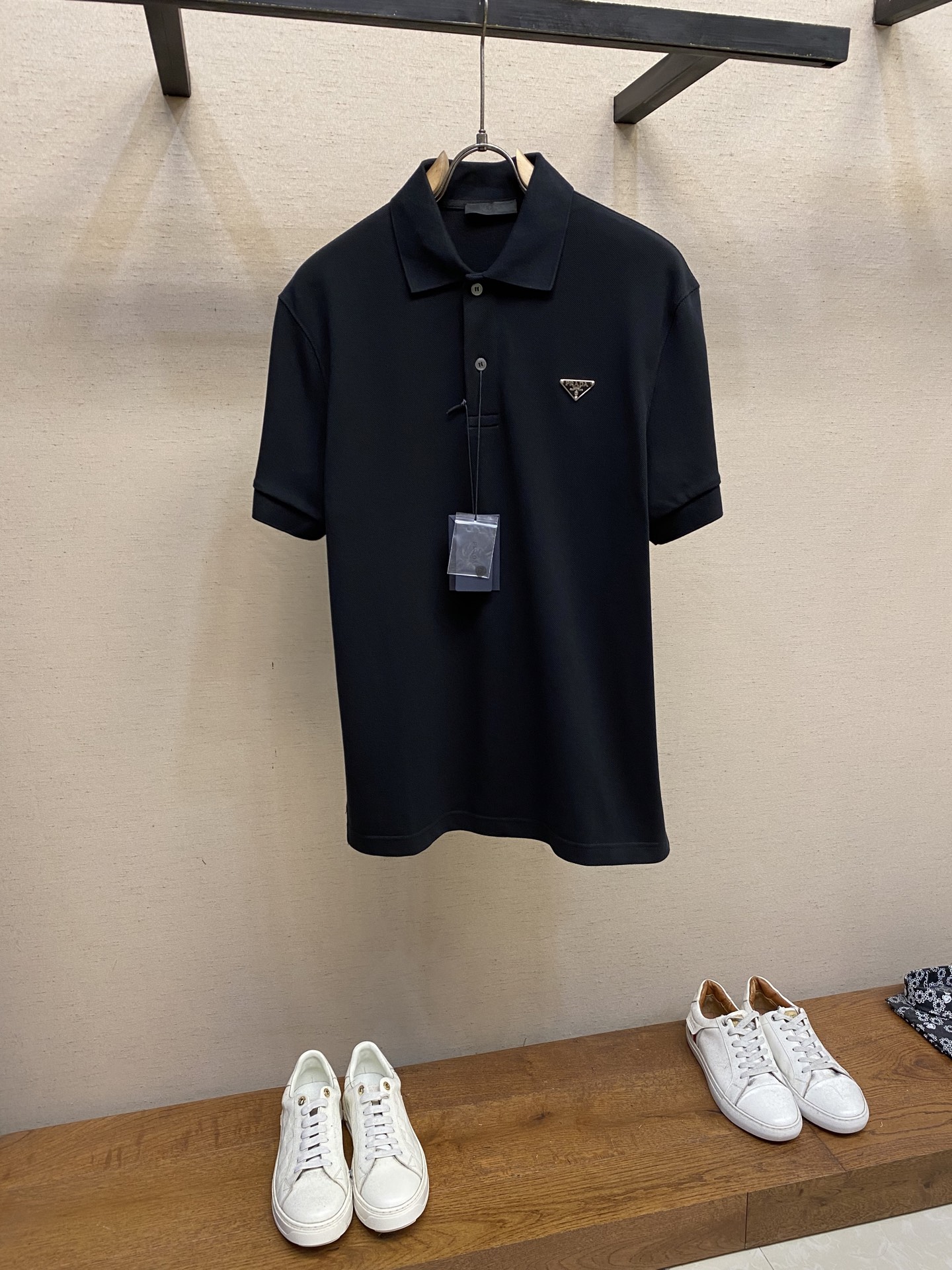 NO:461107,Prada and cotton triangular POLO shirt fabric selection uses pure cotton bead cloth. On the basis of traditional bead cloth, thinner cotton yarn and lighter weaving process not only retains the texture characteristics, but also enhances the lightness of the fabric. The three-dimensional braiding structure makes the fabric more elastic, not easy to deform and wrinkle. The touch is delicate and skin-friendly, and it is unrestrained. The honeycomb-like texture forms a natural air circulation channel, accelerating the evaporation of sweat. Process 1 The rib knitting process uses wool as the main raw material to make the neckline naturally stretchable, adapt to different neck curves, avoid tightness and looseness, and make it more comfortable to wear. Through steam ironing, even if it is folded for a long time, it can still remain firm and stylish. Process 2 Through active intervention in the shrinkage potential of cotton fibers, the fabric has achieved a leap from easy to change to stable, which improves dimensional stability, and is not easy to deform and wrinkle.  Size S-XL, prada, alexander wang19860909Prada、棉质饰三角标POLO衫 面料选择 采用纯棉珠地布,在传统珠地布基础上,采用更细的棉纱和更轻薄的编织工艺,既保留了纹理特征,又提升了面料的轻盈感.立体编制结构使面料更具弹性,不易变形和起皱.触感细腻亲肤,穿着无束缚感.蜂巢状纹理形成天然的空气流通通道,加速汗液蒸发. 工艺1 以羊毛为主要原料通过罗纹针织工艺使领口具备自然的伸缩性,适应不同颈部曲线,避免紧绷和松垮,穿着更舒适.通过蒸汽整烫,即使长时间折叠,仍能保持挺括有型. 工艺2 通过主动干预棉纤维收缩潜能,实现了面料从易变到稳定的跨越,提升了尺寸稳定性,同时不易变形,褶皱. 尺码S-XL,,prada,alexander wang,Men's clothing