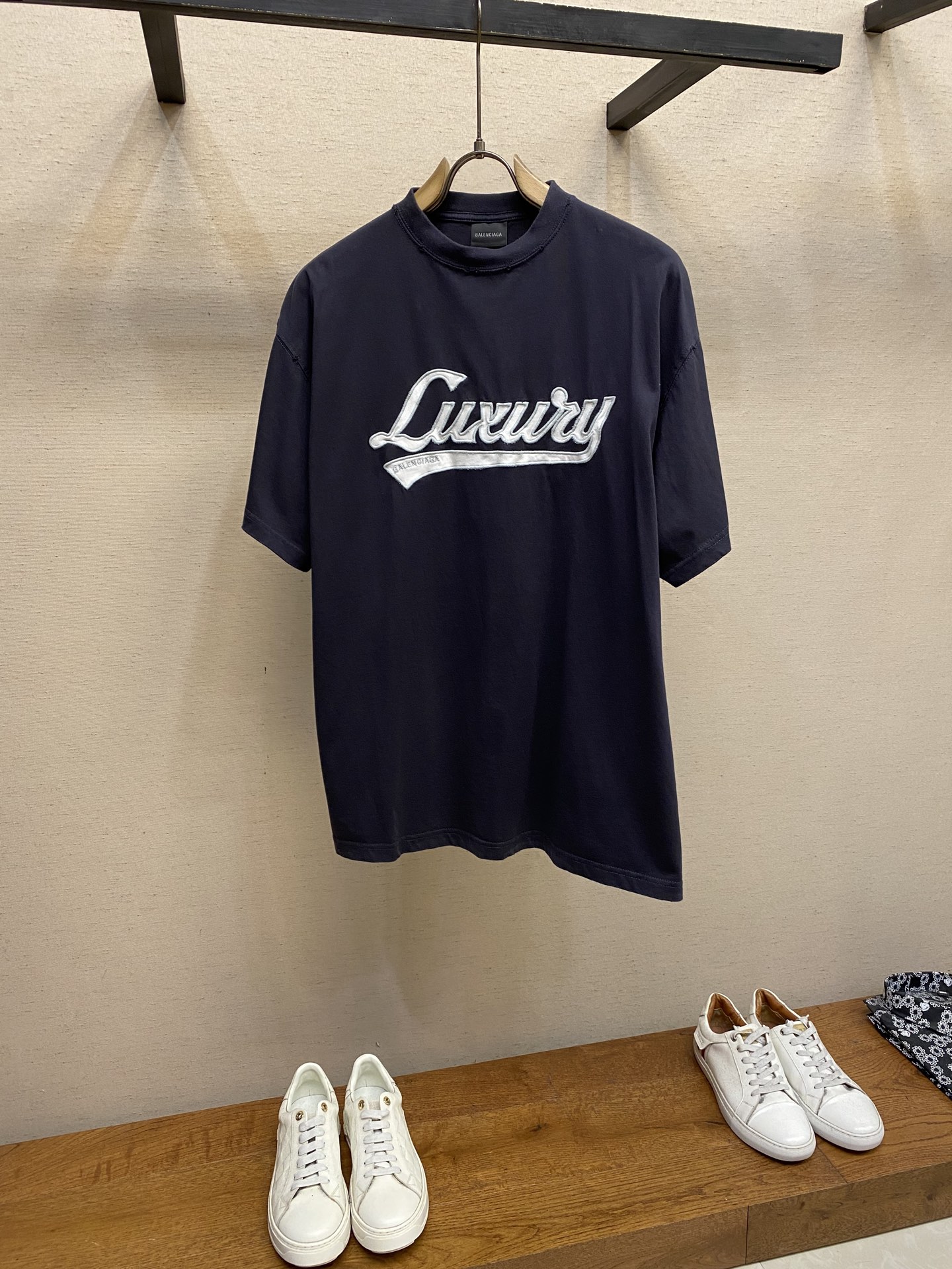 NO:574018,Balenciaga, luxury letter patch round neck short sleeves, original purchase, 000; plain knitted fabric, embroidered with luxury script artwork on the front, frayed damage effect, round neck short sleeves, full set of accessories # Retro jersey fabric Made of 24S double yarn retro plain knit fabric, 185g; matched with 32S double yarn 1*1  Thread, 270g. 24S fabric is a medium-to-thick yarn, suitable for creating thick, crisp fabrics with a slightly rough texture, in line with the 'natural and original' effect pursued by retro style. The texture is soft, breathable and elastic, suitable for close-fitting wear, and can create a simple and smooth outline. The design details of the retro-style loose silhouette are reflected through old textures, fading processing, and classic tailoring. # The front is decorated with luxury script artwork embroidery   Appliqué is a clothing technology that forms a three-dimensional decorative pattern by sewing cut fabrics onto fabrics. It is both practical and artistic, using the superposition of different fabrics to create a sense of layering. Laser cutting technology uses high-power density laser beams to irradiate the surface of the material to be cut to achieve cutting processing technology. # Abrasion damage effect treatment  In the post-processing of embroidery process, the destruction and wear effect is a special design technique, which is used in retro and Japanese-style clothing design. Partially polish the embroidery edges or raised parts to create fading and fluffing effects; use the washing process to enhance the sense of wear. Laser engraving fine textures to maintain the sense of craftsmanship; use fading and slight burrs to imitate natural aging. # High collar, oversize, loose version   Oversize loose silhouette design, basic round neckline and dropped shoulder line, vertical pit woven code from top to bottom, collar, cuffs, and hem all have ribbing, and the sleeve length is longer to highlight the details. The thickness of the ready-made garment is consistent with the original version, and is additionally shaped to make the upper body wide and not easy to deform. Sizes XS-L, balenciaga, versace, T-shirt, alexander wang19860909Balenciaga、奢华字母贴布圆领短袖 原,000购买；平纹针织面料、正面饰以luxury script艺术作品刺绣、磨损破坏效果、圆领短袖、全套辅料配备 # 复古平纹针织面料 采用24S双纱复古平纹针织面料,185g；搭配32S双纱1*1 螺纹,270g.24S面料属于中等偏粗的纱线,适合打造厚实、挺括的面料,质感略带粗糙感,符合复古风格追求的“自然原始”效果.质地柔软、透气且有一定弹性,适合贴身穿着,能塑造简约流畅的轮廓.通过做旧纹理、褪色处理,结合经典剪裁体现复古感宽松廓形设计细节. # 正面饰以luxury script艺术作品刺绣 贴布绣是一种通过将裁剪好的布料缝制在织物上,形成立体装饰图案的服装工艺,兼具实用性与艺术性,利用不同面料的叠加创造层次感.激光切割技术是利用高功率密度的激光束,照射在待切割材料表面,实现切割加工技术. # 磨损破坏效果处理 刺绣工艺的后道处理中,破坏和磨损效果是一种特殊的设计手法,用于复古、做日风格的服装设计.局部打磨刺绣边缘或凸起部分,制造褪色、起毛效果；配合水洗工艺增强磨损感.激光雕刻精细纹理,保持工艺精致感；搭配褪色和轻微毛边,模仿自然旧化. # 高领oversize宽松版型 oversize宽松廓形设计,基础款圆领领口落肩线,自上而下采用纵向坑条织码,领口、袖口、下摆均有罗口收口,袖长更偏长突出细节感.成衣厚度与原版一致,另做定型处理,上身挺阔不易变形. 尺码XS-L,,balenciaga,versace,T-shirt,alexander wang,Men's clothing