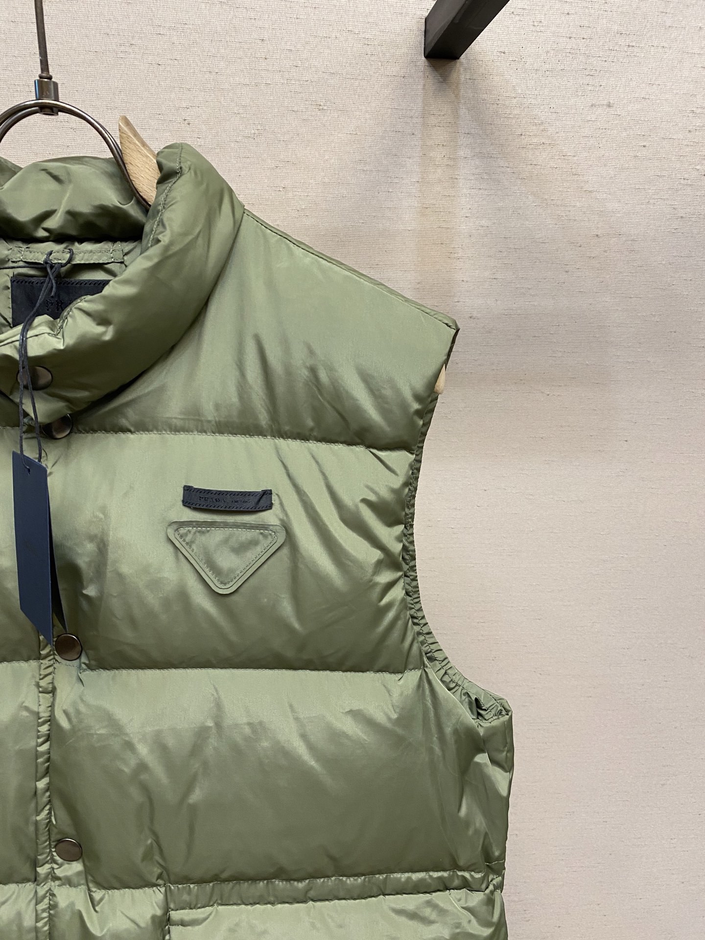 🌟🌟Prada、饰织物三角标羽绒马甲正面面料选择:选用品牌标志性的再生尼龙面料,与传统尼龙性能相当,具备