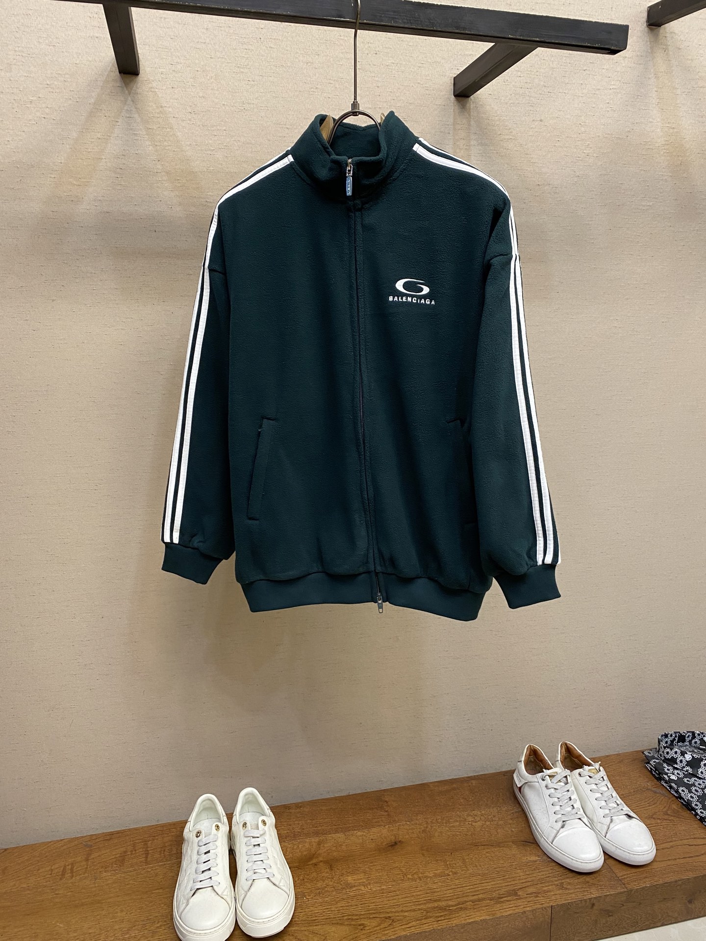 NO:541483,Balenciaga, sleeve embroidered stand collar zipper jacket Original, 000 purchase; fleece fabric material, front and back embroidered with artwork embroidery, double-head zipper closure, sleeves decorated with contrasting piping, zippered oblique pockets, condensed cuffs and waist circumference, full set of auxiliary materials are equipped with # fleece knitted fabric material High-performance fleece knitted fabric is known for its excellent warmth and light texture. Through the special brushing process, the surface of the fabric forms a dense and rich fleece structure, effectively locking the stationary air and achieving efficient heat insulation. Unit weight is better than traditional knitted materials. At the same time, its fiber gap ensures timely moisture is exported and breathable. The fabric is usually treated with anti-static and water-resistant to splashing to enhance practical functions, and has excellent ductility and pill resistance, soft and fluffy feel, and has no sense of restraint when moving. # fleece embroidered with artwork It uses high-density stitches and multi-color embroidery threads, with clear and three-dimensional and full edges; it is made of overall tatami embroidery technology. For the custom embroidery thread material, a suitable rice pad is needed to be selected as the base material for embroidery to ensure that its surface is flat, smooth and suitable for embroidery. The line outlines are drawn on the fabric according to the embroidery drawings so that it can be accurately embroidered according to the outline when embroidery. # Features and functional details of the style design The contrasting color piping of the sleeves is precisely sewn with the edge wrapping process to strengthen the contour lines and enhance wear resistance; the contrasting color fabric and white color design enhance visual impact, the condensing cuffs and waist are made of high elastic rib material to enhance fit and prevent cold air from pouring in. The two zippered oblique pockets take into account storage safety and shape smoothness, reflecting practical details. The style takes into account neutral tailoring, and balances loose and slim-fitting through shrinking waist and straight tumble body. The high-neck design extends the neck protection, echoing the theme of sports protection; the overall design highlights the visual focus of embroidery and piping with minimalist contours, transforming functional details into design elements, perfectly integrating sports genes and street art style. Size XS-L,,balenciaga,jackets & coats,alexander wang19860909Balenciaga、袖条刺绣立领拉链外套 原,000购买；摇粒绒面料材质、正面和背面饰以艺术作品刺绣、双头拉链开合、衣袖饰以撞色滚边、拉链斜口袋、缩褶袖口和腰围、全套辅料配备 # 摇粒绒针织面料材质 高性能摇粒绒针织面料以其卓越的保暖性与轻质感著称.通过特殊拉毛刷绒工艺,面料表面形成密集丰盈的绒粒结构,有效锁住静止空气,实现高效隔热,单位克重保暖性优于传统针织材质. 同时,其纤维间隙确保湿气及时导出,兼顾透气性.该面料通常经抗静电及防泼水处理,增强实用机能,且具备优良延展性与抗起球性,手感柔软蓬松,活动时无束缚感. # 正面饰以艺术品绣花 采用高密度针脚与多色绣线,图案边缘清晰且立体饱满；整体榻榻米绣花技术制作而成.对版对色定做绣线材质,需要选择合适的米垫作为刺绣的基材,确保其表面平整、光滑且适合刺绣.根据绣图在面料上画出线条轮廓,以便在刺绣时能够准确地按照轮廓进行绣制. # 版型设计特点与功能性细节 衣袖撞色滚边以包边工艺精密缝合,强化轮廓线条并提升耐磨性；净色面料与白色撞色设计强化视觉冲击,缩褶袖口与腰围采用高弹罗纹材质,增强贴合性并防止冷风灌入,搭配双头拉链实现灵活开合,2个拉链斜口袋兼顾储物安全与造型流畅度,体现实用主义细节. 版型兼顾中性剪裁,通过缩褶收腰与直筒衣身平衡宽松与修身感.高领设计延伸颈部防护,呼应运动防护主题；整体以极简轮廓突出刺绣与滚边的视觉焦点,将功能性细节转化为设计元素,完美融合运动基因与街头艺术风格. 尺码XS-L,,balenciaga,jackets & coats,alexander wang,Men's clothing