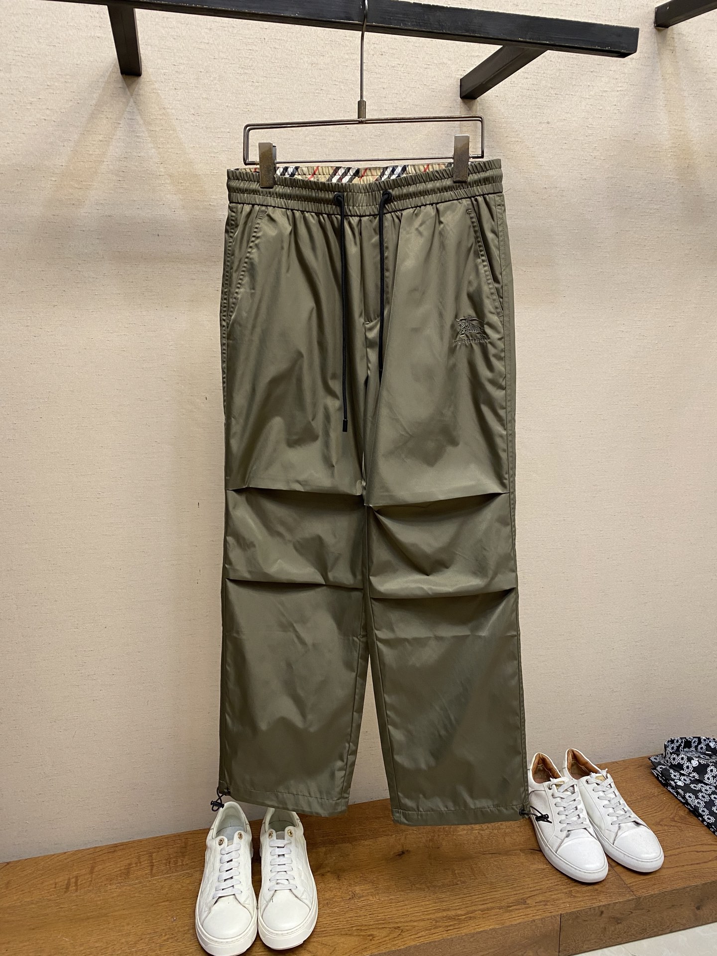 NO:565554,BBR, 25 new autumn and winter styles~BBY military green war horse logo drawstring drawstring pants casual pants are classic military green with a retro and tough temperament, easily adaptable to various styles of wear. The pants are loose straight style, which is very tolerant to the body shape. Whether it is for casual outings or daily commuting, it can create a casual yet stylish look.  The details show the brand's ingenuity. The waistband is designed with a drawstring and metal grommets with the brand logo, which is not only easy to adjust, but also adds a sense of sophistication. It is also moderately tight and comfortable to wear without constricting the waist. There is the brand's iconic knight embroidered logo on the front, which is exquisite in craftsmanship and full of three-dimensionality. It shows the brand identity in a low-key manner. There is also a colorful plaid knight pattern embroidery on the back pocket. The color matching is harmonious, adding a touch of bright color and uniqueness to the whole, making the pants no longer monotonous.   Looking at the material, the outer layer is made of nylon fabric, which has a smooth and crisp texture, is wear-resistant and wrinkle-resistant, and is very worry-free for daily care. The mesh material inside is breathable and skin-friendly, so you will not feel stuffy even if you wear it for a long time, and it is very comfortable. There is also an adjustable drawstring design on the trouser legs, which allows you to freely switch between leg-tie or straight-leg styles according to personal preferences and matching needs. Full marks for practicality. Size XS-L,, alexander wang19860909BBR,25秋冬新款~BBY军绿色战马徽标抽绳束口裤 休闲裤子 经典的军绿色,自带复古又硬朗的气质,轻松适配各种风格的穿搭.裤型是宽松的直筒款,对身材包容性极强,不管是休闲出街还是日常通勤,都能打造出随性又不失格调的造型. 细节之处更是尽显品牌匠心.裤腰采用抽绳设计,搭配带有品牌标识的金属扣眼,不仅调节方便,还增添了精致感,同时松紧适度,穿着舒适不勒腰.正面有品牌标志性的骑士刺绣logo,工艺精湛,立体感十足,低调中彰显品牌身份.背后的口袋上,还有彩色格纹的骑士图案刺绣,色彩搭配和谐,为整体增添了一抹亮色与独特性,让裤子不再单调. 再看材质,外层是锦纶面料,质感顺滑挺括,耐磨又抗皱,日常打理超省心.内里的网眼材质,透气又亲肤,即使长时间穿着也不会有闷热感,舒适度拉满.而且裤脚处有可调节的抽绳设计,能根据个人喜好和搭配需求,自由切换束脚或直筒的穿法,实用性满分. 尺码XS-L,,alexander wang,Men's clothing