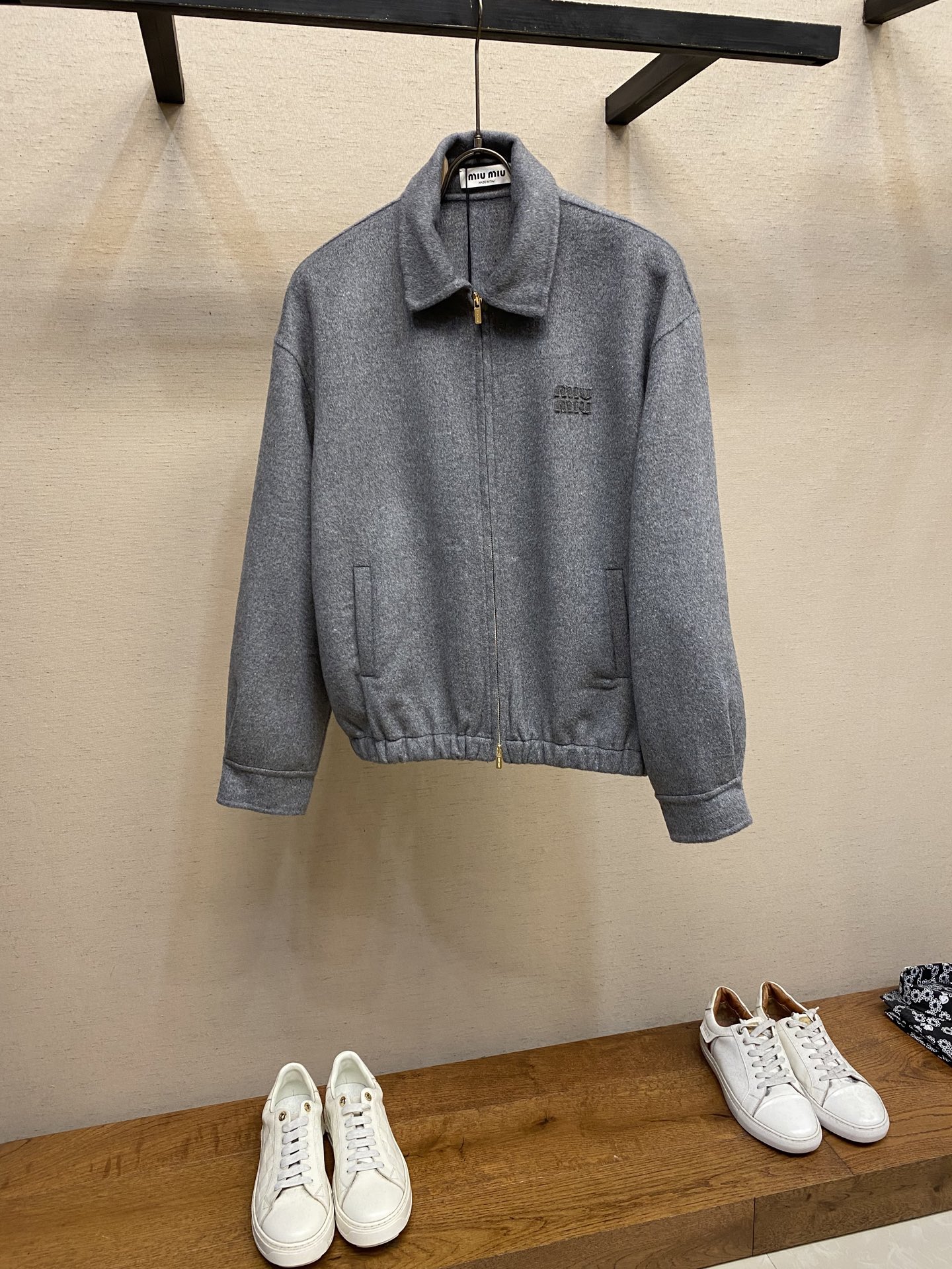 NO:569420,Miu Miu U letter logo double cashmere jacket  Process description Made of high-quality wool fabric, the texture is soft and comfortable, with both warmth and breathability. The jacket is made of double-sided cashmere technology, and the unlined design is more lightweight. The classic shirt-style collar is paired with long-sleeved cuts, and the cuffs are decorated with exquisite button details. The front is closed with a zipper, making it easy and neat to wear. There are welt pockets on both sides, which are both practical and decorative. Clothes  The brand logo is embroidered on the back of the body to highlight the brand recognition. The overall cut is simple and smooth, retaining the tough lines of the traditional jacket, but also showing a low-key elegance through feminine details. The exquisite sewing technology ensures that every seam is smooth and firm, reflecting the brand's strict control of quality. This jacket perfectly blends modern style with classic elements, making it suitable for various occasions.   Size S,M,L,,miumiu,jackets & coats,jackets & coats,shirts,alexander wang19860909Miu Miu U字母徽标双层羊绒夹克外套 工艺说明采用优质羊毛面料制成,质地柔软舒适,兼具保暖性与透气性.外套采用双面羊绒工艺制作,无衬里设计更显轻盈质感.经典的衬衫式领口搭配长袖剪裁,袖口处饰有精致的钮扣细节.前襟采用拉链闭合方式,穿着方便利落.两侧设有嵌线袋,兼具实用性与装饰性.衣身背面刺绣品牌徽标,彰显品牌辨识度.整体剪裁简约流畅,既保留了传统夹克的硬朗线条,又通过女性化的细节处理展现出低调优雅的气质.精湛的缝制工艺确保每处接缝平整牢固,体现了品牌对品质的严格把控.这款夹克将现代风格与经典元素完美融合,适合多种场合穿着. 尺码S,M,L,,miumiu,jackets & coats,jackets & coats,shirts,alexander wang,Men's clothing