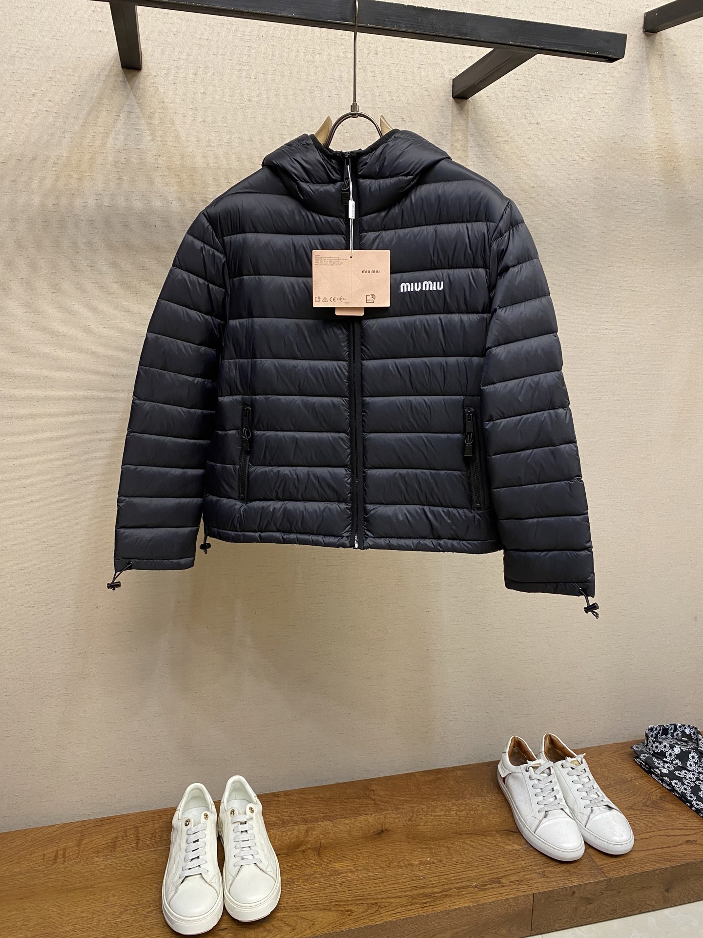 NO:569412,Miu Miu hooded down jacket｜Light protection in winter, details interpret quality] This miumiu hooded down jacket is designed with a classic regular fit, taking into account comfort and neat style, and is suitable for a variety of body shapes. The sleeves are fitted and cut to move freely without restraint. The hooded collar design is not only windproof and warm, but also gives the overall look a casual and sporty atmosphere. The drawstring cuffs fit tightly around the wrist, effectively locking in warmth and wind, and preventing cold wind from pouring in;  The hem is equipped with an elastic drawstring, which can be freely adjusted to further enhance the warmth performance and personalized appearance. The zipper pocket is designed to be safe and practical, convenient for storing belongings; the customized hardware zipper is smooth and durable, and the details highlight the texture. The exquisite 10,000-needle embroidery logo is a low-key embellishment of the brand identity. Fabric selection   Customized high-quality nylon material, although light, its wear resistance is one of the best among all textile fibers, far exceeding natural fibers and even many other synthetic fibers. Nylon fabric also has good elasticity, is not easy to wrinkle, and has good shape retention and other advantages. High-quality filler uses 90 national standard high-quality down, with a filling capacity of 180 grams. It has high loft, strong warmth retention, lightness and no burden, and can easily cope with cold weather.  Whether it is urban commuting or outdoor leisure, this down jacket has become an indispensable luxury item in the winter wardrobe with its excellent performance and simple design. Embroidery technology The logo adopts imported machine embroidery technology, using advanced computer control systems and precision mechanical components to achieve mimiu embroidery operations with high precision, smooth and delicate lines. Sizes S, M, L,, miumiu, jackets & coats, down   jacket,hats,alexander wang19860909Miu Miu 连帽羽绒服｜冬日轻盈守护,细节诠释品质】 这款miumiu连帽羽绒服以经典常规版型设计,兼顾舒适与利落风格,适合多种身形穿着.衣袖采用合身剪裁,活动自如不束缚,连帽领设计不仅防风保暖,更赋予整体造型休闲运动的氛围感. 抽绳袖口紧密贴合手腕,有效锁温防风,避免冷风灌入； 下摆搭配弹性抽绳,可自由调节松紧,进一步提升保暖性能与个性化外观. 拉链口袋设计安全实用,方便随身物品存放；定制五金拉链顺滑耐用,细节处彰显质感. 精致万针刺绣徽标,低调点缀品牌身份. 面料选择 定制高品质尼龙材质,虽然轻盈,但它的耐磨性是所有纺织纤维中最好的之一,远远超过天然纤维甚至其他诸多合成纤维.尼龙面料还具有很好的弹性,不易起皱,保形性好等优点. 高品质填充物 采用90国标高品质羽绒,充绒量达到了180克,蓬松度高、保暖性强,轻盈无负担,轻松应对寒冷天气. 无论是都市通勤还是户外休闲,这件羽绒夹克皆以出色性能和简约设计,成为冬季衣橱中不可或缺的奢华单品 刺绣工艺 徽标采用进口机刺绣工艺,使用先进的计算机控制系统和精密的机械部件,实现mimiu刺绣作业,精度高、线条流畅且细腻. 尺码S,M,L,,miumiu,jackets & coats,down jacket,hats,alexander wang,Men's clothing