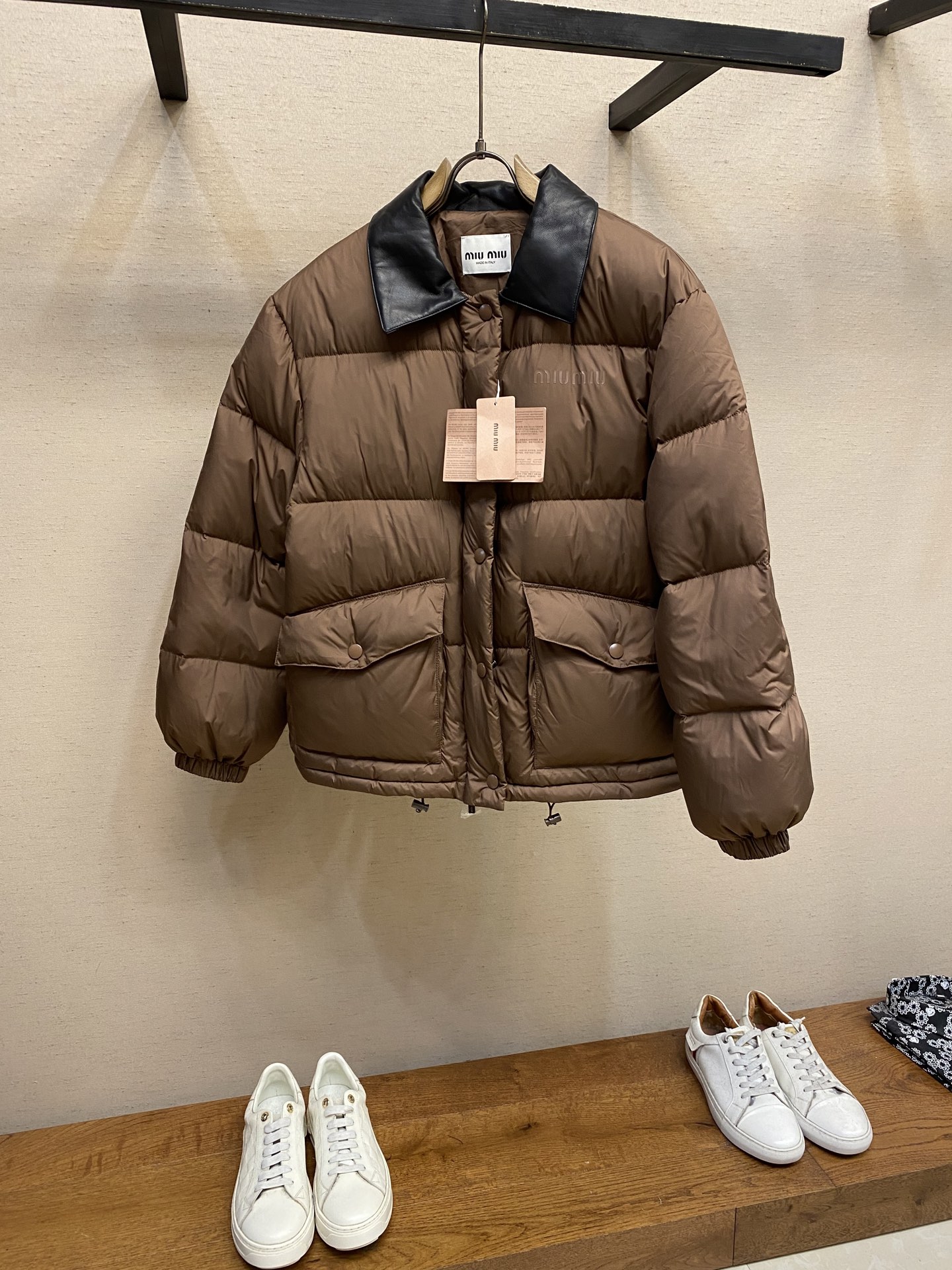 NO:569407,Miu Miu Printed Leather Collar Down Jacket Fabric Selection Made of technical cocoon fabric, which is close to real silk in appearance and comfort. It cleverly combines the comfort and beauty of natural fibers with the sturdiness and durability of synthetic fibers, while avoiding their respective shortcomings. Detailed features: The collar is made of high-quality black leather, which forms a rich visual layering with the body, while maintaining a perfect three-dimensional folding state, creating a clear sense of structure, which is more windproof and wear-resistant than cloth. High-quality filling  It uses national standard 90 white duck down and has a filling capacity of 230 grams to ensure excellent warmth retention. The down has been strictly screened and processed and is not easy to drill, ensuring durability. Printing process   The letter pattern is presented on the chest bag piece through glue printing. The printer scrapes the print 10 times to ensure the printing thickness, forming a micro-three-dimensional convex structure. The scraper pressure is uniform and the firmness is improved. After solidification at high temperature, the pigment is combined with the fabric fiber and is not easy to fall off due to friction. Sizes S, M, L,, miumiu, down jacket, real silk, alexander wang19860909Miu Miu 印花皮领羽绒服 面料选择 选用科技茧绸面料,在美观和舒适度上接近真丝,它巧妙的融合了天然纤维的舒适美观与合成纤维的坚固耐用的优点,同时规避了它们各自的缺点. 细节特点 领口采用优质的黑色皮革材质,和大身形成了丰富的视觉层次感,同时能保持完美的立体翻折状态,塑造出清晰的结构感,比布料更防风,耐磨. 高品质填充物 采用国标90白鸭绒,充绒量达230克 确保保暖性卓越,绒子经过严格筛选与处理 不易钻绒,保证起耐用性. 印花工艺 通过胶浆印花在胸袋片上呈现字母图案,经过印花师10次刮印确保印花厚度,形成微立体凸起结构,刮刀压力均匀,提升牢固度.之后通过高温固化后,颜料与面料纤维结合,不易因摩擦导致脱落. 尺码S,M,L,,miumiu,down jacket,real silk,alexander wang,Men's clothing