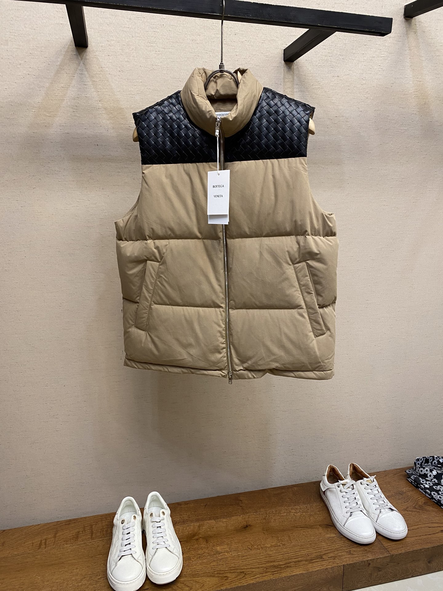 NO:571080,BOTTEGA VENETA Sheep Genuine Leather Woven Down Vest 1. Fabric frosted poplin uses high-density warp and weft yarns to be more closely arranged and form uniform, fine diamond-shaped granular bulges on the surface of the fabric. Advantages This structure gives the poplin fabric a silky gloss because there are many floating threads in the warp and the surface is smooth, which can better reflect light. The refreshing touch is firm and smooth to the touch. Good strength and durability. Fabric finishing  Frosting process: Use cellulase washing to gently and evenly polish the surface of the fabric. Purpose and effect: Eliminate the dazzling luster and grind away some fibers to diffuse light on the surface and improve the touch. The originally smooth poplin surface will produce a layer of extremely fine fluff, making the touch softer, richer and skin-friendly. 2. Leather weaving Intrecciato   Braided leather details Intrecciato is the brand symbol of BOTTEGA VENETA, and its manufacturing process is a combination of extreme manual work and precise calculation. Select top-quality, soft and malleable lambskin 1. Precise cutting · Use a laser cutting machine to accurately cut large sheets of leather into slender leather strips with consistent width and flat edges. The uniformity of each leather strip is the basis for perfect weaving. 2. Core hand-woven ·  This process is usually done by experienced craftsmen and is the soul of Intrecciato. · The braided frame strips are fixed to a specific position on a frame or jacket panel. ·   Seamlessly integrated into the vest, these woven leather parts (such as trims, trims or the entire front panel) are stitched together with the matte poplin main fabric with superb skills to form a complete and three-dimensional decorative structure. High-quality filling is selected from 90 white duck down, weighing 170g, ensuring excellent thermal insulation performance. After strict screening and treatment, the down is not easy to drill, ensuring durability. Sizes S-XL,,bottega veneta,jackets &  coats,down jacket,sheepskin,alexander wang19860909BOTTEGA VENETA 绵羊真皮编织羽绒马甲 一、面料磨砂府绸 采用高密度的经纬纱线 更紧密地排列,且在织物表面形成均匀、细微的菱形颗粒状凸起. 带来的优点这种结构使府绸面料具有 丝滑的光泽感因为经纱浮线多,表面平滑,能更好地反射光线. 清爽的触感质地坚牢,手感滑爽.良好的强度与耐用性. 面料后整理 磨砂工艺 通过纤维素酶洗 对织物表面进行温和、均匀的打磨. 目的与效果 消除耀眼光泽磨掉部分纤维,使表面光线产生漫反射,提升触感让原本滑爽的府绸表面产生一层极其细微的绒毛,触感变得更加柔软、丰润、亲肤.  二、皮料编织Intrecciato 编织皮革细节 Intrecciato 是BOTTEGA VENETA的品牌标志,其制造流程是极致手工与精密计算的结合. 选用顶级、柔软且延展性佳的小羊皮 1.精准切割 · 将大张皮革使用激光切割机,精准地切割成宽度一致、边缘平整的细长皮条.每一根皮条的均匀度是编织能否完美的基础. 2.核心手工编织 · 这个过程通常由经验丰富的工匠完成,是Intrecciato的灵魂所在. · 编织框架皮条会被固定在一個框架或夹克裁片的特定位置上. · 无缝整合在马甲上,这些编织好的皮革部件（如镶边、饰条或整个前幅）会以高超的技艺与磨砂府绸主体面料缝合在一起,形成一个完整且立体的装饰结构. 高品质填充物 选用90白鸭绒,克重达170g,确保保暖性能卓越.绒子经过严格筛选与处理之后,不易钻绒,保证了耐用性. 尺码S-XL,,bottega veneta,jackets & coats,down jacket,sheepskin,alexander wang,Men's clothing