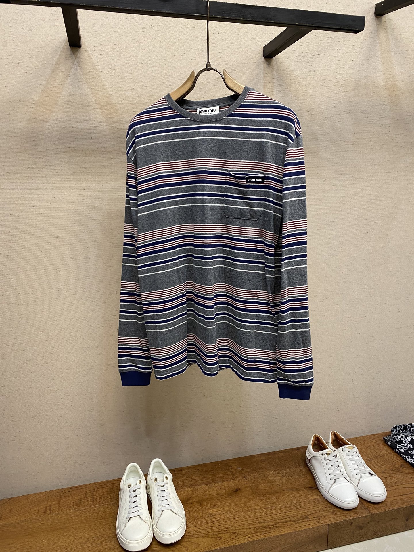 NO:595079,Miu Miu red, white and gray striped round neck long sleeves. Original purchase: 900; jacquard striped knitted fabric, slim fit, round neck short sleeves, logo splicing, double-ended crochet hem, full set of accessories # Jacquard striped knitted fabric, using 24S jacquard striped technology, special textile compact cotton , 185g; with 32S double yarn frame, 380g. The fabric is made of 24-count combed cotton yarn and processed by compact spinning process, which makes the yarn fibers tightly arranged and significantly reduces impurities and hairiness. The fabric structure is denser and smoother, and it not only feels delicate and smooth It is slippery, and its wear resistance and anti-pilling properties are far superior to ordinary cotton fabrics; the weight of the fabric ensures that the fabric has good durability while maintaining the natural breathability and skin-friendly properties of cotton. It is very suitable for spring, summer and transitional seasons, and achieves the unity of comfort and quality. The stripe effect is achieved through the plain knitting technology of alternately knitting colored yarns. This is different from later printing. The color is firm and long-lasting, and the stripe edges are clear and neat. The design that combines simple stripes with the possible jacquard texture of the underlying fabric increases the visual layering, avoids monotony, and embodies the design idea of finding sophistication in simplicity. # Woolen Jacquard Logo Splicing The wool jacquard logo process is a high-end technology that directly weaves the brand logo into the fabric. The warp and weft yarns of the loom are controlled by computer programming, and yarns of different colors are interwoven to form a precise and clear pattern on the surface of the sweater. The jacquard process makes the logo and the logo fabric integrated, with a smooth touch and no bulges, and clear and seamless edges, which greatly improves the comfort and beauty of wearing. # Round neck straight long sleeve version Striped designs often break the rules, with round necks, long sleeves, slightly loose box cuts, and hem lengths above the waistline. The rib material used in the collar, cuffs and other hem parts has a thinner structure than the main fabric yarn, a finer texture, and a smoother feel. This combination ensures that the rib parts are not easy to loosen and deform after long-term wear, and can maintain the crisp silhouette of the garment for a long time. It is a key detail for high-end knitwear to ensure the durability of the pattern. Size XS-L,,miumiu,sweaters,T-shirt,alexander wang19860909Miu Miu 红白灰条纹圆领长袖 原,900购买；提花条纹针织面料、修身版型、圆领短袖、徽标拼接、双头钩针底边、全套辅料配备 # 提花条纹针织面料 采用24S提花条纹工艺特种纺织紧密棉 ,185g；搭配32S双纱拉架,380g.面料选用24支精梳棉纱,并经过紧密纺工艺处理,使得纱线纤维排列紧密、杂质和毛羽显著减少.面料结构更为密实平整,不仅手感细腻光滑,其耐磨抗起球性能也远超普通棉织物；面料克重确保了面料在具备良好耐用性的同时,保持了棉的天然透气与亲肤特性,非常适合春夏及过渡季节穿着,实现了舒适性与品质感的统一. 条纹效果则是通过色纱交替编织的平纹针织技术实现,这与后期印花不同,色彩牢固持久,条纹边缘清晰利落.将简约条纹与可能存在的底层面料提花纹理相结合的设计,增加了视觉的层次感,避免了单调,体现了于简约处见精致的设计思路. # 毛织提花徽标拼接 毛织提花徽标工艺是一种将品牌标识直接织入面料的高端技术.通过电脑编程控制织机经纬纱线,利用不同颜色的纱线交织,在毛衣表面形成精准清晰的图案.提花工艺使徽标与徽标面料浑然一体,触感平整无凸起,边缘清晰无缝合线,极大提升了穿着舒适度与美观度. # 圆领直身长袖版型 条纹设计常打破常规,圆领长袖略宽松的箱型剪裁,下摆长度在腰线以上.领口、袖口等下摆部位使用的罗纹材质；结构比主面料纱线更细,纹理更细腻、手感更柔滑.这种组合确保了罗纹部位久穿不易松弛变形,能长久保持服装的廓形挺括,是高端针织品保证版型持久性的关键细节. 尺码XS-L,,miumiu,sweaters,T-shirt,alexander wang,Men's clothing