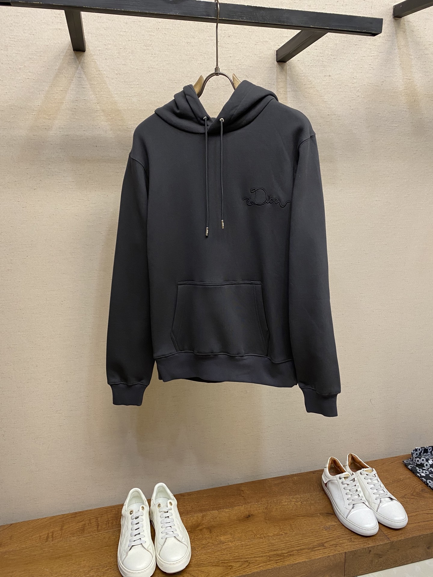 NO:599594,Dior, CD / Ribbon logo hooded sweatshirt. Fabric: 26-count double yarn count terry fabric / 380G. Ribbing: 21-count 2x2 rib / 380G. This sweatshirt is a new product in the 2026 spring men's wear series, decorated with Ribbon  Logo that pays tribute to the craftsmanship of the workshop. Crafted from dark gray cotton fleece with ribbed cuffs and hem. The relaxed silhouette pairs well with oversized trousers.  It adopts a composite structure of 26 double-yarn top and bottom yarn terry, and uses a precision raising process to form a uniform suede on the inside, achieving a velvet-like skin-friendly touch. The heavy weight gives the fabric a sculptural stiffness, perfectly balancing the lazy silhouette and clean lines. The collar/cuffs are made of 21-count 2×2 reinforced ribs, and are woven in both warp and weft directions to form a memory elastic network, ensuring that the original fit can be maintained after multiple wears and takeoffs.  The process uses laser cutting ribbon and micron-level hot-melt composite technology, and is processed through positioning embroidery process. The edges achieve precise seamless fit, and the decorative ribbon is fixed on the chest. Its luster forms a subtle light and shadow dialogue with the cotton matte base, and the version restores the detailed specifications. Sizes XS-L, dior, hoodie, sweatshirts, hats, alexander wang19860909Dior、CD / Ribbon 标志连帽卫衣 面料26支双纱支底纱的毛圈绒面料 / 380G 罗纹21支 2x2 罗纹 / 380G 这款卫衣是二零二六春季男装系列新品,饰以Ribbon 标志,向工坊的精湛工艺致敬.采用深灰色棉质起绒面料精心制作,搭配螺纹袖口和底边.休闲廓形,可与超大版型长裤搭配. 采用26支双纱面层支底纱毛圈的复合结构,通过精密起绒工艺在内侧形成均匀绒面,实现天鹅绒般亲肤触感.重磅克重赋予面料雕塑般挺括感,完美平衡慵懒廓形与利落线条.领口/袖口采用21支2×2强化罗纹,以经纬双向编织形成记忆弹性网,确保多次穿脱仍保持初始贴合度. 工艺采用激光切割缎带与微米级热熔复合技术,通过定位刺绣工艺处理.边缘实现精度的无缝贴合,装饰带固定于前胸,其光泽与棉质哑光基底形成微妙的光影对话,对版还原细节规格. 尺码XS-L,,dior,hoodie,sweatshirts,hats,alexander wang,Men's clothing