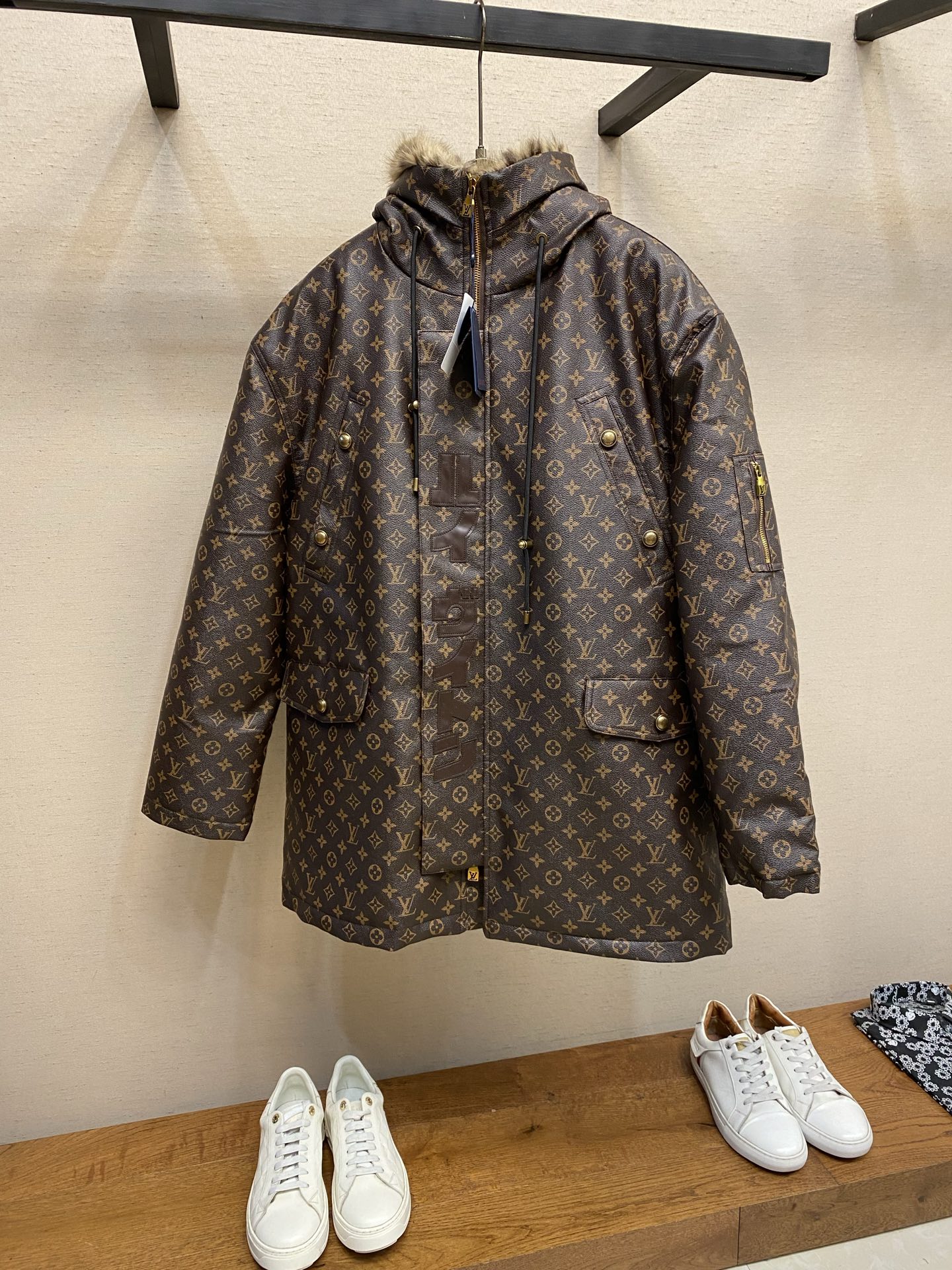 NO:655843,1V letter print hooded jacket  ●Description: This printed jacket is made of embossed leather fabric with a dark brown background and is fully printed with the classic Monogram pattern. The embossing process gives the logo a three-dimensional texture. The edge of the hood is spliced with a natural fur collar, and the brim is equipped with an adjustable drawstring (metal rope buckle) to enhance warmth and style. The placket is double closed with a two-way metal zipper + brass snap button, and the zipper puller and snap button are engraved with the brand logo.  The texture is thick and durable; the body is designed with multiple pockets, the pockets are edged with the same material + metal snap buttons, and the left sleeve is equipped with a hidden adjustment tab. The interior is filled with high-fill down cotton, and the seams are quilted in a diamond pattern to prevent the filling from shifting; the seams are edged with leather of the same color, and the overall routing is precise, taking into account both warmth and luxury. The overall routing is straight and delicate, the fabric is comfortable and soft, and the color is consistent without color difference.  It can be matched with the same style to create a fashionable look, and can be used in various occasions. Customized accessories, complete with three standards, same style for men and women!  Sizes S-XL,,jackets & coats,down jacket,hats,alexander wang198609091V 字母印花连帽派克服 ●描述这件印花外套采用压纹皮革面料,基底为深棕底色,满印经典Monogram图案,压纹工艺让标识呈现立体肌理感.连帽边缘拼接天然毛领,帽檐配可调节抽绳（金属绳扣）,提升保暖性与造型感.门襟采用双向金属拉链+黄铜按扣双重闭合,拉链头及按扣均刻有品牌标识,质感厚重耐用；衣身多口袋设计,袋口用同材质包边+金属按扣加固,左侧袖身设隐藏式调节袢.内里填充高蓬松度羽绒棉,车线采用菱形格绗缝工艺,避免填充物移位；接缝处用同色皮料包边,整体走线精密,兼顾保暖性与奢华质感.整体走线平直细腻,面料舒适柔软,颜色一致无色差 能与同款搭配营造时尚造型,驾驭各种场合,定制辅料,三标齐全,男女同款！ 尺码S-XL,,jackets & coats,down jacket,hats,alexander wang,Men's clothing