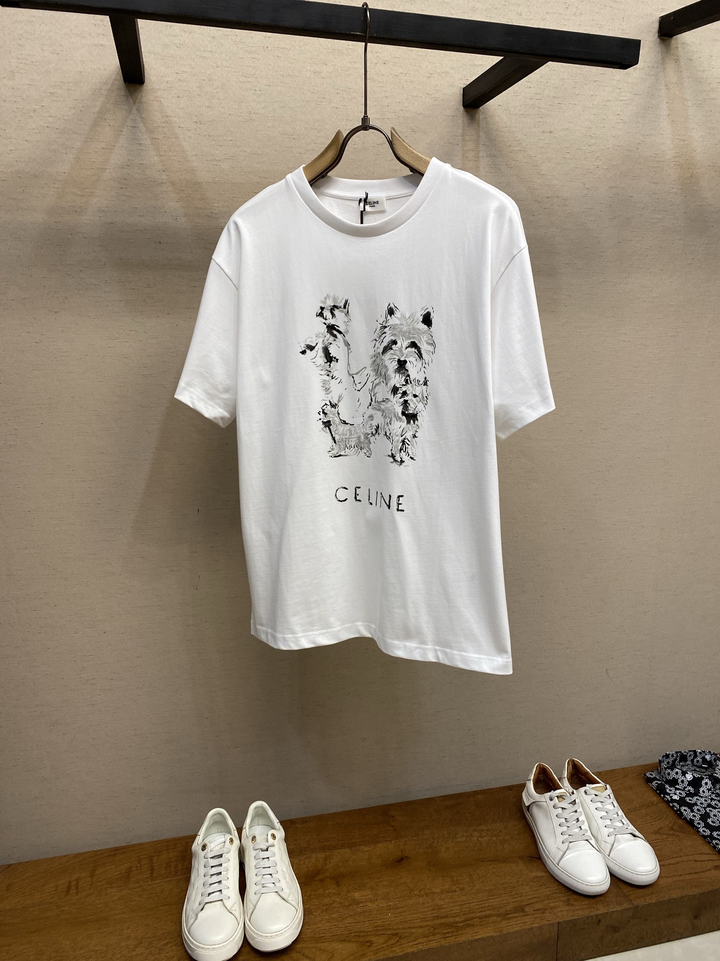 NO:655842,Celine Sketch Puppy Round Neck Short Sleeves Original, purchased for 700, cotton jersey fabric, sketch puppy print pattern, loose fit, standard length, round neck, ribbed collar short sleeves, full set of accessories # Lightweight cotton jersey fabric  Made of 15S fine cotton plain weave fabric, 230g; with 32S double yarn thread, 300g. The plain weave fabric made of cotton fiber processed by combing process, compared with ordinary cotton, its fibers are arranged more neatly and have a higher density, so it has better texture and luster. 15S fine cotton plain weave fabric is a high-quality cotton fabric with the characteristics of softness, comfort, good breathability, and good durability. # Sketch Puppy Print Pattern  Water-based fiber slurry dot printing is an environmentally friendly and sophisticated printing process. It is characterized by using water-based environmentally friendly slurry as the medium, and transferring the slurry to the surface of the fabric in the form of dots through a high-mesh screen. The core of the process is to use high-precision dot distribution to achieve color  The delicate transition and layered expression of colors saves more slurry than traditional full-print printing and has excellent air permeability. Since the water-based slurry does not contain plasticizers, the printed part feels soft to the touch, almost like the original texture of the fabric, without the hardening or sticky feeling of offset printing, and can be better integrated with the fabric fibers.  The printing area presents a matte matte effect, and the color saturation is soft and natural. The tiny gaps between the dots make the pattern visually translucent and hazy, especially on light-colored fabrics. The natural drape and elasticity of the fibers are maintained after the slurry is cured. It has good washability and is not easy to crack or fade. # Simple vertical round neck short-sleeved version  An extremely straight-fit tailoring is developed based on the pattern pattern. The knitted material has a certain stretch performance and the upper body will not be tightly bound. The round neck is stitched with ribs of the same color and the inner back collar is taped to effectively prevent the neckline from deforming after repeated wear and washing. The fitted shoulder line, bottom hem and cuffs are machined and open-stitched. Sizes XS-L,,celine,T-shirt,alexander wang19860909Celine 素描小狗圆领短袖  原,700购买,棉质平纹针织面料、素描小狗印花图案、宽松版型、标准长度、圆领、罗纹衣领短袖、全套辅料配备 # 轻质棉质平纹针织面料 采用15S精棉平纹面料,230g；搭配32S双纱螺纹,300g.采用精梳工艺处理的棉纤维制成的平纹织物,相对于普通棉布而言,它的纤维排列更加整齐、密度更高,因此具有更好的质地和光泽.15S精棉平纹面料是一种高品质的棉质面料,具有柔软舒适、透气性好、耐用性好等特点. # 素描小狗印花图案 水性纤维浆网点印花是一种环保且精细的印花工艺,其特点在于采用水性环保浆料作为介质,通过高目数丝网将浆料以网点形式转印至织物表面.工艺核心在于利用高精度网点分布,实现色彩的细腻过渡和层次表现,相比传统满版印花更节约浆料且透气性优异.由于水性浆料不含塑化剂,印花部位触感柔软近乎织物原生质感,无胶印的硬化或粘腻感,并能与面料纤维较好融合. 印花区域呈现哑光雾面效果,色彩饱和度柔和自然.网点间的微小间隙,图案具备视觉上的半透感与朦胧美,尤其在浅色面料上效果显著.浆料固化后仍保持纤维的天然垂坠与弹性,耐水洗性良好,不易开裂或褪色. # 简约垂直圆领短袖版型 对版纸样开发极简直身剪裁,针织材质具有一定延展性能,上身不会紧紧束身.圆领同色罗纹拼接领口,后领口内贴条工艺,有效防止多次穿洗后领口变形,合身肩线,底摆与袖口专机坎车明线收边. 尺码XS-L,,celine,T-shirt,alexander wang,Men's clothing