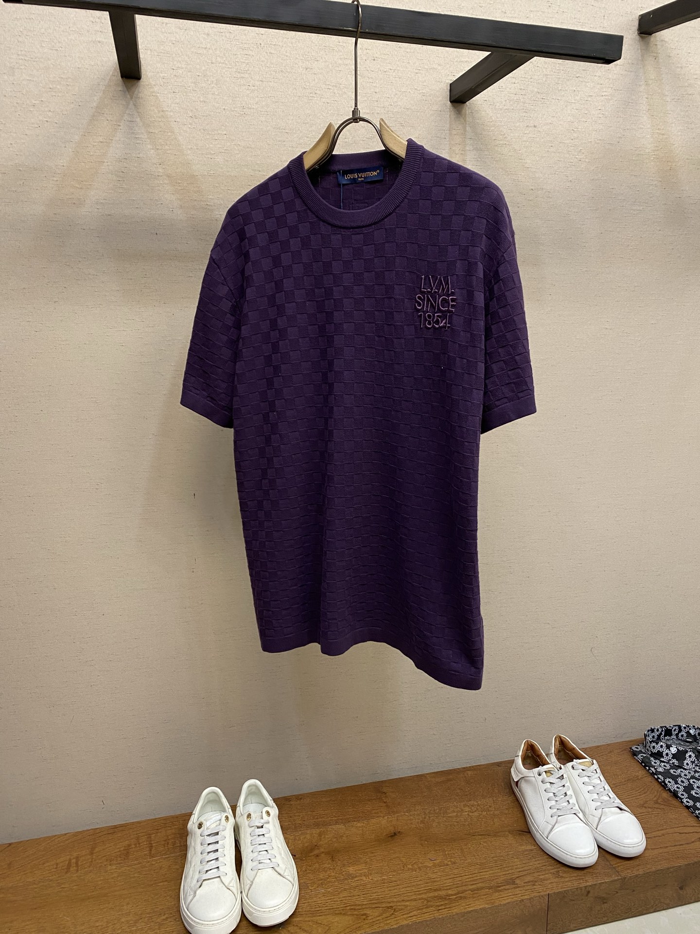 NO:692390,1V/Louis Damier plaid knitted short-sleeved T-shirt 2026ss early spring series The classic Damier checkerboard series design and logo features are dark purple in color, and the body is fully woven with Damier checkerboard three-dimensional knitted texture, which is different from the printed checkerboard, with concave and convex shapes formed by yarn weaving, and 'L.V.M. SINCE' on the left chest  1854' embroidery logo, '1854' is the year the LV brand was founded. The embroidery uses same-color stitches and is highly integrated with the body; there is an LV square leather logo under the neckline on the back.  The material technology is knitted blended fabric (this kind of LV checkerboard knitted T-shirt is commonly made of cotton + mulberry silk/wool blend), which has both softness and stiffness. The short-sleeved version is also suitable for layering in all seasons. The checkerboard texture is woven by a jacquard loom. The checkerboard pattern is uniform in size and three-dimensional, and is not easy to deform or pill. The embroidery part is made of high-density filling embroidery technology, and the edges of the fonts are neat without jumpers. Sizes S-XL, Louis Vuitton, Louis  vuitton,T-shirt,tees,t-shirt,198609091V/路易 Damier格纹针织短袖T恤 2026ss早春系列经典的Damier棋盘格系列设计与标识特征整体为深紫色调,衣身满织Damier棋盘格立体针织纹理,区别于印花棋盘格,由纱线编织形成的凹凸,左胸位置有“L.V.M. SINCE 1854”刺绣标识,“1854”是LV品牌创立年份,刺绣采用同色系线迹,与衣身融合度高；后背领口下方配有LV方形皮革标, 材质工艺采用针织混纺面料（这类LV棋盘格针织T恤常用棉+桑蚕丝/羊毛混纺）,兼具柔软度与挺括感,短袖版型也适合四季叠穿,棋盘格纹理由提花织机织造,格纹大小均匀、纹路立体,不易变形或起球；刺绣部分为高密度填绣工艺,字体边缘工整无跳线. 尺码S-XL,,louis vuitton,louis vuitton,T-shirt,tees，t-shirt,,Men's clothing