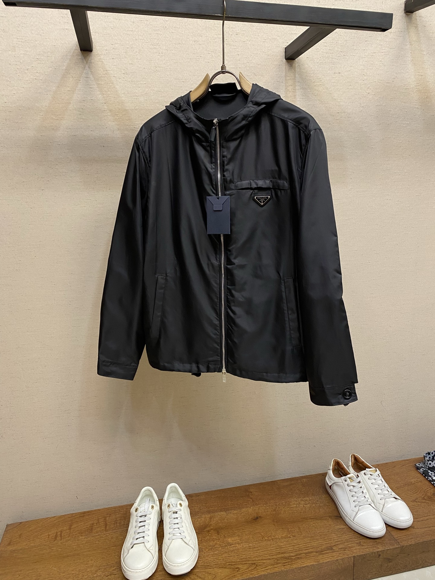 NO:731407,Prada supports after-sales regenerated nylon hooded jackets. Fabric selection: The brand's iconic regenerated nylon fabric is used, which has the same performance as traditional nylon and has high strength, tear resistance, abrasion resistance and other properties. Its texture is light and waterproof, suitable for multiple scene needs. It is anti-wrinkle and quick-drying and is easy for daily care and maintenance. Detail 1  The customized triangle logo is fixed to the body through four 0.8mm metal claw nails. The back of the nail nails is polished by hand to be rounded to avoid scratches. The elastic drawstring at the hem is made of 7-core high-elastic nylon rope with a diameter of 3mm and a rubber buckle, which can achieve ±5cm length adjustment. The drawstring hole is double protected by 'metal eyelets + anti-wear rings'. The inner diameter of the eyelet is 5mm, the edge is smooth and burr-free, and it can be pulled repeatedly for 500 times without deformation. Detail 2  The cuffs adopt a button adjustment system. Two black resin buttons can adjust the cuff circumference ±2cm, adapting to different wrist sizes, ensuring that it fits the wrist without being filled with wind. The straight sleeves are cut strictly in accordance with ergonomics, and the armhole arc is set to 115°, so there is no sense of restraint when moving. Sizes S-XL,, prada, jackets & coats, hats,19860909Prada 支持年后售后再生尼龙连帽夹克 面料选择 选用品牌标志性的再生尼龙面料,与传统尼龙性能相当,具备高强度,抗撕裂,耐磨损等特性.其质地轻盈,同时又具备防水功能适合多场景需求.抗皱,快干的特点也易于日常打理维护. 细节1 定制三角徽标通过4个0.8mm金属爪钉固定于衣身,爪钉背面经手工打磨至圆润,避免刮蹭.下摆弹力抽绳选用7芯高弹尼龙绳,直径3mm,配合橡胶扣,可实现±5cm长度调节.抽绳孔采用「金属鸡眼+防磨环」双重保护,鸡眼内径5mm,边缘光滑无毛刺,反复抽拉500次无变形. 细节2 袖口采用纽扣调节系统,两颗黑色树脂纽扣可调节袖口围度±2cm,适应不同手腕尺寸,确保贴合手腕不灌风.直筒袖剪裁严格遵循人体工学,袖窿弧度设定为115°,活动时无束缚感. 尺码S-XL,,prada,jackets & coats,hats,,Men's clothing