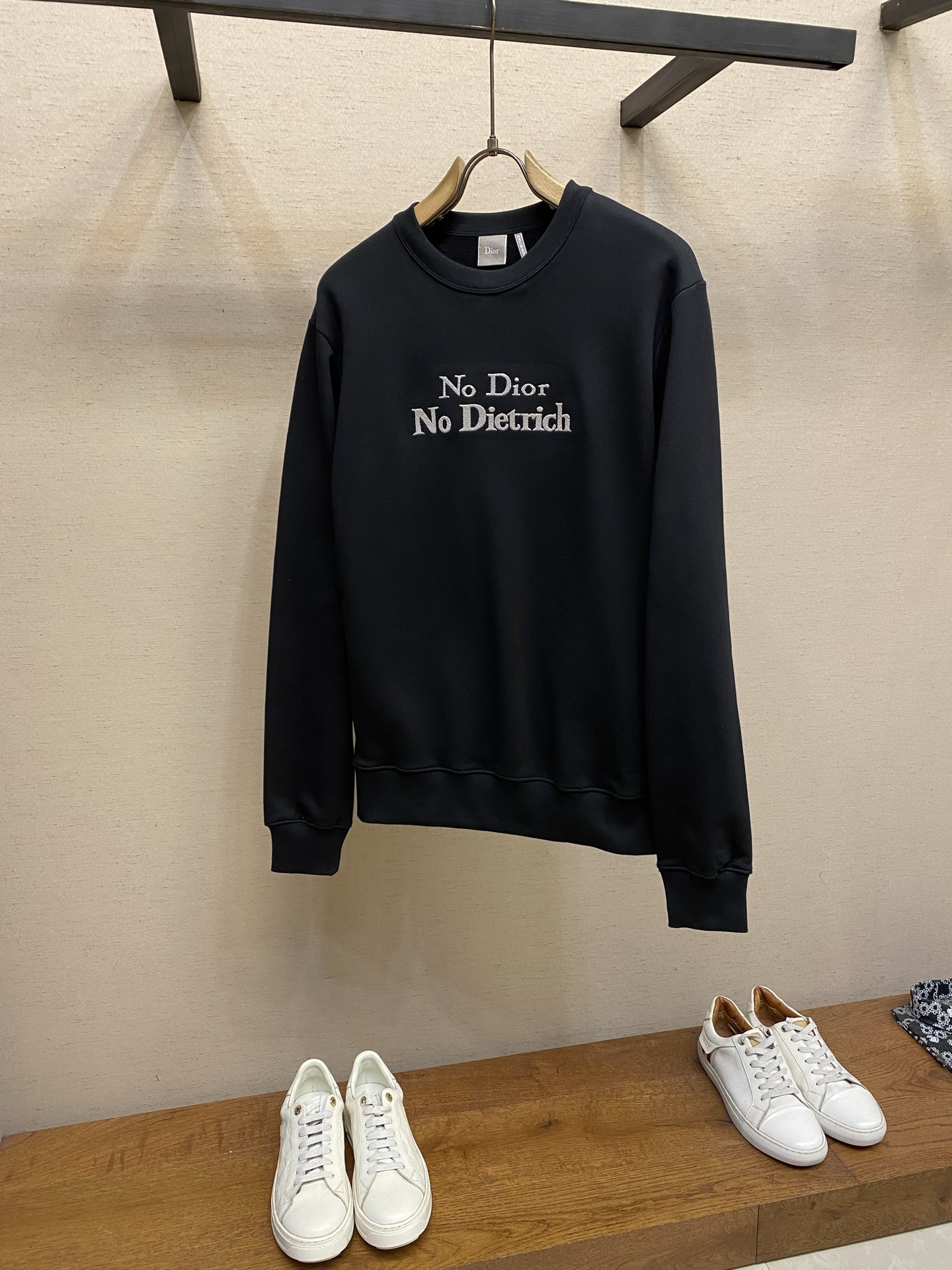 NO:761698,PDior statement embroidered round neck sweatshirt Original purchase; cotton fish scale bottom fabric, twill needle embroidery, regular round neck version, new accessories # fish scale bottom composite structure cotton fabric  It adopts a fleece fabric structure with a 26-count double yarn base and a weight of 380g/㎡; a 21-count 1x1 rib contains 5 spandex and a weight of 470g/㎡. The 26-count double yarn forms a smooth and delicate outer surface of the fabric, ensuring good color fastness. The 10-count yarn base is precision brushed to form a layer of rich, dense skin-friendly fluff on the inside of the fabric, providing excellent warmth retention and soft wrapping.  Paired with equally heavy materials for the neckline, cuffs and hem, its extremely high weight and elasticity brought by spandex ensure the ultimate thickness, stiffness and strong elastic recovery of these closing parts, and together with the body build a full three-dimensional silhouette. The black base provides a deep and high contrast canvas for the white embroidery. # Twill stitch embroidery process  Straight-line embroidery in which stitches are closely connected and evenly arranged is a classic technique for outlining clear outlines and lines. Twill processing means that the arrangement direction of embroidery stitches is not the usual horizontal or vertical direction, but diagonal parallel lines at a specific angle.  Specially selected embroidery threads are used to accurately embroider the text with high-density stitches according to the preset diagonal trajectory, creating text lines with unique texture direction and visual dynamics. The diagonal stitching will produce subtle light and dark changes under the light, enhancing the three-dimensional sense and artistic expression of the text, making it more than just text, but more like a micro-artwork with texture, forming a textural contrast with the smooth and delicate cotton base. # Regular crew neck sweatshirt version  The conventional loose cut is designed with three-dimensional shoulders and rib micro-cinch, and a transparent stabilizing film is implanted at the corresponding position of the embroidery to prevent the deformation of the suede fabric caused by heavy embroidery. The neckline adopts a double-layer rib binding process, with memory elastic yarn embedded inside. All seams are reinforced with six-line overlocking, and the seams are cut and hot-melt sealed to achieve a zero-friction wearing experience. Sizes XS-L, dior, hoodie, sweatshirts,19860909PDior 宣言刺绣圆领卫衣 原购买；棉质鱼鳞底面料、斜纹挨针刺绣、常规圆领版型、新款辅料配备 # 鱼鳞底复合结构棉质面料 采用26支双纱面支纱底的起绒面料结构,克重380g/㎡；21支1x1罗纹含5氨纶,克重为470g/㎡.26支双纱构成面料光滑细腻的外表面,确保良好的色牢度.10支纱底经精密刷绒,在面料内侧形成一层丰厚、浓密的亲肤绒毛,提供优异的保暖性和柔软包裹感. 搭配同样重磅的用于领口、袖口和底边,其极高的克重与氨纶带来的弹性,确保了这些收口部位极致的厚实度、挺括度和强大的弹性恢复力,与衣身共同构建出饱满立体的廓形.黑色基底则为白色刺绣提供了深邃而高对比的画布. # 斜纹挨针刺绣工艺 挨针刺绣针脚紧密相连、排列均匀的直线绣,是勾勒清晰轮廓和线条的经典技法.斜纹处理指刺绣针脚的排列方向并非通常的水平或垂直,而是呈特定的角度的斜向平行线. 使用特选的绣线,按照预设的斜向轨迹,以高密度针脚精准绣出文字,创造出具有独特纹理方向感和视觉动感的文字线条.斜纹针脚在光线下会产生微妙的明暗变化,增强了文字的立体感和艺术表现力,使其不仅仅是文字,更像是一件有肌理的微型艺术品,与光滑细腻的棉质基底形成质感对比. # 常规圆领卫衣版型 常规宽松剪裁通过立体肩部与罗纹微收口设计,在刺绣对应位置植入透明稳定膜,防止重工刺绣导致绒面面料变形.领口采用双层罗纹包边工艺,内部嵌入记忆弹力纱线.所有接缝实施六线锁边加固,缝份经切割与热熔封边,实现零摩擦穿着体验. 尺码XS-L,,dior,hoodie,sweatshirts,,Men's clothing