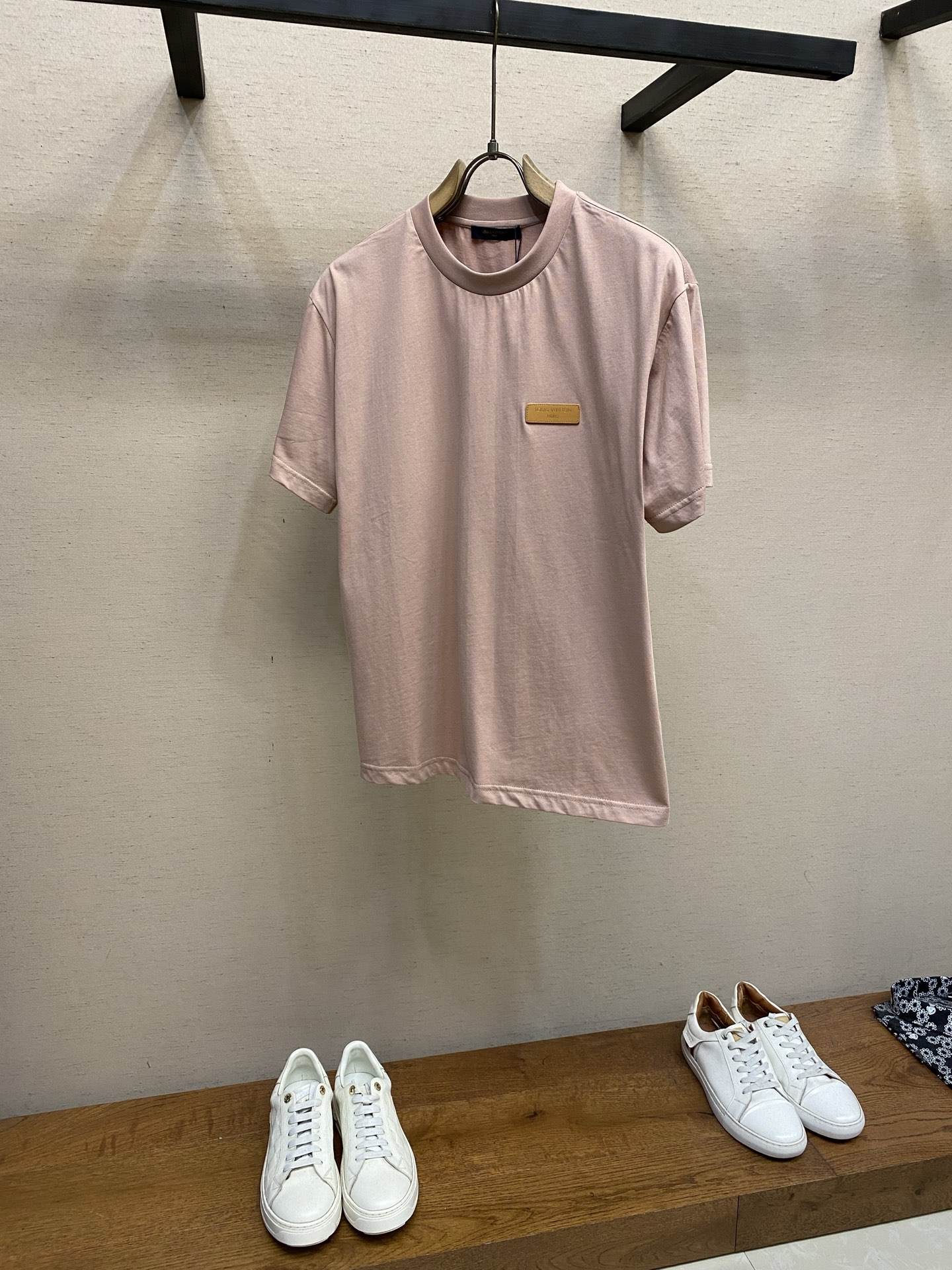 NO:761688,V leather label round neck short sleeves, original cotton fabric, logo leather on the chest, standard fit, ribbed collar, all accessories #cotton jersey fabric  The main body is made of 24S special compact cotton to create a plain knitted fabric with a weight of 180g. The high-count combed cotton yarn eliminates most of the short hairiness through the compact spinning process, making the yarn smoother and stronger. The woven fabric structure is extremely dense, flat and soft, with excellent anti-pilling ability and durability, while retaining the natural advantages of pure cotton being breathable and skin-friendly. The neckline is made of 32S 1x1 rib.  The gram weight is 300g, and finer yarns are woven into more delicate and tight threads, which provide better elasticity and deformation resistance than ordinary ribs, ensuring that the collar can still remain crisp after being worn and taken off many times. # Logo leather patch hot stamping process The leather label is a high-end technology that combines precision imprinting with metal foil transfer. Its core is to permanently imprint and adhere gold or silver metal foil to the leather surface through a high-temperature and high-pressure mold.  The leather is placed on a precision-cut patch base, and through high temperature of 150-180°C and precise pressure, the metal foil is instantly separated from the carrier film and thermally fused with the leather fibers. After the hot stamping is completed, manual trimming and antioxidant coating treatment are required to ensure that the letters are evenly glossy, have no gold overflow on the edges, and are durable and wear-resistant without fading. # Standard round neck version  With a comfortable base of high-quality special woven cotton and a standard versatile fit. The standard fit is designed with a three-dimensional shoulder line and a straight waist. All seams are rolled, the seam width is precise, and the edges are ultrasonically cut to ensure smooth edges without burrs. Sizes XS-L, T-shirt,19860909V 皮标圆领短袖 原,棉质纯棉面料、胸前饰有标识皮革、标准版型、罗纹衣领、全体辅料配备 # 棉质平纹针织面料 主体采用24S特纺紧密棉打造平纹针织面料,克重180g.高支数的精梳棉纱通过紧密纺工艺消除了大部分来短毛羽,使得纱线更光滑、强韧.织成的面料结构异常密实、平整且柔软,具有出色的抗起球能力和耐用性,同时保留了纯棉透气亲肤的天然优势. 领口则选用32S 1x1罗纹 克重300g,更细的纱支编织出更细腻紧密的螺纹,提供了优于普通罗纹的回弹性与抗变形能力,确保领口历经多次穿脱后仍能保持挺括. # 标识皮革贴饰烫金工艺 皮标将精密压印与金属箔转移相结合的高端技艺.其核心在于通过高温高压模具,将金色或银色的金属箔永久性地压印并粘附于皮革表面. 将皮革置于精密切割的贴饰基底上,通过150-180℃高温与精密压力,使金属箔瞬间脱离载体薄膜,与皮革纤维发生热熔融合.烫金完成后,还需进行手工修整与抗氧化涂层处理,确保字母光泽均匀、边缘无溢金,且经久耐磨不褪色. # 标准圆领版型 通过高品质特纺棉的舒适基底,以及标准百搭的版型.标准合身剪裁通过立体肩线与直腰设计,所有接缝采用卷边工艺处理,缝份宽度精确,边缘经超声波切割确保平整无毛边. 尺码XS-L,,T-shirt,,Men's clothing