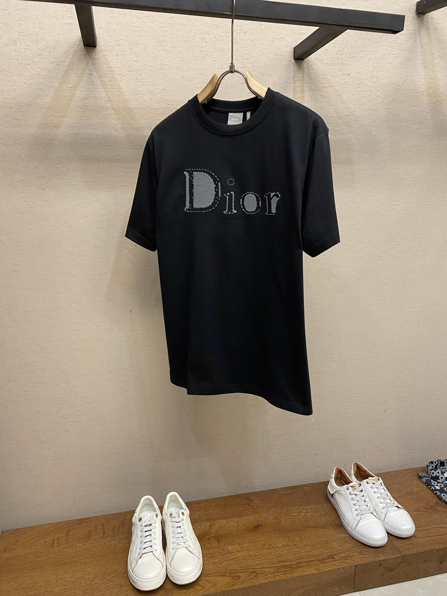 NO:761678,PDior dotted line embroidered round neck short sleeves. Available in black and white colors. Original purchase; cotton plain fabric, dotted line reverse embroidery technology, ribbed round neck, standard short sleeve version, full set of accessories #cotton plain fabric This product is made of  15-count special-spun compact cotton with a weight of 230g/㎡; paired with 32-count high-weight 340g/㎡ 1x1 rib for the neckline. The special-spun compact cotton uses compact spinning technology in the spinning process, which effectively reduces yarn hairiness, making the fabric structure denser, the surface smoother, and the pilling resistance better.  The 230g weight of the fabric is medium to heavy, which ensures the T-shirt has good stiffness and drape, and is not easy to collapse and deform. Its high count and high weight characteristics ensure that the collar has excellent elastic recovery, thickness and deformation resistance, which is a sign of high-quality T-shirts. The solid color base is pure and high-end, providing a perfect canvas for subsequent exquisite embroidery. # Rice grain embroidery + tatami embroidery double combination  The combination of the two is to use the dotted lines of rice grain embroidery on a solid base to construct a pattern that is both three-dimensional and fine, modern and rich in craftsmanship. Tatami embroidery first uses tatami embroidery, using a dense short straight stitch filling embroidery method to build the main background of the pattern or a larger area of color block. Its function is to form a flat, even and thick base embroidery surface, providing a solid sense of volume and a stable structure.  Rice grain embroidery is based on tatami embroidery, using rice grain needle embroidery to present extremely fine dot-like embroidery to outline the dotted detail lines of the pattern. Its function is to create lines composed of continuous micro-convex dots with fine graininess and hand-painted effect, forming a unique dotted line texture. # Standard short-sleeved version  The standard fit tailoring adopts a three-dimensional shoulder line and straight waist design, and a transparent stabilizing film is implanted at the corresponding position of the embroidery to completely solve the shrinkage and deformation of the fabric caused by heavy embroidery. The neckline adopts a double hemming process, and memory elastic yarn is embedded inside. All seams are stitched with three needles and five threads, and the seams are laser cut and hot-melt hemmed to achieve a zero-touch wearing experience. Sizes XS-L, dior, versace, T-shirt, tees, t-shirt,19860909PDior 虚线刺绣圆领短袖 发售色系黑色、白色 原购买；棉质平纹面料、虚线 Reverse 刺绣工艺、罗纹圆领、标准短袖版型、全套辅料配备 # 棉质平纹面料 本品采用 15支特纺紧密棉,克重为230g/㎡；搭配32支高克重340g/㎡1x1罗纹用于领口.特纺紧密棉在纺纱环节应用了紧密纺技术,有效减少了纱线毛羽,使得面料结构更密实、表面更光洁、抗起球性更佳. 面料230g克重属于中等偏重磅,确保了T恤良好的挺括感和垂坠性,不易软塌变形.搭配其高支高克重特性确保了领型极佳的弹性恢复力、厚实感和抗变形能力,是高品质T恤的标志.净色基底纯净而高级,为后续的精湛刺绣提供了完美的画布. # 米粒绣+榻榻米刺绣双结合 两者结合,其作用是在扎实的基底上,通过米粒绣的点状线条,构建出既立体又精细、既现代又富有手工艺温度的图案. 榻榻米刺绣先运用榻榻米绣,以一种密集的短直线针脚填充绣法,构建图案的主体背景或较大面积的色块.其作用是形成平整、均匀且厚实的基底绣面,提供扎实的体量感和稳定的结构. 米粒绣在榻榻米绣的基础上,使用米粒针绣以极细的点状绣呈现,勾勒图案的虚线细节线条.其作用是创造出由连续微凸点构成的、具有精细颗粒感和手绘效果的线条,形成独特的虚线肌理. # 标准短袖版型 标准合身剪裁通过立体肩线与直腰设计,在刺绣对应位置植入透明稳定膜,彻底解决重工刺绣导致的面料收缩变形.领口采用双重包边工艺,内部嵌入记忆弹力纱线.所有接缝实施三针五线绷缝,缝份经激光切割与热熔包边,实现零触感穿着体验. 尺码XS-L,,dior,versace,T-shirt,tees，t-shirt,,Men's clothing