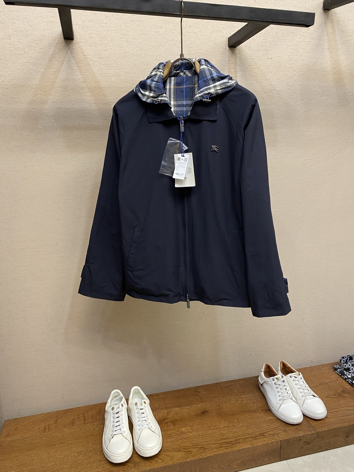 NO:777691,BBR, Burberry reversible hooded jacket. Front fabric selection. Made of high-count lightweight cotton canvas.  , after pre-shrinking and softening, the canvas fabric has got rid of the traditional stiffness and has excellent breathability properties. At the same time, the fabric has a tight structure and strong wrinkle resistance. It is not easy to wrinkle and deform in daily wear. It can still maintain a crisp shape after multiple washings and has full durability. The appearance shows a matte and delicate texture, with a high-end retro texture. The pure black background is low-key and elegant, and is versatile and not picky. On the other hand, fabric selection  The blue plaid fabric made of polyester fiber has a tight structure, strong wear resistance and tear resistance. It is not easy to snag or pill when worn in daily life, and always remains neat and crisp. After lightweight treatment, the upper body is light and weight-free, and has good breathability. Detail 1 The war horse logo on the chest is made of three-dimensional die-casting technology, with a delicate metallic luster, a three-dimensional and full shape, and the edges are polished smooth, showing a high-end texture. Detail 2  The cuffs use double-button tabs with brand logos engraved on the surface of the buttons. The texture is fine and the cuffs can be adjusted freely to fit the wrist to prevent wind. The cuffs can also be folded to reveal the plaid lining to create a layered look. The button tabs are neatly routed and the edges are hemmed. The workmanship is fine, which not only improves the durability of the cuffs, but also makes the overall shape more neat, saying goodbye to the dragging feeling. Detail 3  The hood has a built-in drawstring design and a custom hat rope buckle. The buckle is engraved with a letter logo and has a full texture. The hood can be freely adjusted for tightness, windproof and warm, and has both style and practicality. Detail 4 The raglan sleeve structural design bids farewell to the abrupt shoulder seam of ordinary sleeves. Through precise arc patterning, the sleeve body and the body of the garment are integrated. High-tech diagonal splicing not only modifies the body shape, but also enhances the force ductility of the fabric, so that it will not deform or fray after long-term wear.  Plaid technology Through precise cutting and sewing process, the blue plaid patterns on the hat body, placket and cuffs are completely symmetrically aligned, with neat and smooth lines, without any misalignment or distortion. High-end craftsmanship is demonstrated in the details, and it is visually more refined and regular, highlighting the high-end texture of the classic plaid pattern. Sizes S-XL,, jackets & coats, hats,19860909BBR,博柏利双面穿连帽夹克  正面面料选择 甄选高支轻盈棉质帆布打造 ,经过预缩与柔化处理,帆布面料摆脱了传统硬挺感,其自带优秀的透气属性,同时面料结构紧密、抗皱性强,日常穿着不易起皱变形,多次洗涤仍能保持挺括版型,耐穿度拉满.外表呈现哑光细腻的肌理,自带高级的复古质感,纯黑底色低调大气,百搭不挑风格. 另一面面料选择 选用聚酯纤维打造而成的蓝色格纹面料,其结构紧密,耐磨性、抗撕裂性强,日常穿着不易勾丝、起球,始终保持利落挺括.经过轻量化处理之后,上身轻盈无负重,同时具备良好的透气性. 细节1 胸口处战马徽标采用立体压铸工艺打造,金属光泽细腻,造型立体饱满,边缘经打磨光滑,呈现高级质感.  细节2 袖口采用双扣袢,纽扣表面刻有品牌标识,质感细腻,可自由调节袖口松紧,既能贴合手腕防风,也能翻折袖口露出格纹里布,打造叠穿层次感,扣袢走线工整,边缘包边处理,做工精细,既提升了袖口的耐用性,也让整体版型更利落,告别拖沓感  细节3 连帽内置抽绳设计,搭配定制帽绳扣,扣身刻有字母标识,质感拉满；可自由调节帽围松紧,防风保暖,造型与实用性兼具. 细节4 插肩袖结构设计告别普通袖型的肩缝突兀感,通过精准的弧度打版,让袖身与衣身浑然一体.高工艺的斜向拼接不仅修饰身形,更强化了面料的受力延展性,久穿不变形、不磨边.  对格工艺 通过精准的剪裁和缝纫过程中对格工艺,帽身、门襟、袖口的蓝色格纹完全对称对齐,线条工整流畅,没有错位、歪格,从细节处彰显高端工艺,视觉上更显精致规整,突出经典格纹的高级质感. 尺码S-XL,,jackets & coats,hats,,Men's clothing