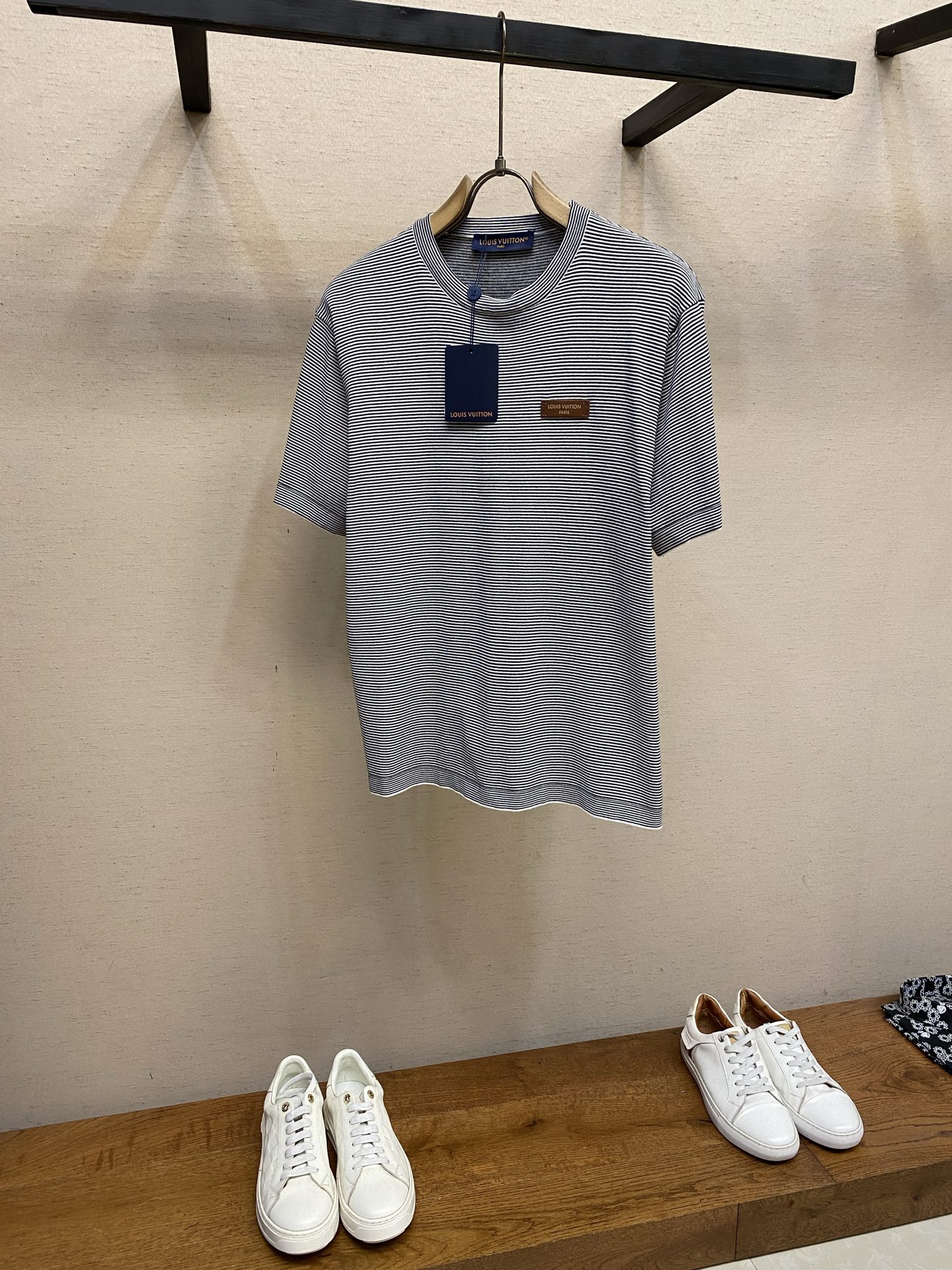 NO:777679,1V, Louis Vuitton leather logo embellished striped short-sleeved T-shirt  Made of imported high-count combed double-ply cotton fabric, the texture is fine and skin-friendly, soft and breathable to the touch, and has excellent drape and wrinkle resistance. The upper body is comfortable and not sweaty, and will not easily deform after long-term wear. It is perfectly suitable for daily commuting and leisure travel. The classic round neck design, with double-layer rib reinforcement technology on the collar, fits the neck without tightening the flesh, and will not become loose after long-term wear. The simple and elegant style is suitable for all kinds of wear.  Wearing scene; The body is made of fine black and white contrasting stripe jacquard craftsmanship. The stripes are even and regular, and the visual layers are rich, breaking the monotony of solid colors and creating a retro and advanced visual effect. The left chest is embellished with the brand's exclusive leather logo, using laser engraving brand LOGO technology. The texture is delicate and eye-catching, and the stitching is fine and neat, which not only strengthens the brand recognition, but also provides  Size S-XL,,louis vuitton,T-shirt,tees,t-shirt,198609091V,路易威登皮标装饰条纹短袖T恤  采用进口高支精梳双股棉面料,质地细腻亲肤,触感柔软透气,兼具出色的垂坠感与抗皱性,上身舒适不闷汗,久穿不易变形,完美适配日常通勤与休闲出行；经典圆领设计,领口做双层罗纹加固工艺,贴合颈部不勒肉,久穿不易松垮,简约大气适配各种穿搭场景；衣身采用细密黑白撞色条纹提花工艺,条纹均匀规整,视觉层次丰富,打破纯色单调感,打造复古高级的视觉效果；左胸位置点缀品牌专属皮质标饰,采用激光雕刻品牌LOGO工艺,质感细腻醒目,针脚细密工整,既强化了品牌辨识度,又为 尺码S-XL,,louis vuitton,T-shirt,tees，t-shirt,,Men's clothing