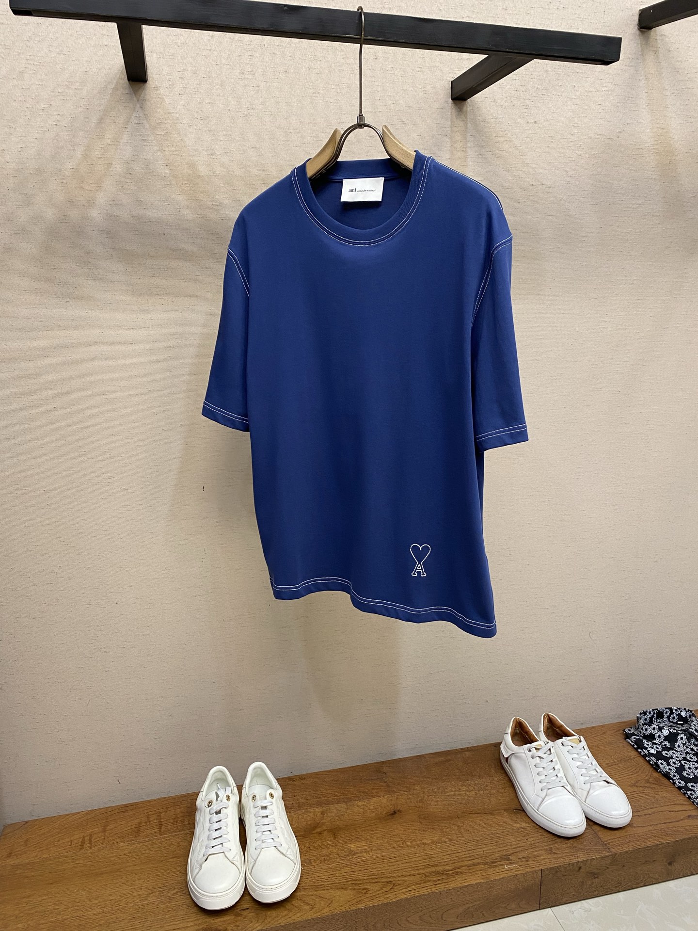 NO:860050,AMI…….Love A Embroidered Short Sleeve Fabric Selection High-count pure cotton is selected, with moderate weight and natural drape. The cotton fiber itself has good moisture absorption and breathability, can quickly absorb sweat and dissipate it outwards. It also feels soft and delicate, and it is close to the skin without any itch when worn. After pre-shrinking process, the washing shrinkage is greatly reduced, and it is not easy to deform after repeated machine washing. Process  1. The advanced computing system of the imported embroidery machine is used to depict the contour lines of the love A pattern. The white embroidery thread and the navy blue fabric form a soft contrast, with neat edges, no skipping lines, and no burrs. The pattern is full and three-dimensional, with a delicate texture. 2. The same color letters are embroidered on the back neckline, and the embroidery thread of the same color as the fabric is used. It is low-key and not obtrusive, and does not destroy the overall simple style. The back of the embroidery product is flat and has no bulges, and will not irritate the skin, taking into account both beauty and wearing comfort.  Sewing details 1. The collar, cuffs, hem, and shoulder lines are all made of contrasting topstitch double-turning technology. The neatly routed threads form a sharp contrast with the navy blue fabric and outline the outline of the clothes. 2. The internal seams of the clothes are processed with overlocking technology, without excess raw edges and threads, and the details are clean and tidy; the hem and cuffs are made of double-folding stitching technology. The edges are smooth and not frizzy, and avoid curling and curling when wearing... Size S-XL, T-shirt,19860909AMI…….爱心A刺绣短袖  面料选择 甄选高支纯棉,自带适中克重与自然垂坠感,棉纤维本身具备良好吸湿透气性,能快速吸收汗液并向外散发,同时触感柔软细腻,贴肤穿着无刺痒感.经过预缩工艺处理之后,大幅降低水洗缩水率,反复机洗也不易变形.  工艺 1采用进口绣花机先进的计算系统描绘出爱心A图案的轮廓线条,白色绣线与藏蓝色面料形成柔和撞色,边缘整齐无跳线、无毛边,图案饱满立体,质感细腻. 2. 在后领口位置做同色字母暗纹刺绣,采用与面料同色系的绣线,低调不突兀,不破坏整体简约风格.刺绣成品背面平整无凸起,不会硌皮肤,兼顾美观与穿着舒适度.  缝纫细节 1领口、袖口、下摆、肩线均采用撞色明线双车工艺,工整走线与藏蓝色面料形成鲜明对比,勾勒出衣服轮廓线条. 2衣服内部接缝均采用锁边工艺处理,无多余毛边、线头,细节干净整洁；下摆、袖口采用双折边车线工艺,边缘平整不毛躁,避免穿着时卷边、起翘. ..... 尺码S-XL,,T-shirt,,Men's clothing