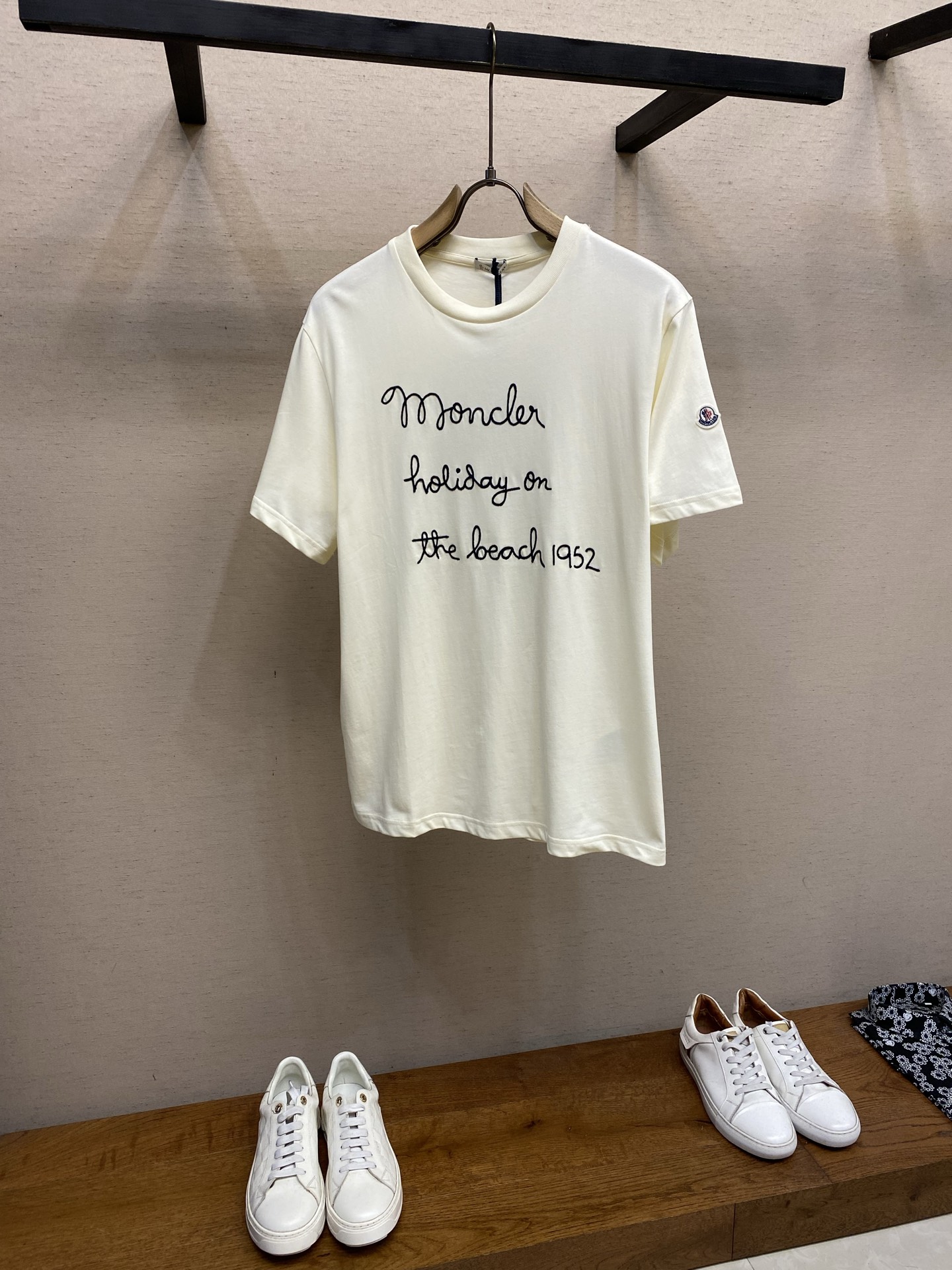 NO:834446,Moncler, Mongolian handwriting style embroidered short-sleeved T-shirt fabric selection. Cotton fiber processed by combing process to remove short lint and impurities. The fabric feels delicate and soft, fitting the skin like a cloud, and there is no itching when worn next to the body. Pure cotton has natural breathable pores, which can quickly absorb sweat on the body surface and evaporate naturally, saying goodbye to sweat and stickiness. Pre-shrunk treatment  The fabric has been pre-shrunk and will not shrink or deform easily after washing. It is equipped with high-fastness seaming technology so that the collar and cuffs will not loosen after repeated wear and washing. At the same time, the cotton fabric has its own anti-pilling properties and will maintain a smooth texture after being worn for a long time. Embroidery process  The handwritten letter embroidery on the chest adopts a double-layer superimposed embroidery process. First, use thin embroidery thread to outline the outline of the letters, and then use double strands of thick embroidery thread to trace the outline for a second depth. The two-layer embroidery superimposition gives the letters a three-dimensional relief texture. It has an obvious concave and convex texture to the touch. Each line is smooth and natural, and the thickness transition is soft, restoring the relaxation and casualness of handwriting. At the same time, the stitch spacing is even and fine, with no skipping or missing stitches, and the embroidery edges are clean and neat. Details  The neckline is reinforced with double-layer ribbing, which fits the neck line without strangulating the neck; the loose and moderate straight version is very tolerant to different body shapes. Sizes S-XL, Moncler, T-shirt,19860909Moncler,蒙口手写风刺绣短袖T  面料选择 采用精梳工艺处理的棉纤维,去除了短绒与杂质,面料触感细腻软糯,像云朵般贴合肌肤,贴身穿毫无刺痒感.纯棉自带天然的透气孔隙,能快速吸收体表汗液并自然挥发,告别闷汗黏腻. 预缩处理 面料经过预缩水处理,水洗后不易缩水、不易变形,搭配高牢度锁边工艺,领口、袖口反复穿洗也不易松垮；同时棉质面料自带的抗起球属性,久穿依旧保持平整质感. 刺绣工艺 胸前的手写风字母刺绣,采用双层叠加刺绣工艺,先以细绣线打底勾勒字母轮廓,再用双股粗绣线沿着轮廓二次描深,两层刺绣叠加让字母自带立体浮雕质感,摸上去有明显的凹凸肌理,每一笔线条都流畅自然,粗细过渡柔和,还原手写体的松弛随性；同时针脚间距均匀细密,无跳线、无漏针,刺绣边缘干净利落. 细节 领口采用双层罗纹加固,贴合颈部线条不勒颈；宽松适度的直筒版型,对不同身材都有很好的包容度. 尺码S-XL,,Moncler,T-shirt,,Men's clothing