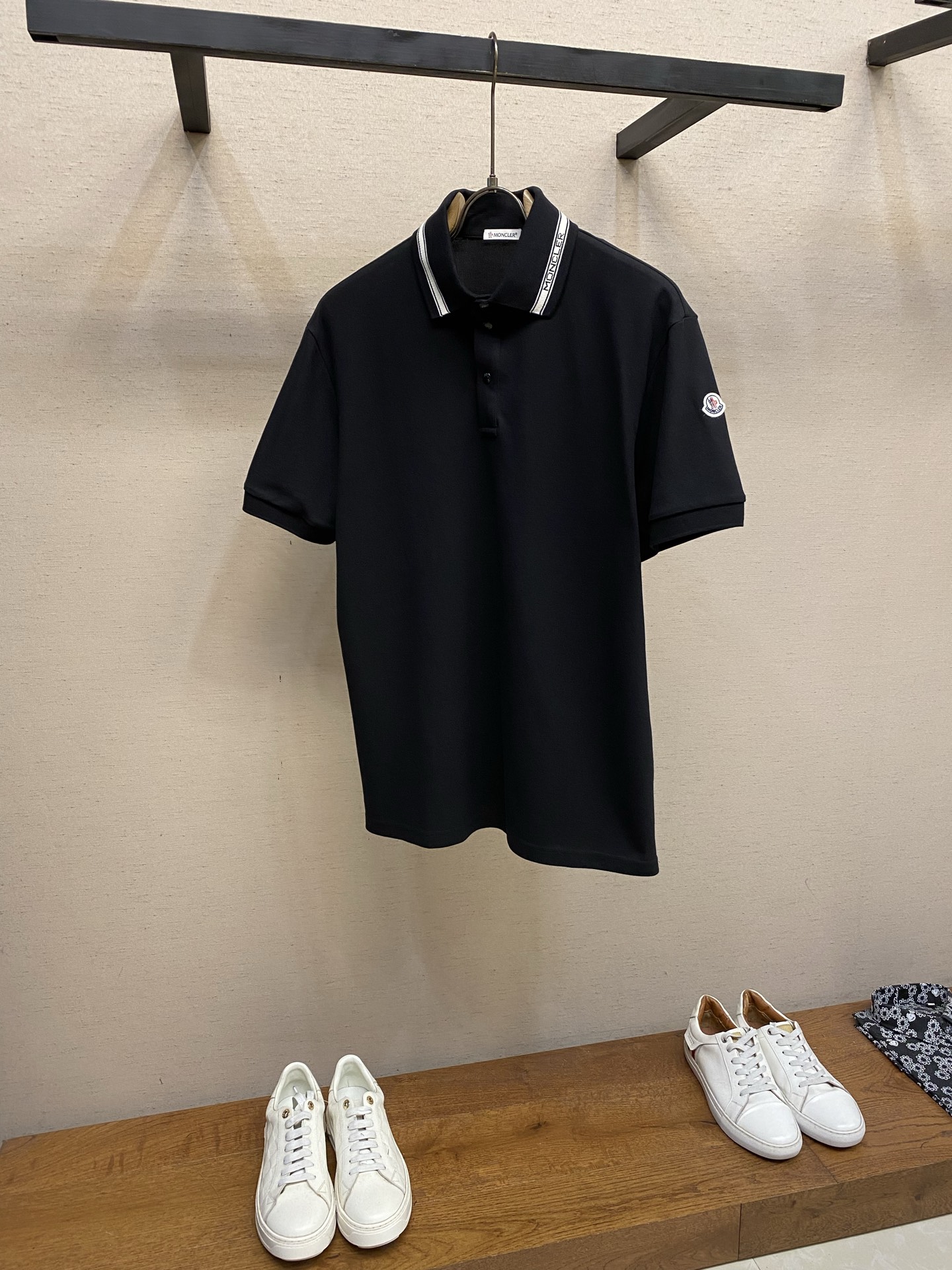 NO:915274,Moncler,, striped monogram POLO shirt fabric selection  The pique mesh fabric is made of cotton as the base and blended with a small amount of polyester fiber. The weight is accurately controlled at 230g/㎡, taking into account both thickness and breathability. The polyester fiber accounts for 10%, which does not destroy the overall skin-friendliness and optimizes the fabric performance. The honeycomb structure forms an air layer to accelerate the evaporation of sweat; the polyester fiber increases the moisture conduction speed, and does not feel sticky when worn in summer. It also improves the stiffness of the fabric and is not easy to collapse and deform. Details of the collar body  It uses cotton + spandex blended yarn and is knitted by a flat knitting machine to form a collar that combines stiffness and stretch resilience. The stripes and letters are woven together through the computer jacquard program of the flat knitting machine before weaving. The yarn automatically changes color with the change of the letter pattern. The letters and the collar surface are seamlessly connected without any trace of post-splicing. Size S-XL,,19860909Moncler,,条纹字母标识POLO衫 面料选择 选用棉为基底喂入少量聚酯纤维混纺而成的珠地网眼面料,克重精准控制在230g/㎡,兼顾厚度与透气性,聚酯纤维占比10,不破坏整体亲肤性,同时优化面料性能.蜂巢状结构形成空气层,加速汗液蒸发；聚酯纤维提升导湿速度,夏季穿着无黏腻感,同时提升面料挺括度,不易软塌变形. 领体细节 采用棉+氨纶混纺纱线,通过横机编织形成兼顾挺括度与拉伸回弹性的领体,条纹与字母在编织之前通过横机电脑提花程序一体织出,纱线随字母图案的变化自动换色,字母与领面无缝衔接,无后期拼接痕迹. 尺码S-XL,,,Men's clothing