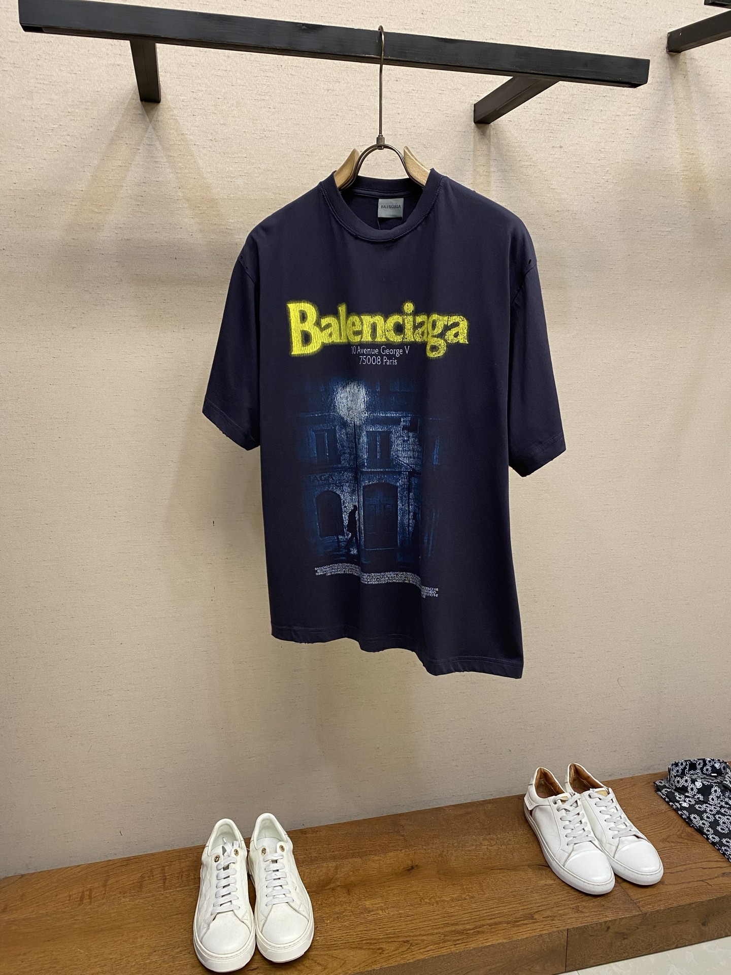 NO:849987,Balenciaga, street lamp print round neck short sleeves. Original purchase; pure cotton vintage plain fabric, decorated with the address artwork print on the front, distressed and faded, mid-profile round neck version, new accessories # pure cotton vintage plain fabric The 24-count special-spun compact cotton is a medium-fine yarn with a thin yarn diameter. The special-spun compact spinning process significantly reduces yarn hairiness, giving the cloth a delicate and slightly matte matte texture. The spun yarn forms a uniform cloth texture in the plain weave, which combines After the hairiness is removed by the compact spinning process, it presents a clean and crisp micro-granular texture, which is neither too smooth like combed cotton nor the obvious texture of coarse yarns. The ultra-high weight ribs combined with 32-count fine yarns make the collar ribs extremely dense and thick. # The front is decorated with the address artwork print, which uses high-density white ink dot printing technology combined with old and faded processing. This is a composite process that pursues the restoration of image details and the rendering of age. The core of high-density white ink dot printing digital direct printing process is to decompose the image into micron-level white ink dots, and print the white ink onto the fabric in the form of ink droplets through extremely high mesh. The high-density white ink dot technology can achieve delicate gradients, shadows and translucency effects, and the resolution of the image is extremely high. The diameter and spacing of each dot are precisely controlled to simulate photo-level grayscale transition and level of detail. Distressing and fading treatment: Put the printed garments into an industrial washing machine and use a slight stone washing process. The surface of the fabric and the edges of the printed pattern will be unevenly stripped of color, resulting in natural fading and an old-fashioned feeling of edge wear. The distressing and fading treatment makes the printed pattern show irregular mottled feelings, cracks and color differences. The center color remains darker, and the edges and raised parts become lighter in color, even revealing the fabric background. Washing hole design. The stone grinding washing process locates the holes. The ready-to-wear products use stone grinding machine laser positioning to manually destroy the wear effect. Every frayed area is purely handmade, so that the natural wear of the fabric achieves the most harmonious visual effect. After stone grinding and washing, it can show a rich retro texture. # Mid-profile round neck version This short-sleeved version adopts a mid-profile round neck version, that is, a slightly loose cut. The shoulder line slightly exceeds the acromion point, showing a slight shoulder drop effect; the body is straight cut, and the bust and hem circumferences are similar, creating a moderately relaxed wearing feel, between the standard version and the loose version. Ribbing is the key balancer of this version. The high-weight and dense ribs play a visual convergence role at the neckline to avoid the baggy feeling caused by the slightly loose body. Size XS-L,,balenciaga,T-shirt,19860909Balenciaga,街灯印花圆领短袖 原购买；纯棉质复古平纹面料、正面饰以the address艺术作品印花、做旧褪色处理、中廓形圆领版型、新款辅料配备 # 纯棉质复古平纹面料 24支特纺紧密棉属于中细纱支,纱线直径较细.特纺紧密纺工艺显著减少了纱线毛羽,使布面呈现出细腻且微雾面的哑光质感.细纱在平纹组织中形成了均匀的布面纹理,结合紧密纺工艺去除毛羽后,呈现出一种干净利落的微颗粒感,既不是精梳棉的过分光滑,也不是粗纱支的明显肌理,32支细纱配合的超高克重罗纹,使得领口罗纹极其致密且厚重. # 正面饰以the address艺术作品印花 采用了高密度白墨网点印花技术结合做旧褪色处理,这是一套追求图像细节还原与年代感渲染的复合工艺. 高密度白墨网点印花数字直喷工艺制作,其核心在于将图像分解为微米级的白墨网点,通过极高的网目将白色墨水以墨滴形式印刷到面料上.高密度白墨网点技术能够实现细腻的渐变、阴影和半透明效果,图像的解析力极高.每个网点的直径和间距被精确控制,以模拟照片级的灰度过渡和细节层次. 做旧褪色处理将印花后的成衣放入工业水洗机,采用轻微石洗工艺处理.面料表面和印花图案边缘会被不均匀地剥离颜色,形成自然落色、边缘磨损的陈旧感.做旧褪色处理使得印花图案呈现出不规则的斑驳感、裂纹和色差.中心颜色保留较深,边缘和凸起部位颜色变浅、甚至露出面料底色. 洗水破洞设计石磨洗水工艺定位破洞处理,成衣制品采用石磨机激光定位手工破坏磨损效果.每一处磨损处纯手工打造,使面料的自然磨损达到最和谐的视觉效果,通过石磨洗水后能够呈现出浓郁的复古质感. # 中廓形圆领版型 这款短袖采用中廓形圆领版型,即微宽松剪裁.肩线略微超过肩峰点,呈现轻微落肩效果；衣身呈直筒剪裁,胸围与下摆围度相近,营造出适度松弛的穿着感,介于标准版与宽松版之间.罗纹是本款版型的关键平衡器,高克重致密罗纹在领口处起到视觉收敛作用,避免因衣身微宽松而产生松垮感. 尺码XS-L,,balenciaga,T-shirt,,Men's clothing