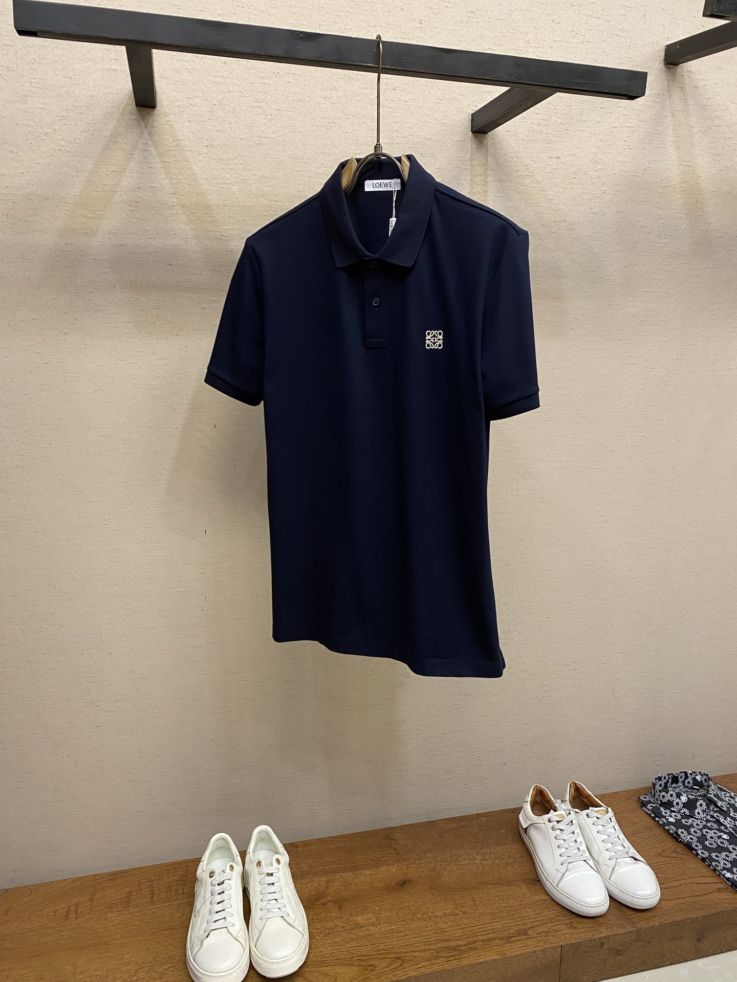NO:912477,Loewe, navy blue classic logo embroidered short-sleeved T-shirt Polo shirt is made of high-count piqué cotton, with a solid texture, breathable and dry, with a crisp drape and skin-friendly comfort. It is suitable for various scenes in spring and summer. The neat lapels are paired with a two-button placket, the fit is loose and not tight, and the side slit hem optimizes freedom of movement;  The iconic Anagram embroidery on the left chest, with dense and three-dimensional stitching, is low-key and releases brand recognition. The calm navy blue color is versatile and resistant to any skin tone. It can be used from business commuting to daily leisure. It is an essential wardrobe item that combines style and practicality. It calmly interprets the minimalist and advanced dressing aesthetics of modern men. Sizes XS-XL, loewe, T-shirt, tees, t-shirt,19860909Loewe,,藏青色经典标刺绣短袖T恤Polo衫 甄选高支珠地棉织造,肌理扎实透气干爽,兼具挺括垂坠感与亲肤舒适体验,适配春夏多场景穿搭.利落翻领搭配两粒扣门襟,版型宽松不紧绷,侧开叉下摆优化活动自由度； 左胸标志性Anagram刺绣,针脚密实立体,低调释放品牌辨识度.沉稳藏青色百搭耐看不挑肤色,从商务通勤到日常休闲皆能驾驭,是兼顾格调与实穿性的衣橱刚需单品,从容诠释现代男士极简高级的穿搭美学. 尺码XS-XL,,loewe,T-shirt,tees，t-shirt,,Men's clothing