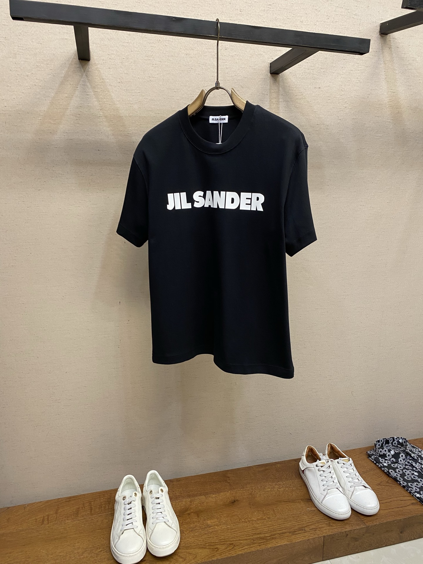 NO:912478,,, JIL SANDER's classic letter-printed short-sleeved T-shirt continues JIL's signature minimalist aesthetics, abandons complicated designs, and only uses eye-catching brand letters to create recognition. It is low-key and has its own high-end aura. It is a versatile T-shirt that can be worn by both men and women and is suitable for all scenes. It is easy to wear with a relaxed texture. The fabric is made of high-weight combed cotton, with a fine and firm texture, soft and skin-friendly, and the upper body is breathable and does not make you sweaty;  1. Visually printed three-dimensional matte offset printed brand characters on the front. The fonts are neat and neat, with strong adhesion and strong adhesion and are not easy to crack and fall off. The black and white contrasting colors are classic and durable, and the simplicity highlights the brand style. 2. The neckline is made of reinforced ribbed round collar, which is not easy to loosen and deform after repeated pulling. The double-stitch seam stitching is precise and regular, fits the neck without tightening the skin, and maintains a rounded shape even if worn for a long time. 3.  The stitching details on the cuffs and hem adopt neat double-needle close-copying technology, which ensures uniform and firm stitching and enhances the structural stability of the body. The details show the level of high-end garments. Sizes XS-L, jil sander, T-shirt, tees, t-shirt,19860909,,JIL SANDER经典字母印花短袖T恤 延续JIL标志性极简主义美学,摒弃繁杂设计,只用醒目品牌字母打造辨识度,低调又自带高级气场,是男女通穿、适配全场景的百搭神T,轻松拿捏松弛质感穿搭. 甄选高克重精梳棉织造,面料肌理细腻紧实,触感软糯亲肤,上身透气不闷汗； 1. 视觉印花正面立体哑光胶印品牌大字,字体利落工整,附着力强不易开裂脱落,黑白撞色经典耐看,简约中凸显品牌格调. 2. 领口做加固罗纹圆领,反复拉扯不易松垮变形,双车线锁边走线精密规整,贴合颈部不勒肤,日常穿久也保持圆润版型. 3. 车线细节袖口与下摆采用工整双针密拷工艺,走线均匀牢固,增强衣身结构稳定性,细节处尽显高端成衣水准. 尺码XS-L,,jil sander,T-shirt,tees，t-shirt,,Men's clothing