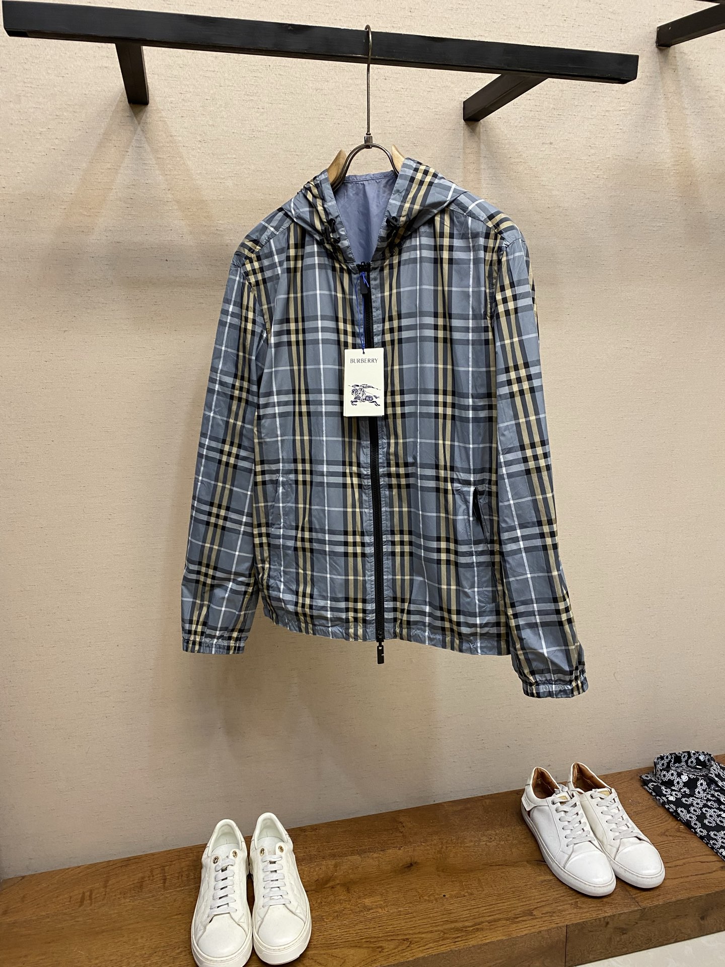 NO:947059,BBR, side-wear plaid hooded jacket. Fabric selection: The two sides are made of polyester fiber plaid fabric and polyamide solid color fabric. Both fabrics are made of high-density plain weave technology. The yarns are fine and tight, and the cloth surface is smooth with a delicate matte soft texture. It is light and weightless.  The plaid polyester fiber surface uses reactive digital printing technology. The plaid lines are symmetrical and regular, and the color is stable and not easy to fade or turn white when washed. The inner solid-color polyamide fabric feels soft and smooth, skin-friendly and does not rub the skin. The breathable microporous weaving takes into account ventilation, making it not sweaty when worn in spring and summer. It also has excellent tear resistance and pull resistance. Repeated folding is not easy to produce permanent creases, and it remains smooth and stylish after long-term wear. Technology  It adopts double-layer cut-piece alignment lock stitching technology, and the inner and outer sides are independently and completely cut. The placket, hat body, body, and pockets are all double-sided and synchronously cut and sewn. The edges adopt a hidden hemming process, and there are no unnecessary raw edges or jumpers on the inside or outside. Both sides have a smooth and exquisite garment texture, and there is no exposed lining or misaligned pieces. Details  1. Equipped with a customized two-way metal nylon zipper, the teeth bite tightly and smoothly, and can be opened and closed in both directions up and down; the edge of the zipper is reinforced with double-layer fabric overlocking, which makes it difficult to collapse or get stuck after repeated pulling, and the zipper track is straight and neat.  2. The whole one-piece hood, with multiple clear lines on the hat body to separate and shape, is not easy to collapse and deform; the cap opening and hem are equipped with a drawstring made of the same material with a custom plastic buckle lock, and the buckle is engraved with a letter logo, which can be freely tightened and adjusted to prevent wind and temperature. 3. An oval silicone knight logo patch is sewn on the outside of the solid color fabric, and a three-dimensional war horse pattern is molded.  coats, hats,19860909BBR,,面穿格纹连帽外套 面料选择 两面分别采用聚酯纤维格纹面料、聚酰胺纯色面料,两种面料均采用高密平纹梭织工艺打造,纱线细密紧实,布面平滑带有细腻哑光柔光质感,轻薄无负重. 格纹聚酯纤维面层采用活性数码印花工艺,格纹线条对称规整,色彩固色稳定,水洗不易晕色、发白；内里纯色聚酰胺面料手感软糯顺滑,亲肤不摩擦肌肤,透气微孔织造兼顾通风性,春夏穿着不闷汗,同时具备优异抗撕裂、耐拉扯特性,反复折叠不易产生永久折痕,长久穿着依旧平整有型. 工艺 采用双层裁片对位锁缝工艺,内外两面独立完整裁片,门襟、帽身、衣身、口袋全部双面同步裁片车缝,边缘采用隐藏式包边工艺,内外均无多余毛边、跳线,正反两面穿着都拥有平整精致的成衣质感,无内衬外露、裁片错位问题. 细节 1、配置定制双向金属尼龙拉链,齿牙咬合紧密顺滑,可上下双向开合；拉链边缘双层布料包缝加固,反复拉合不易崩线、卡齿,拉链轨道走线平直工整. 2、整片一体式连帽,帽身多道等分明线分割定型,不易软塌变形；帽口、衣摆均配备同料抽绳搭配定制塑料卡扣锁扣,卡扣刻印字母标识,可自由收紧调节围度,防风锁温. 3、纯色面料外侧缝制椭圆形硅胶骑士徽标贴饰,模压立体战马图案,高温车缝四周锁边,不易脱落翘边. 尺码S-XL,,jackets & coats,hats,,Men's clothing