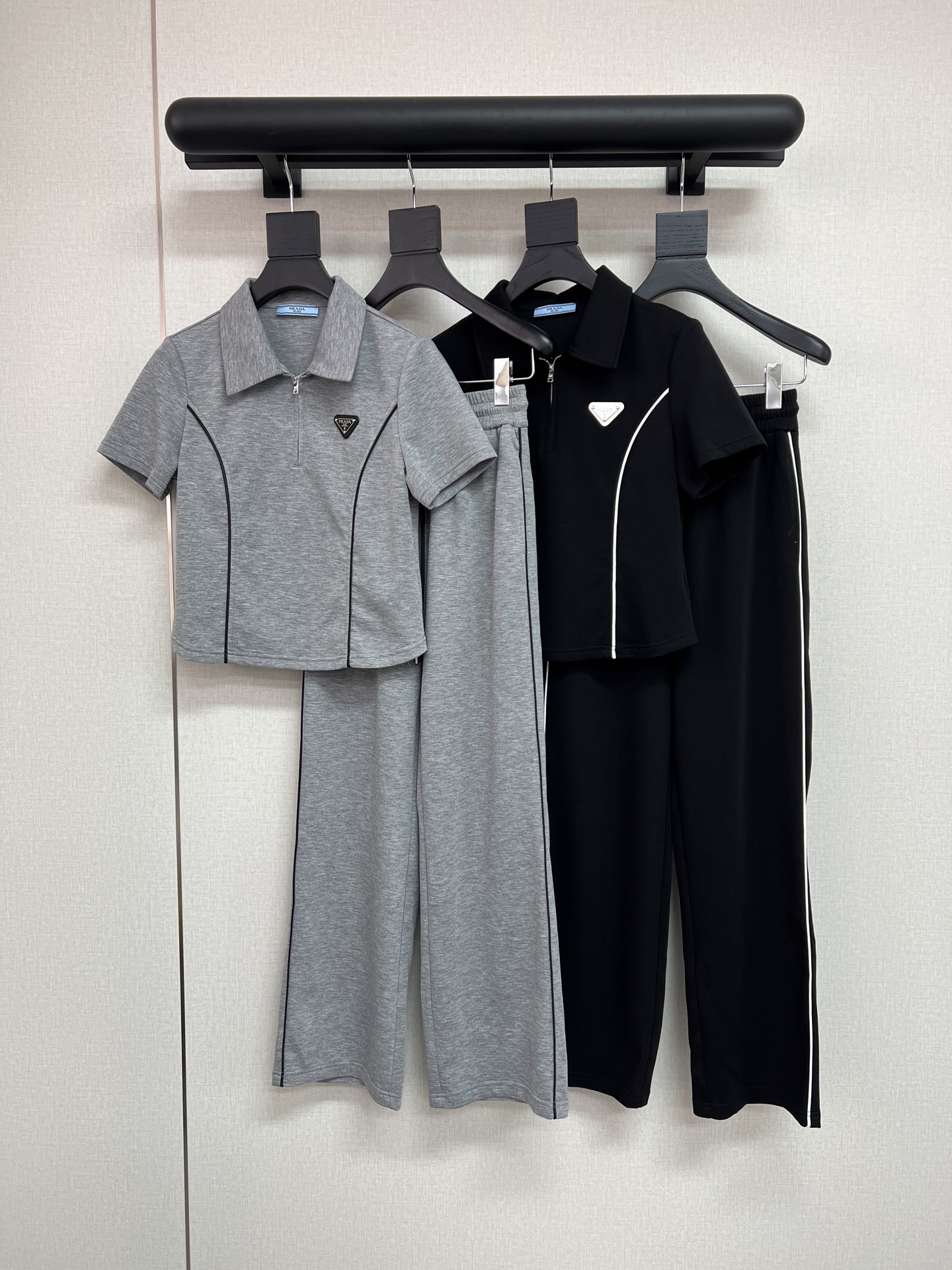 NO:747906,High-quality PRADA 2026 summer new high-end casual contrasting color splicing sports suit, the classic triangle brand on the chest is decorated with high-end air layer fabric, which is the temperament in summer. The zipper lapel short-sleeved top is neat and slim, with a casual and sassy feel; the wide-leg pants version hides the flesh and shows the length of the legs, and can be carried when walking  Light aura. The overall design is simple but not ordinary and has a high-end style. Wear it out in summer, whether it is sports, shopping or dating, you can easily wear it to look slim and sleek, with both comfort and style. High-quality black and gray SML, prada, T-shirt,19860909高品质PRADA2026夏季新款高级感休闲撞色拼接运动套装,胸前经典三角牌装饰高端空气层面料,这是夏日里的气质担当.拉链翻领短袖短款上衣利落显瘦,自带随性飒感；阔腿裤版型藏肉显腿长,走动间带起轻盈气场.整体设计简约却不普通休闲中藏着高级范儿.夏日穿它出门,无论是运动、逛街还是约会,都能轻松穿出洋气显瘦的利落气质,舒适与格调两不误.高品质黑色灰色SML,,prada,T-shirt,,Women's clothing