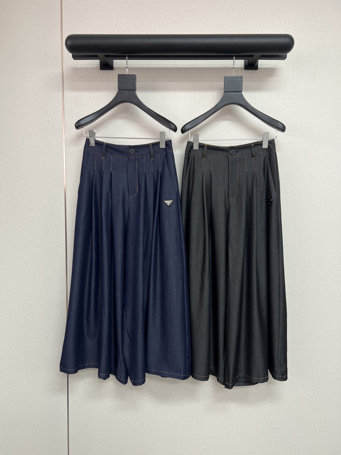 NO:753897,High-quality PRADA 2026 spring and summer new imitation denim fabric pants skirt with classic triangle decoration. This nine-point imitation denim fabric pants skirt hides the dual temperament of casualness and neatness. The imitation denim texture has a retro accent, which not only has the coolness of denim, but is also lighter and more comfortable than traditional denim; the nine-point length exposes the ankles, quietly showing off  High, pants and skirts are designed to take into account the convenience of trousers and the flexibility of skirts. Paired with a T-shirt for daily use, it is a vigorous and casual style, and paired with a shirt, it adds a bit of coolness. It can easily handle a variety of occasions, comfortable and stylish. Blue and black SML, prada, skirts, shirts, tees, t-shirt,19860909高品质PRADA2026春夏新款仿牛仔面料裤裙经典三角牌装饰、这条仿牛仔面料九分裤裙,藏着随性与利落的双重气质.仿牛仔纹理自带复古腔调,既有牛仔的酷感,又比传统牛仔更轻盈舒适；九分长度露出脚踝,悄悄显高,裤裙设计兼顾裤装的方便与裙装的灵动.日常配T恤是元气休闲风,搭衬衫则添几分飒爽,轻松驾驭多种场合,自在又有范儿.蓝色黑色SML,,prada,skirts,shirts,tees，t-shirt,,Women's clothing