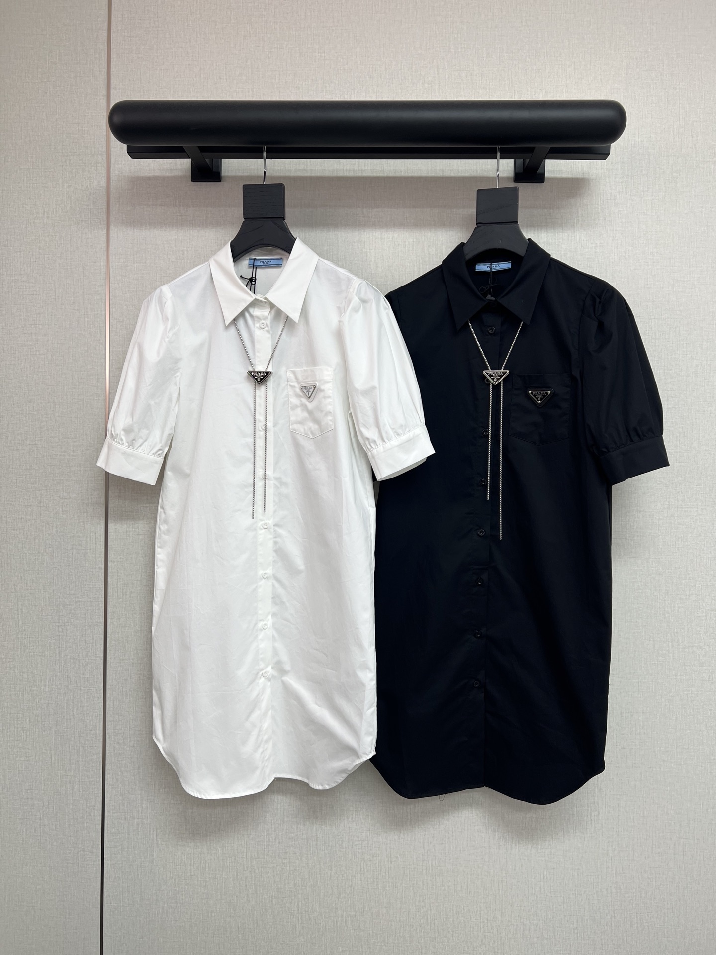 NO:845629,High-quality PRADA 2026 new summer style [short-sleeved puff sleeve shirt dress | sweet but not greasy French feel] triangle logo decoration on the chest, triangle logo pendant necklace, super recognizable. The neatness of the shirt collar meets the playfulness of the puff sleeves. The length of the short sleeves is suitable for spring and summer. It hides the meat and is refreshing and not stuffy; the skirt is drooping with an A-shaped arc, and it feels like being gently supported by the wind when walking.  Paired with white shoes, she will look like a energetic girl. She can wear them every day and even breathe with a sense of lightness ~ pure cotton fabrics of high quality sml, prada, skirts, shirts, T-shirts, necklace,19860909高品质PRADA2026夏季新款【短袖泡泡袖衬衫裙｜甜而不腻的法式感】胸前三角标装饰配饰三角标吊坠项链超有辨识度 衬衫领的利落撞上泡泡袖的俏皮,短袖长度适配春夏,藏住拜拜肉清爽不闷热；裙摆垂顺带点A字弧度,走动时像被风轻轻托着 配小白鞋是元气少女,日常穿出门,连呼吸都带着轻盈感～纯棉面料高品质sml,,prada,skirts,shirts,T-shirt,necklace,,Women's clothing