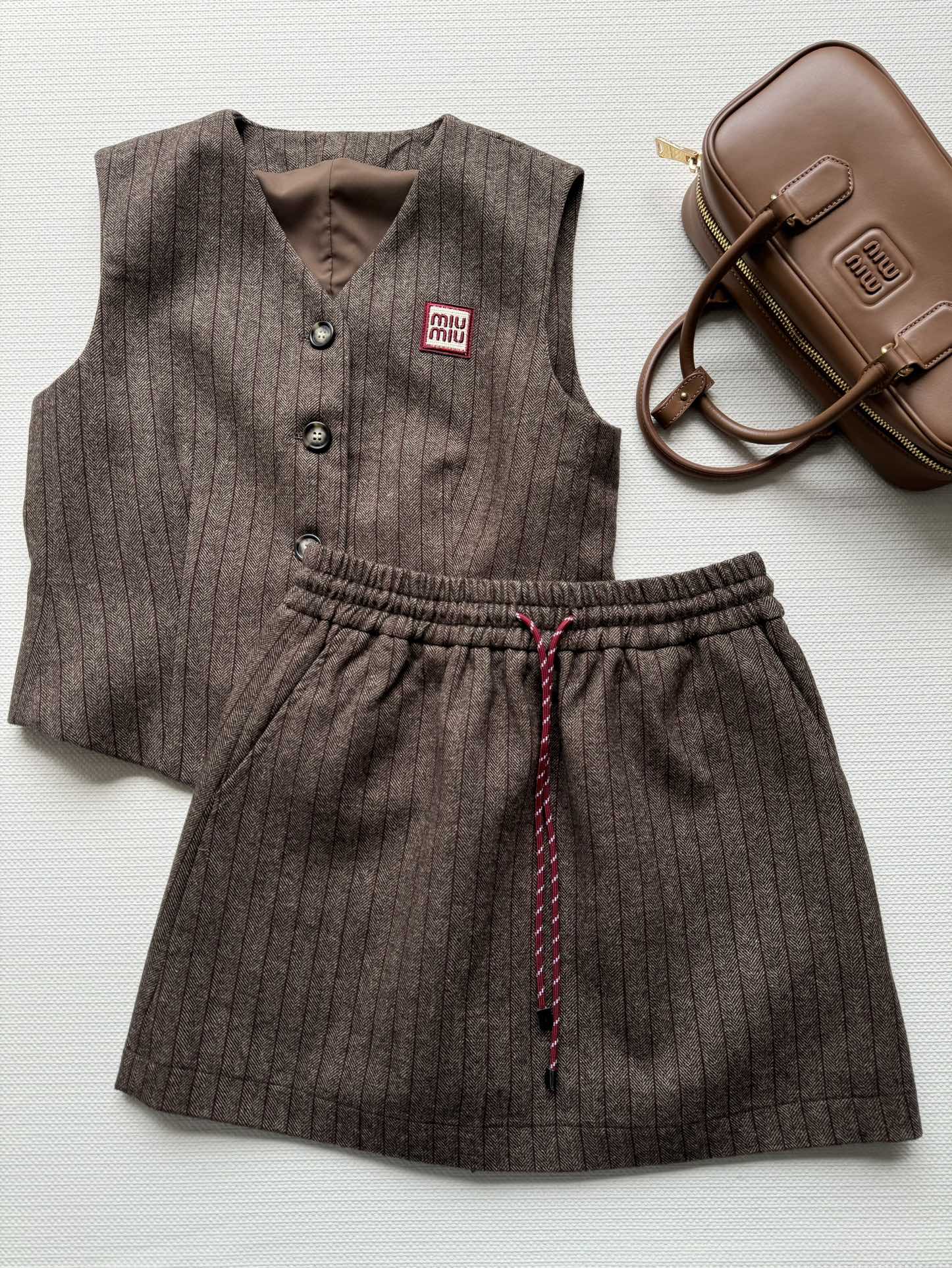 NO:493852,Miumi* new vest suit vest V-neck one-breasted button design, slim fit style, matched with drawstring elastic waist skirt, a set of upper body is super fashionable and elegant, classic vertical striped chest logo embroidery embroidery, retro flavor, versatile and fashionable style, no matter which sister is beautiful on the upper body, matched with berets and boots, Maillard outfit, easy to concave style~ The popular products are super recommended SML,,miumiu, boots, skirts, hats, alexander wang19860909miumi*新款马甲套装马甲V领一排扣设计 修身版型 搭配抽绳松紧腰半裙 一套上身超洋气显气质 经典竖条纹胸前标志logo刺绣点缀 复古味很足 百搭时尚款 无论哪个姐妹上身都是绝美,搭配贝雷帽 搭配靴子 美拉德穿搭 轻松凹出造型～爆款超推荐SML,,miumiu,boots,skirts,hats,alexander wang,Women's clothing