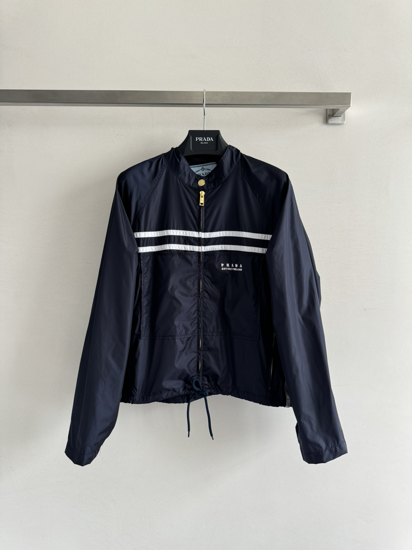 NO:420114,PRAD*25 new jacket jacket is made of recycled soft nylon material. It is light and environmentally friendly. The upper body is light and breathable. The classic jacket style is simple and outlined. The stand-up collar design adds more heroic spirit. The iconic double white stripes run across the chest, like the guide line on the track, eye-catching and dynamic, instantly breaking the monotony and becoming the visual focus hem drawstring design. It freely adjusts elasticity and adapts to different outfit needs. Whether it is sports and fitness, or walking on the street, you can easily grasp the effortless fashionable feeling, and wear classic elements into a rebellious new attitude. SML-,,prada, jackets & coats, jackets & coats, alexander wang19860909PRAD*25新款夹克外套采用再生软尼龙材质 轻盈又环保上身轻薄透气经典夹克版型 极简线条勾勒利落轮廓 立领设计增添更多飒爽英气 标志性双白条纹横贯胸前,似赛道上的指引线,醒目又充满动感,瞬间打破单调,成为视觉焦点下摆抽绳设计,自由调节松紧,适配不同穿搭需求,无论是运动健身,还是街头漫步,都能轻松拿捏不费力的时髦感,把经典元素穿出叛逆新态度SML-,,prada,jackets & coats,jackets & coats,alexander wang,Women's clothing