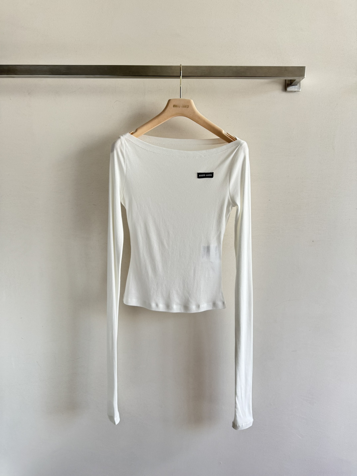 NO:435794,Miu Mi*25SS new micro-label one-collar top, stacked sleeve design is simply unsatisfactory!  This T-shirt is made of deeply processed cotton fabric, with a soft and comfortable effect that makes you want to wear it all the time. The close-fitting style is paired with a unique logo patch, which instantly enhances the overall fashion sense. It can create an off-shoulder collar or strapless look that can easily control various styles whether worn alone or layered. The one-line collar design cleverly reveals the collarbone and neck lines, instantly improving your temperament. Moreover, the mask texture of this T-shirt allows you to enjoy fashion while feeling the care of your skin. Wearing it, whether it is shopping, dating or attending a party, can make you the focus of the audience. The unique design of the logo patch highlights your classic style and unique personality. SML,,miumiu,tees, t-shirt,alexander wang19860909Miu Mi*25SS新品微标一字领上衣,堆堆袖设计简直让人爱不释手！这款T恤采用了深度加工的棉面料,微透效果柔软舒适到让你想一直穿着它,贴身的版型 搭配上独特的徽标贴饰,瞬间提升了整体的时尚感.可打造露肩领或抹胸造型无论是单穿还是叠穿都能轻松驾驭各种风格.一字领的设计更是巧妙地露出了锁骨和颈部线条,让你的气质瞬间提升.而且,这款T恤的面膜质地,让你在享受时尚的同时,也能感受到肌肤的呵护.穿上它,无论是逛街、约会还是参加聚会,都能让你成为全场的焦点.徽标贴饰的独特设计,更是彰显了你的经典风范与独特个性.SML,,miumiu,tees，t-shirt,alexander wang,Women's clothing