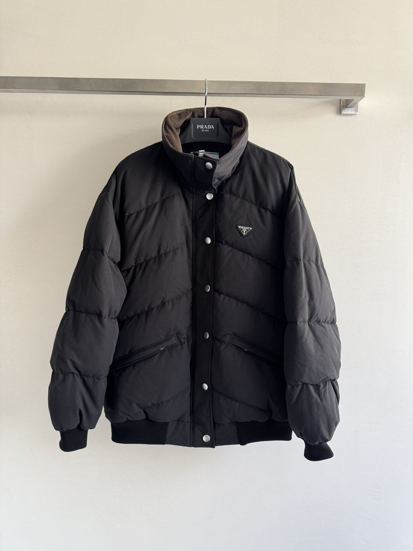 NO:560598,Comes with dust bag Prad* 25Fw new autumn and winter triangle logo poplin texture down jacket jacket originally developed!  High quality production!  The classic silhouette is reconstructed with a stand-up collar design, filled with 90% white goose down, and brown corduroy with a lapel collar. The retro texture of the neckline forms a material dialogue with the black poplin fabric, which not only adds layers but also hides a retro accent; the rhombus-filled velvet structure is full and three-dimensional, locking in warmth while creating a casual and non-bloated silhouette, suitable for multiple styles!  SML,,prada,jackets & coats,jackets & coats,down jacket,alexander wang19860909配防尘袋Prad* 25Fw秋冬新款 三角徽标府绸质感羽绒服夹克外套 原版开发！高版出品！以立领设计重构经典轮廓,90白鹅绒填充,可翻领棕色灯芯绒 领口的复古质感与黑色府绸面料形成材质对话,既添层次又暗藏复古腔调；菱格充绒结构饱满立体,在锁住暖意的同时,塑造出随性不臃肿的廓形,适配多元风格造型！SML,,prada,jackets & coats,jackets & coats,down jacket,alexander wang,Women's clothing