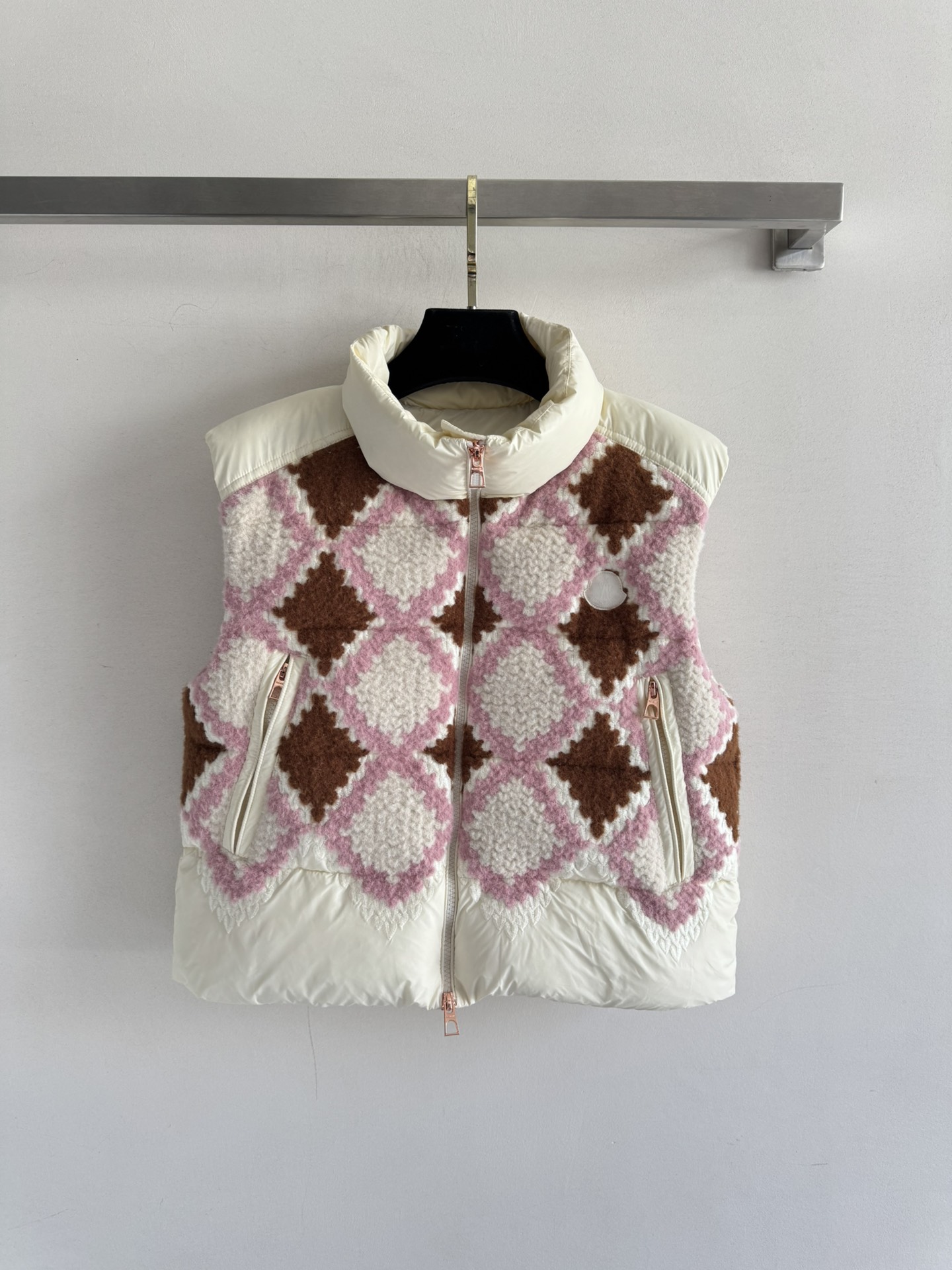 NO:549624,With dust bag Moncle*25FW new stand-up collar plaid short down vest adopts a short stand-up collar silhouette, neatly tailored instantly to enhance the waistline. The stand-up collar design can resist the cold wind and add a cool aura; the pink and brown diamond plaid knitted down fabric boldly combines the elegance of retro plaid with the iconic down warmth. The metal zipper and brand logo details achieve a delicate balance between exquisiteness and function. The upper body is fresh and warm. SML, down jacket, alexander wang19860909配防尘袋Moncle*25FW新款立领格纹短款羽绒马甲采用短款立领廓形,利落剪裁瞬间提升腰线,立领设计既能抵御寒风又添飒爽气场；粉棕菱格纹针织拼接羽绒面料,将复古格纹的优雅与标志性的羽绒保暖性大胆融合,金属拉链与品牌徽标细节,更在精致感与机能感间达成精妙平衡.上身清新又不失温暖感SML,,down jacket,alexander wang,Women's clothing