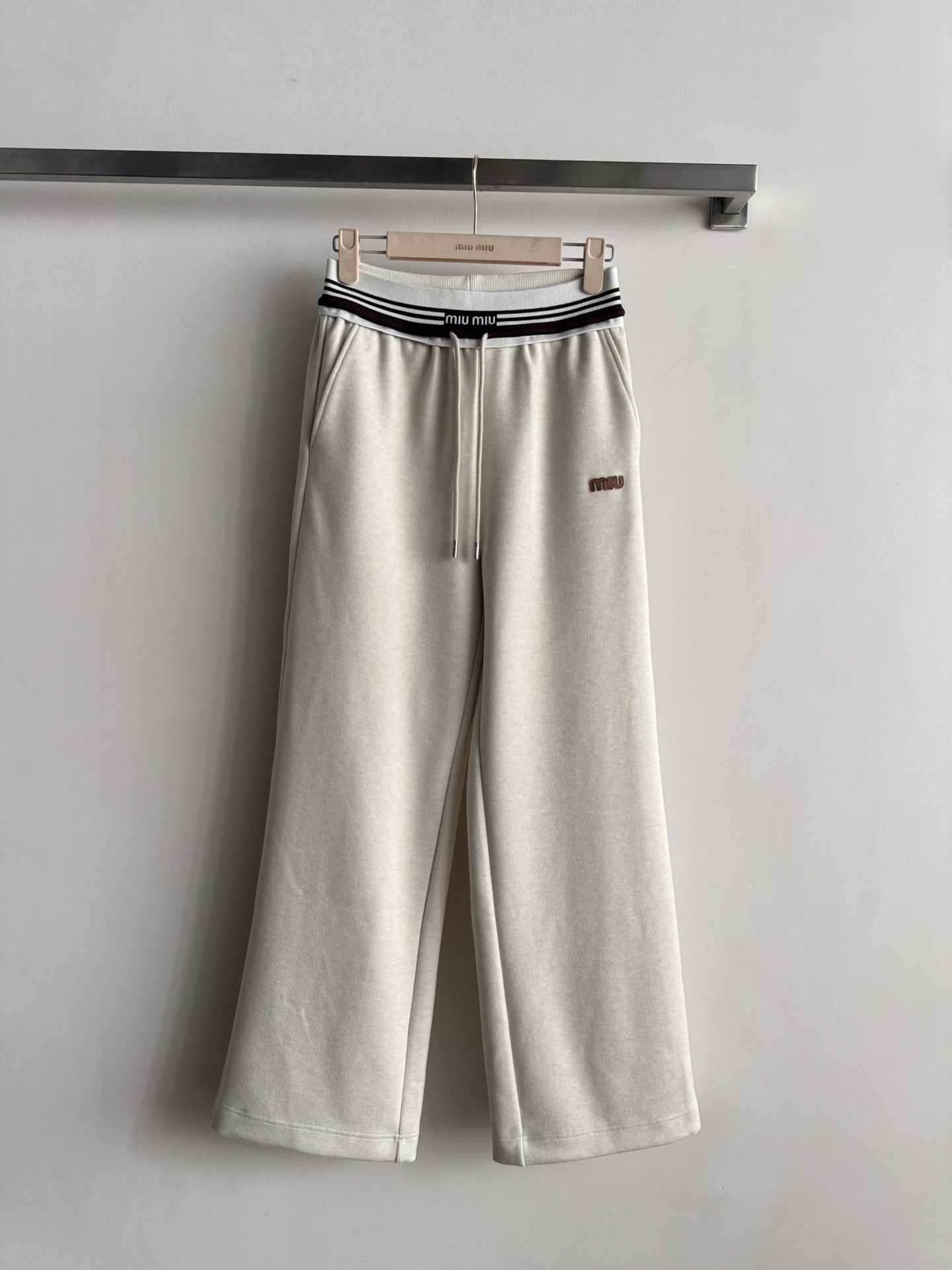 NO:663845,Miu  Mi*25 new autumn and winter embroidered casual sweatpants are made of high-quality wool blend fabric, soft and comfortable, suitable for daily wear. Loose straight pants + drawstring elastic waist, easy to adjust, suitable for a variety of body shapes. Striped webbing on the waistband and embroidered logo on the left leg, perfect brand recognition. In autumn and winter, they can be paired with sweaters or down jackets to easily create a casual or sports style. The overall design is simple and elegant, both practical and fashionable, suitable for daily outings or at home. Two-color SML,,miumiu,down  jacket, 19860909Miu Mi*25秋冬新款刺绣休闲卫裤,采用高品质羊毛混纺面料,柔软舒适,适合日常穿着.宽松直筒裤型+抽绳松紧腰,轻松调节,适合多种身材.裤腰条纹织带和左腿刺绣徽标,品牌辨识度满分.秋冬季节可搭配针织衫或羽绒服,轻松打造休闲或运动风.整体设计简约大方,兼具实用与时尚,日常出街或居家都很合适.两色SML,,miumiu,down jacket, ,Women's clothing