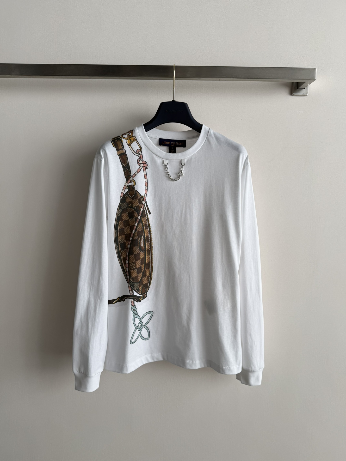 NO:708437,LV*26SS new chain printed long-sleeved T-shirt, made of white high-count cotton, soft and skin-friendly, regular fit cut is super figure-friendly!  The waist bag is embellished with printed metal chains, a casual yet high-end design. It can be easily used for daily casual and commuting. Paired with jeans or casual pants, it is casual and stylish, perfect for early spring wear!  SML,,louis vuitton,jeans,tees,t-shirt,19860909LV*26SS新款链条印花长袖T恤,白色高支棉材质,柔软亲肤,常规版型剪裁超显身材友好！腰包印花金属链条点缀,冷列又高级计.日常休闲、通勤都能轻松驾驭,搭配牛仔裤或休闲裤,随性又有型,超适合早春穿搭！SML,,louis vuitton,jeans,tees，t-shirt,,Women's clothing