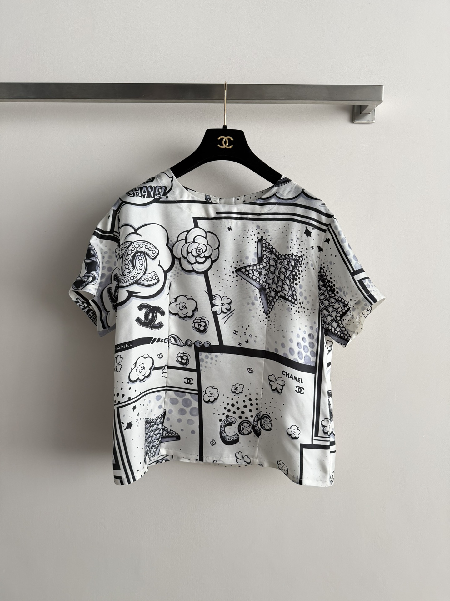 NO:716887,Chane26SS's new printed top is made of silk material that feels smooth and shiny. It has a black and white comic style print, embellished with double C logos and camellias and other classic elements. It is highly recognizable and has a loose fit. It is great to wear alone or layered, and can easily create a lazy and high-end atmosphere. Paired with simple trousers or skirts, it is elegant and fashionable, and can be easily worn in daily life or vacation. It is one of the classic items of Chane!  SML,,chanel,chanel,skirts,real silk,19860909Chane26SS新款印花上衣 采用真丝材质触感柔滑有光泽.黑白漫画风印花,点缀双C标志和山茶花等经典元素 辨识度超高,宽松版型,单穿或叠搭都很出彩,轻松打造慵懒高级氛围.搭配简约裤装或裙装,优雅又时髦,日常或度假都能轻松驾驭,是香家经典单品之一！SML,,chanel,chanel,skirts,real silk,,Women's clothing