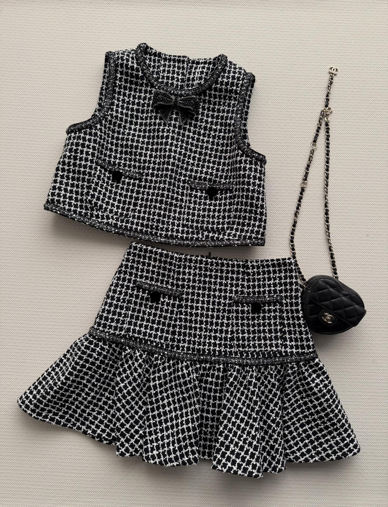 NO:717241,The new 26SS small fragrance suit black and white houndstooth tweed is retro and high-end!  The waistcoat top is decorated with a bow on the chest to neatly highlight the neck line. The high-waisted sha umbrella skirt has ruffled waist to highlight better body proportions. It is great to wear alone and layered. French elegance and girly feel are all easy to achieve. SML-,,skirts,19860909新款26SS小香风套装黑白千鸟格粗花呢 复古又高级！马甲上衣胸前装饰蝴蝶结 利落显颈部线条 高腰sha伞裙荷叶边收腰 凸显更好的身材比例 超赞单穿叠搭都OK 法式优雅与少女感通通轻松拿捏 SML-,,skirts,,Women's clothing