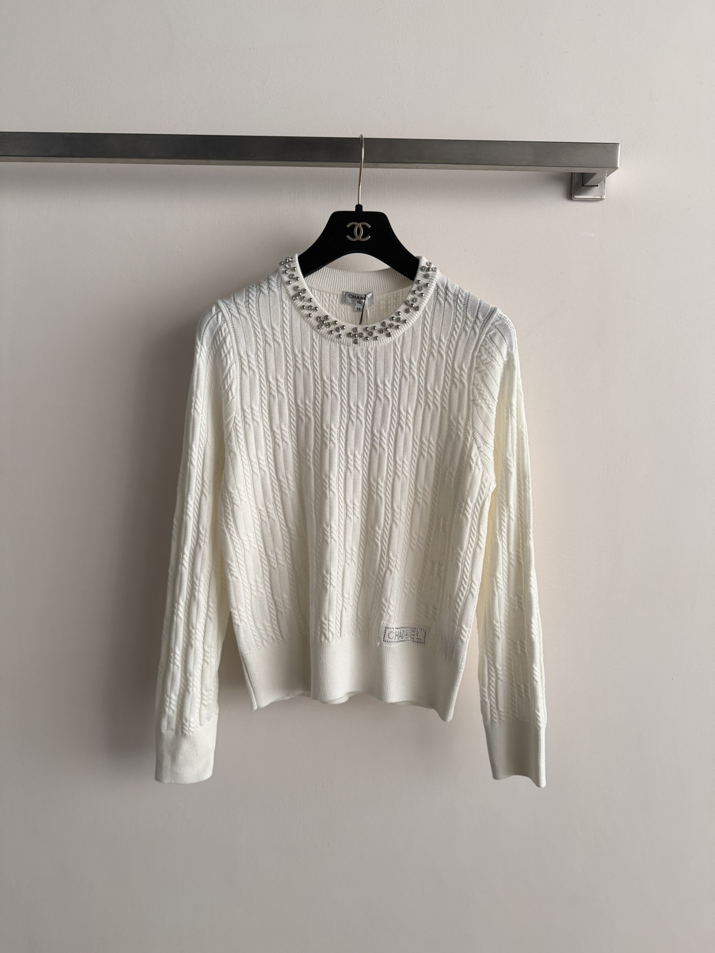 NO:717247,The new CHANE*26SS sweater adopts cable knitting technology. The neckline is decorated with bright diamonds and the hem is decorated with diamond letters, which symbolizes brand recognition and fashion sense!  Wear alone or layered to create a sophisticated and elegant look SML-,,chanel,19860909CHANE*26SS新款针织衫采用绞花编织工艺 领口处亮钻装饰衣摆处烫钻字母 章显品牌辨识度与时尚感！单穿或叠搭都能穿出精致的优雅SML-,,chanel,,Women's clothing