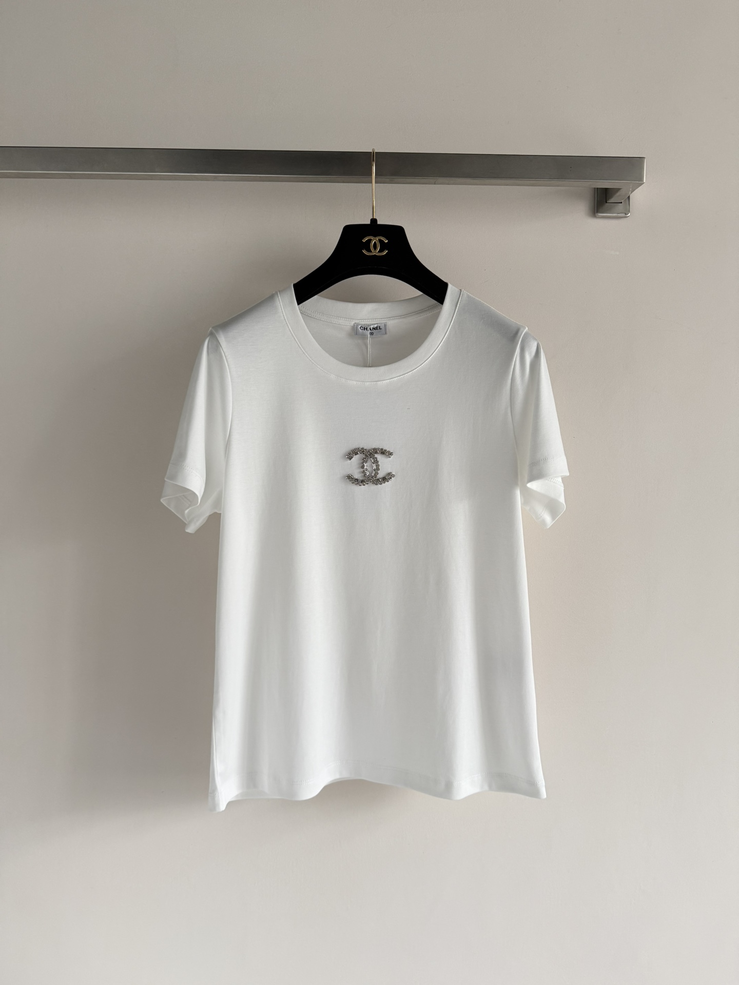 NO:733987,CHANE*26SS new beaded logo short-sleeved T-shirt, made of light and breathable cotton fabric, decorated with the iconic double C Logo on the chest, inlaid with exquisite beading, low-key and luxurious. It not only retains the versatile attributes of the basic style, but also becomes the 'finishing touch' in the outfit because of the brand logo and detailed design, suitable for creating a simple and high-end or mixed style. SML,,chanel,T-shirt,tees,t-shirt,19860909CHANE*26SS新款珠饰Logo短袖T恤,采用轻盈透气的棉质面料,胸前点缀着标志性的双C Logo,由精致的钉珠饰镶嵌而成,低调中透着奢华.它既保留了基础款的百搭属性,又因品牌标识和细节设计成为穿搭中的“点睛之笔”,适合打造简约高级感或混搭风格.SML,,chanel,T-shirt,tees，t-shirt,,Women's clothing