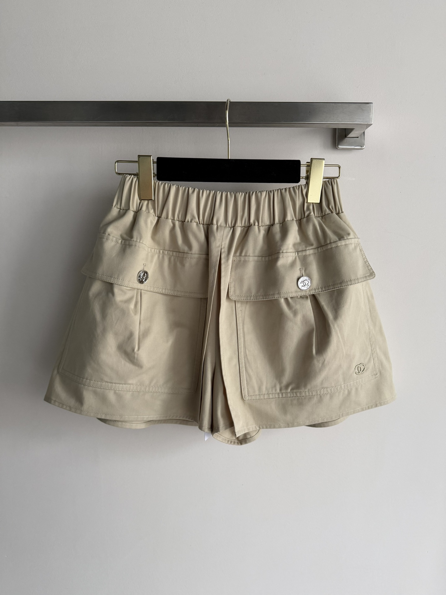 NO:738872,CHANE*26SS series work shorts.  Khaki light and thin fabric, super breathable for summer wear!  The high-waisted elastic design is comfortable and makes the legs look longer, and is very friendly to little people ~ Large pockets on both sides + metal buttons are practical and detailed, and the double C embroidery on the lower right corner is very recognizable!  It can be easily paired with a T-shirt or shirt for daily outings and vacations. Fashionable and versatile, it is a must-have item in your summer wardrobe!  SML,,chanel,shorts,shirts,tees,t-shirt,19860909CHANE*26SS系列工装短裤．卡其色轻薄面料,夏天穿超透气！高腰松紧设计,舒适又显腿长,对小个子超友好～两侧大口袋+金属纽扣,实用又有细节感,右下角双C刺绣超有辨识度！日常出街、度假都能轻松搭配T恤或衬衫.时髦又百搭,是夏季衣橱必备单品！SML,,chanel,shorts,shirts,tees，t-shirt,,Women's clothing