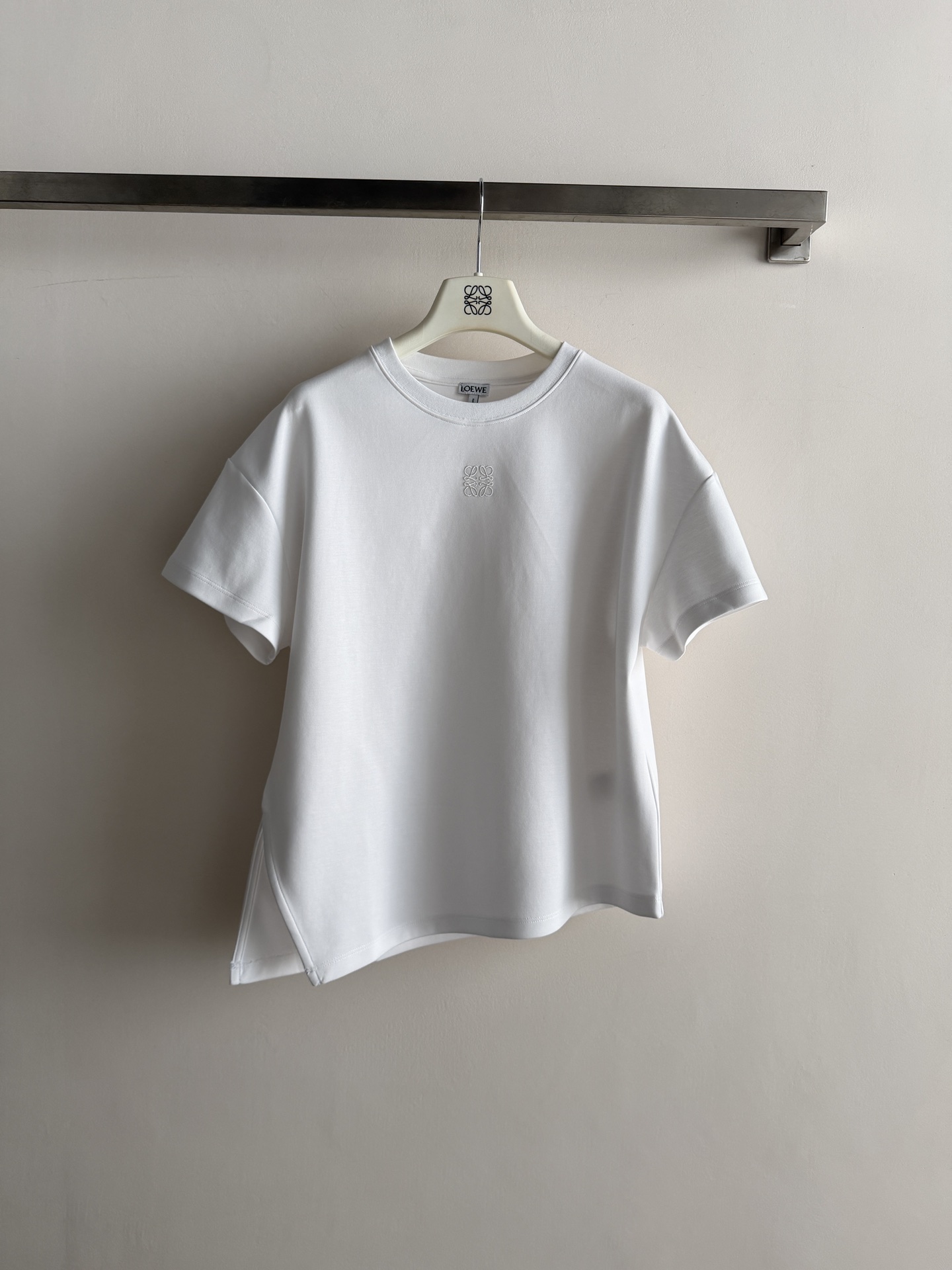 NO:805276,Loew*26SS new irregular short-sleeved T-shirt, classic loose fit, thick and textured fabric, asymmetric hem slit tailoring, showing the difference of simple T-shirts, logo embroidery on the chest, highlighting the brand image, versatile for daily fashion and leisure!  SML,,loewe,T-shirt,tees,t-shirt,19860909Loew*26SS新款不规则短袖T恤,经典宽松版型,面料厚实有质感,不对称下摆开衩剪裁,展示着简约T恤的与众不同,胸前logo刺绣点缀,彰显品牌形象,日常时尚休闲百搭款！SML,,loewe,T-shirt,tees，t-shirt,,Women's clothing