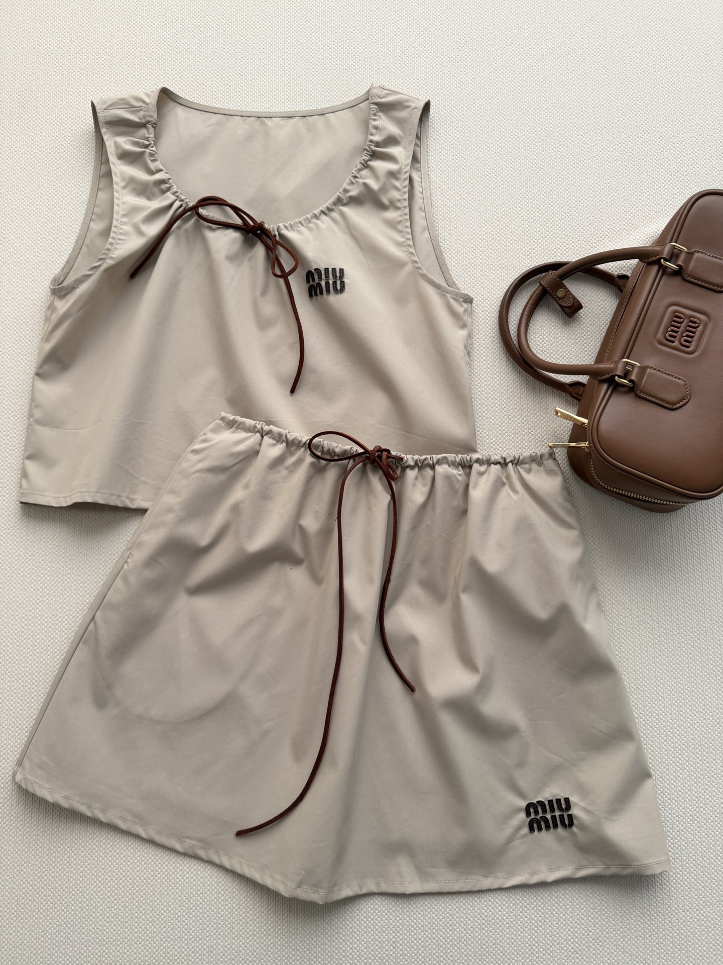 NO:806951,Miu Mi26 spring and summer series drawstring skirt, made of khaki cotton-like fabric, breathable and crisp, super comfortable to wear in summer!  The drawstring design on the waist can be freely adjusted to the size. The letter decoration on the hem highlights the brand recognition and can be matched with a series of tops. The overall style of the set is lazy and playful, which can be easily managed on a beach vacation. It is a must-have and versatile item in the summer wardrobe!  SML,,miumiu,skirts,19860909Miu Mi26春夏系列抽绳半裙,卡其色棉感面料,透气又挺括,夏天穿超舒服！腰部抽绳设计可自由调节大小下摆字母装饰 彰显品牌辨识度可以搭配系列上衣 一套整体风格慵懒俏皮,海边度假都能轻松驾驭,是夏季衣橱必备百搭单品！SML,,miumiu,skirts,,Women's clothing